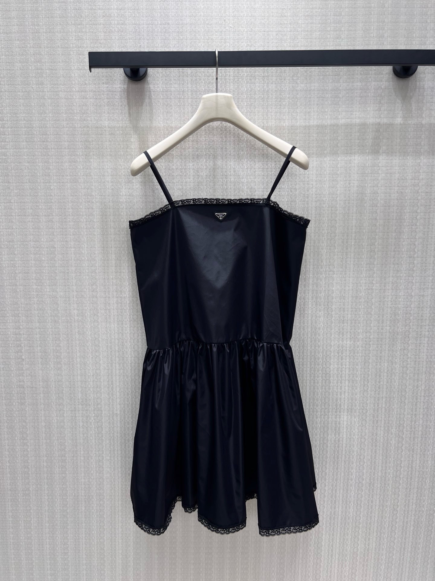 NO:907769,26 new spring and summer dresses  Pra**'s classic triangle logo sets the tone of elegance, and the shiny nylon has a low-key soft texture. Thin suspenders outline the soft lines of the shoulders and neck, and the delicate lace trim on the neckline and skirt adds a feminine atmosphere. The natural pleats at the waist and hem reveal a fluffy and draping skirt. Cool tone  The black color balances the sweet and cool temperament, and the neat short cut is light and smart. It is suitable for layering suits for commuting or wearing alone for appointments. It wears restrained girlish elegance on the body. Detailed pictures of real-life photos of sml in stock, prada, skirts, business  suit,1986090926春夏新品连衣裙 Pra**经典三角徽标定格优雅基调,亮面尼龙自带低调柔光质感.细吊带勾勒肩颈柔和线条,领口与裙摆细腻蕾丝镶边揉入柔媚氛围,腰部下摆自然抽褶散出蓬松垂坠裙摆.冷调黑平衡甜酷气质,利落短款剪裁轻盈灵动,通勤叠穿西装、单穿赴约皆适配,把克制的少女贵气穿在身上.现货smL实拍细节图,,prada,skirts,business suit,,Women's clothing