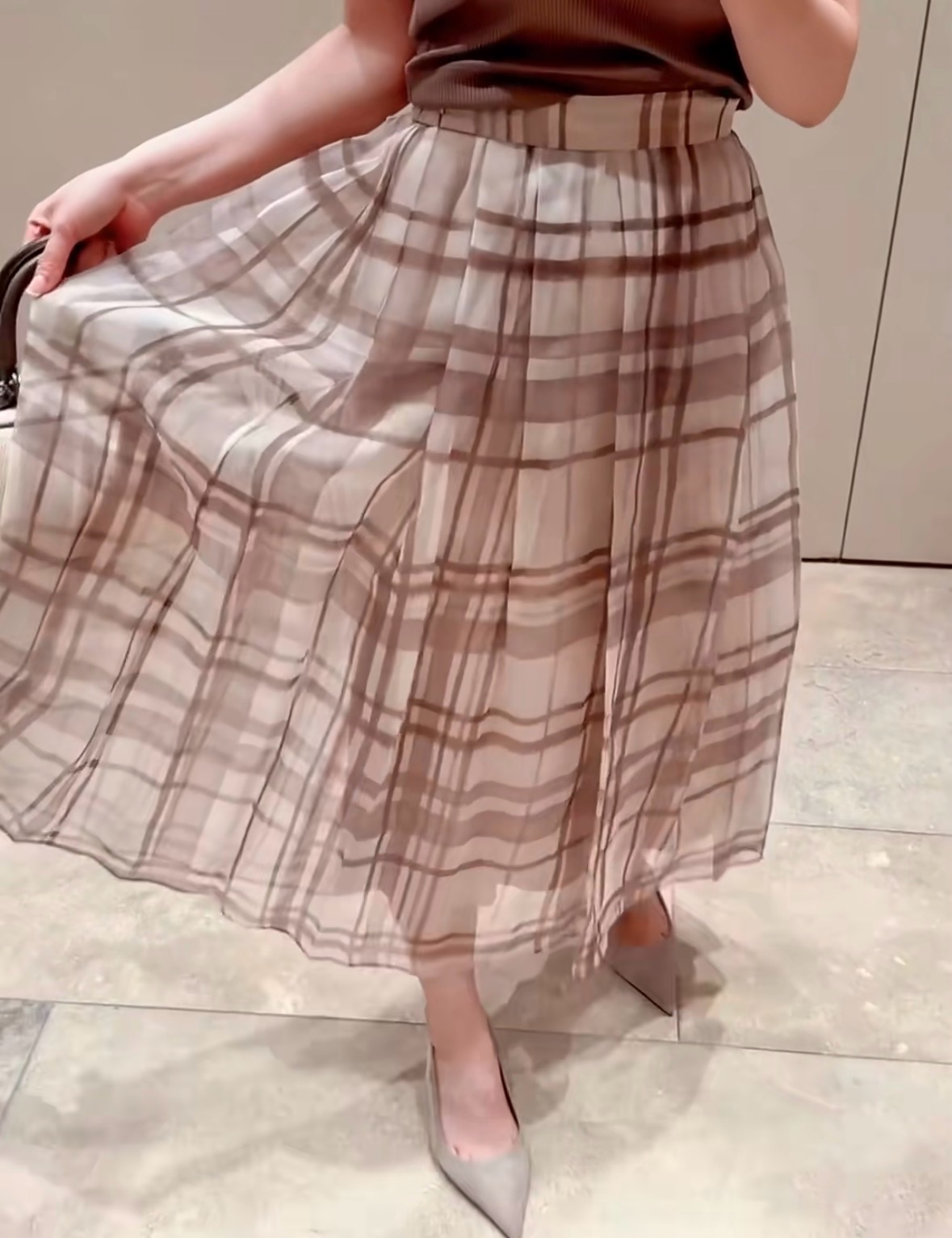 NO:908531,The new spring and summer skirt for 26 spring and summer has an elegant background with a soft mist brown plaid. The light gauze material diffuses like the soft light of twilight, giving it a hazy texture. The neat pleats support the drape silhouette, creating a gentle arc when walking, and the high-waist tailoring outlines the waistline. It is suitable for commuting and daily life. Pair it with a knitted sweater to bring a sense of relaxation and luxury, hiding Italian elegance in every gentle step. Ready for sale smL,,skirts,1986090926春夏新品半裙 以柔雾棕格纹晕染优雅底色,轻盈纱料如暮色柔光漫开,自带朦胧质感.利落褶裥撑起垂坠廓形,行走间漾开温柔弧度,高腰剪裁勾勒腰线.适配通勤与日常,搭配针织衫便自带松弛高级感,将意大利式优雅藏进每一步轻缓步调里.现货出售smL,,skirts,,Women's clothing
