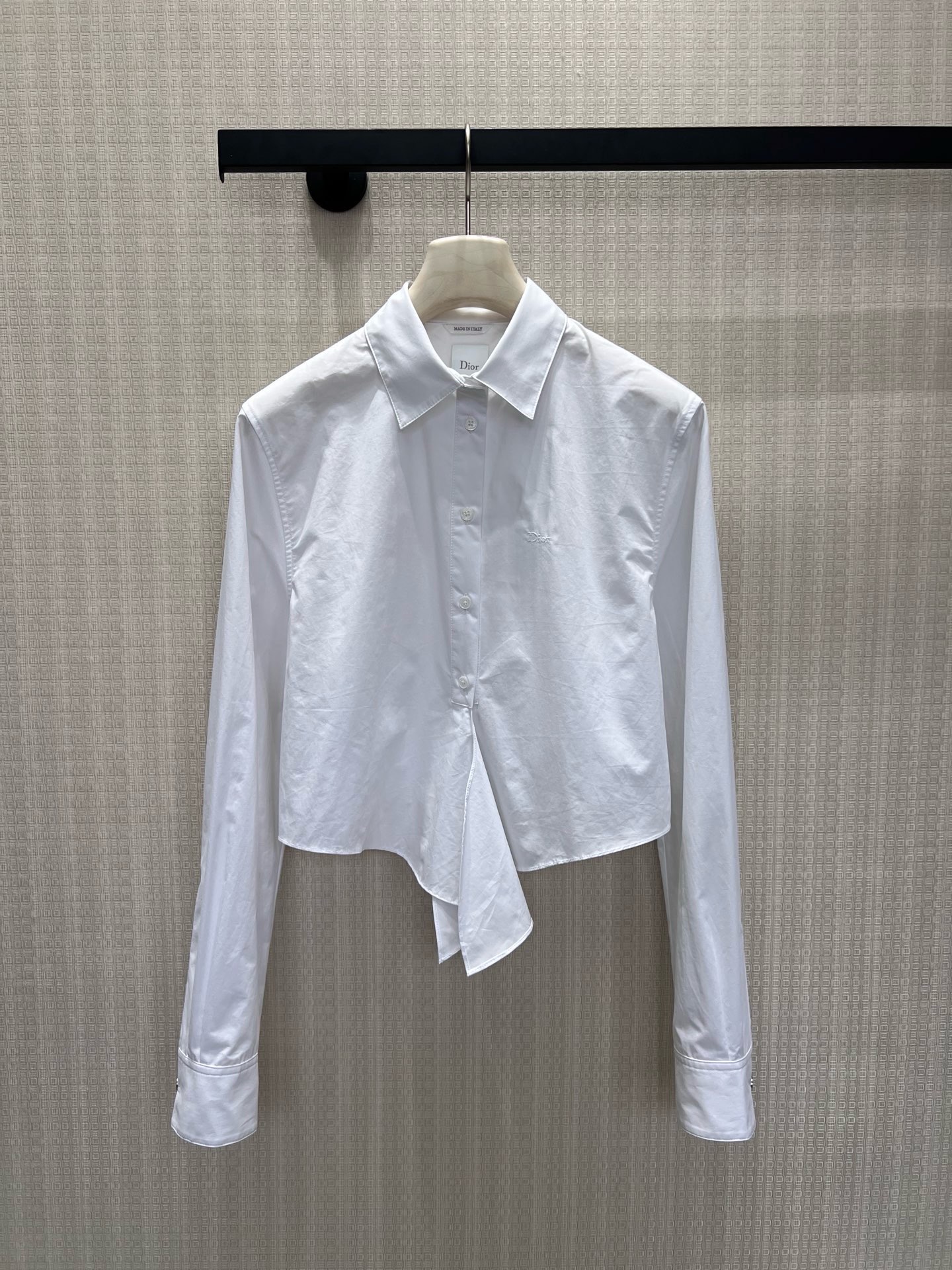 NO:910549,Batch 26 new spring and summer Dio** white shirt's elegance is hidden in the details. The crisp cotton poplin outlines neat lines, the short tailoring breaks the rules, and the asymmetric hem hides ingenuity. The embroidered logo on the chest tells the brand's heritage in a low-key manner, and the neat lapels and mother-of-pearl buttons combine the classic and the avant-garde. The white shirt is not only a basic style, but also synonymous with high-end sense, suitable for every kind of exquisite daily life that is not defined. Ready for sale smL  Actual detailed pictures, dior, shirts,19860909批 26春夏新品 Dio**白衬衫的优雅,藏在细节里.挺括棉府绸勾勒利落线条,短款剪裁打破常规,不对称下摆暗藏巧思.胸口刺绣标识低调诉说品牌底蕴,利落翻领与珍珠母贝纽扣,将经典与先锋融合.白衬衫不止基础款,更是高级感的代名词,适配每一种不被定义的精致日常.现货出售smL 实拍细节图,,dior,shirts,,Women's clothing
