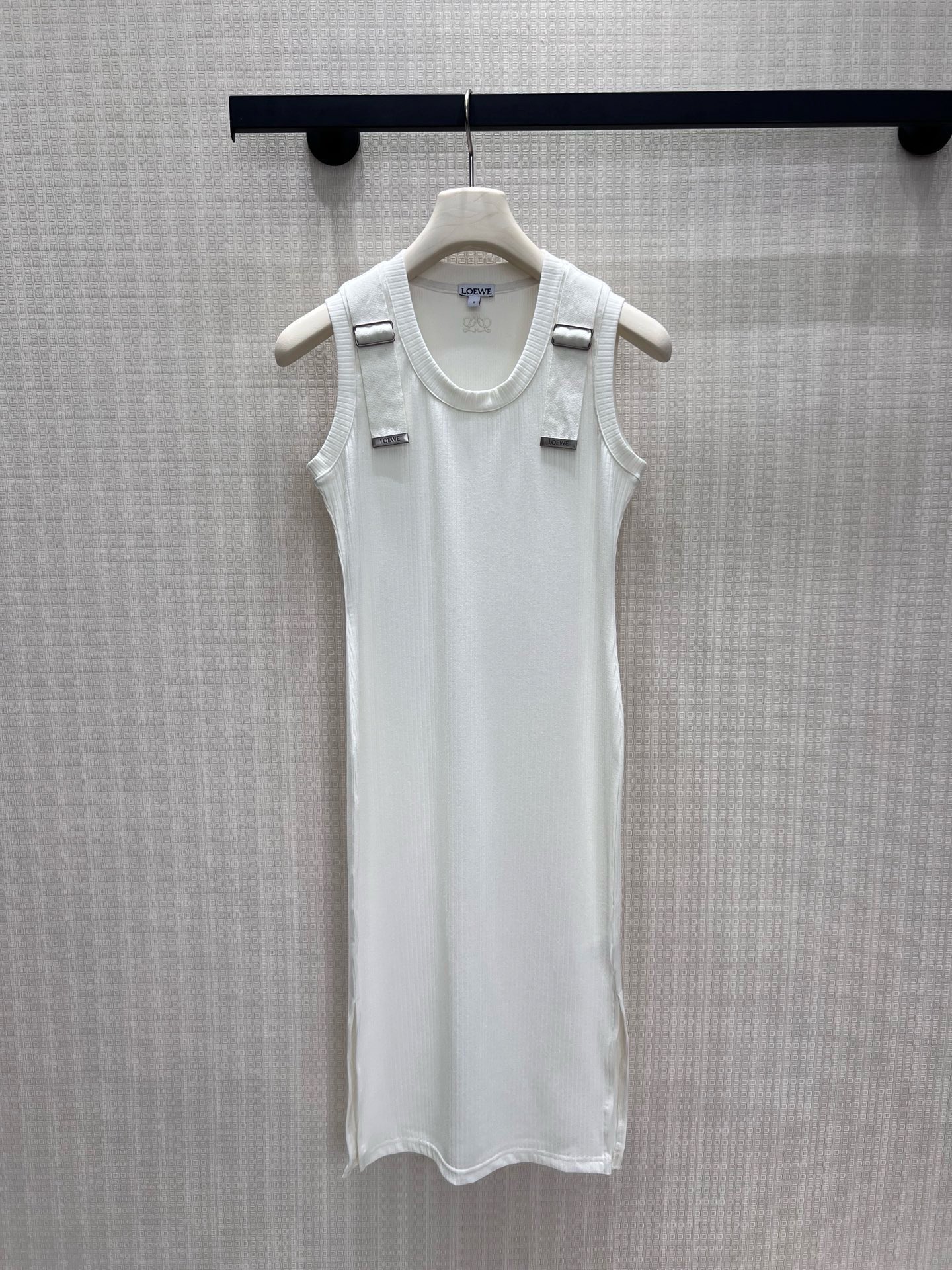 NO:924028,26 spring and summer new products  LOE** minimalist style sleeveless knitted vest dress, full of warm and relaxed light luxury texture. The delicate vertical pit strip fabric has a soft drape feeling, which fits the body shape without a sense of restraint. The round neck ribbed edge is neat and clean, and the exclusive metal nameplate logo on the shoulder strap low-key highlights the brand heritage, and the side slits  Designed to increase walking agility. The pure off-white color is soft and durable, and the style is simple and elegant. It brings a cool and high-end atmosphere when worn alone. It is suitable for commuting and leisure travel. It interprets the restrained and gentle minimalist aesthetics of the Spanish brand. Detailed pictures of real-life sml in stock, loewe, skirts,1986090926春夏新品 LOE**极简风无袖针织背心裙,把温润松弛的轻奢质感拉满.细腻竖坑条面料自带柔和垂坠感,贴合身形却无束缚感.圆领罗纹收边利落干净,肩带专属金属铭牌标识低调彰显品牌底蕴,侧边开衩设计增添行走灵动度.纯净米白温柔耐看,版型简约大气,单穿自带清冷高级氛围,通勤、休闲出行皆适配,诠释西班牙品牌克制温柔的极简美学.现货smL实拍细节图,,loewe,skirts,,Women's clothing