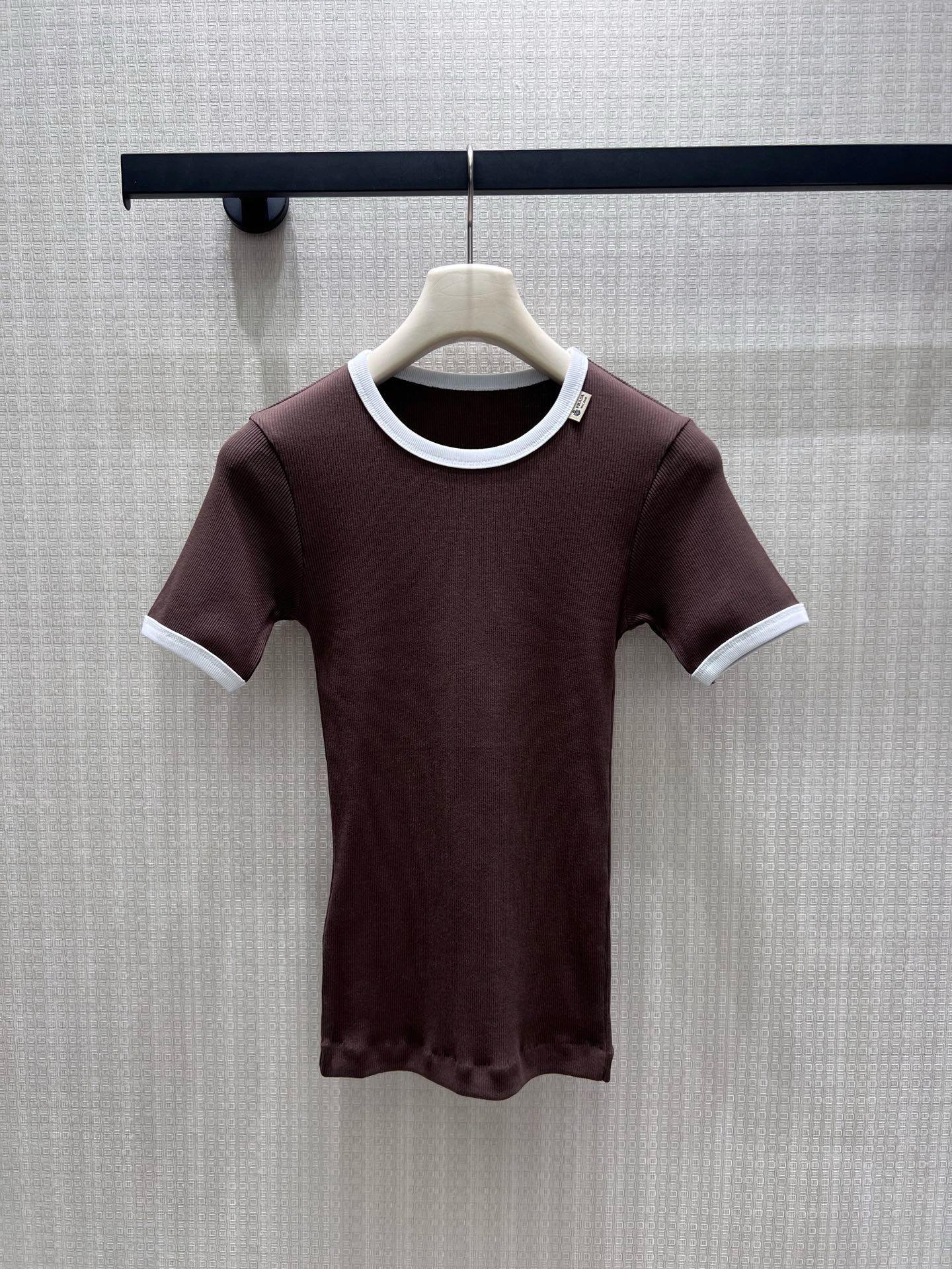 NO:924100,26 spring and summer new short-sleeved pra**  The dark brown background color is paired with a clean white contrasting round collar and sleeve edges, replicating the minimalist retro aesthetics of the brand. The delicate vertical pit strip knitted elastic is skin-friendly, fits the body shape and outlines soft curves, and the neat short version optimizes body proportions. The small label on the neckline is low-key and hides the brand logo.  , no superfluous and complicated design, it brings a retro elegance when worn alone, and is suitable for matching with skirts and trousers. It can easily create a low-key and luxurious commuting atmosphere. Ready-made SmL real-shot details, prada, skirts, T-shirt,1986090926春夏新品短袖 pra** 深棕底色搭配干净白撞色圆领与袖边,复刻品牌极简复古美学.细腻竖坑条针织弹力亲肤,贴合身形勾勒柔和曲线,利落短版型优化身材比例.领口小标低调暗藏品牌标识,无多余繁复设计,单穿自带复古贵气,搭配半裙、西裤都适配,轻松拿捏低调轻奢通勤氛围感.现货smL实拍细节图,,prada,skirts,T-shirt,,Women's clothing