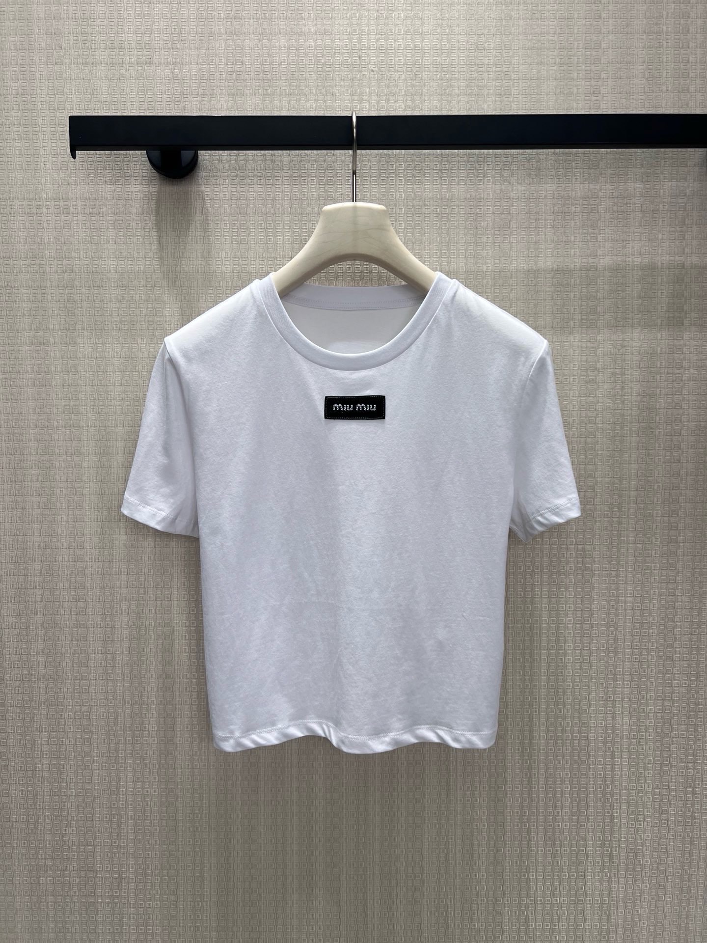 NO:926617,Batch 26 spring and summer new arrivals short sleeves  miu**'s iconic minimalist girlish short T-shirt, clean pure white background is pure and eye-catching, the small square mark is low-key to brand the brand genes, low-key and not exaggerated. The slightly narrowed short version optimizes body proportions, is friendly to small people, and the round neck accommodates various neck lines. The soft, waxy and breathable cotton material is both comfortable and drapey, suitable for commuting with skirts and casual wear with jeans. It fades away excessive sweetness, retains just the right amount of luxury and gentleness, and can be worn casually for daily wear to give a sense of refinement and nobility. Ready stock smL  Actual detailed pictures,,miumiu,skirts,T-shirt,19860909批 26春夏新品 短袖 miu**标志性极简少女感短T,干净纯白底色纯粹耐看,小方标低调烙印品牌基因,低调不浮夸.微收短款版型优化身材比例,小个子友好,圆领包容各种脖颈线条.软糯透气棉料兼顾舒适与垂感,通勤配半裙、休闲搭牛仔皆适配,褪去过度甜腻,保留恰到好处的轻奢温柔,日常随手穿出精致贵气感.现货smL 实拍细节图,,miumiu,skirts,T-shirt,,Women's clothing