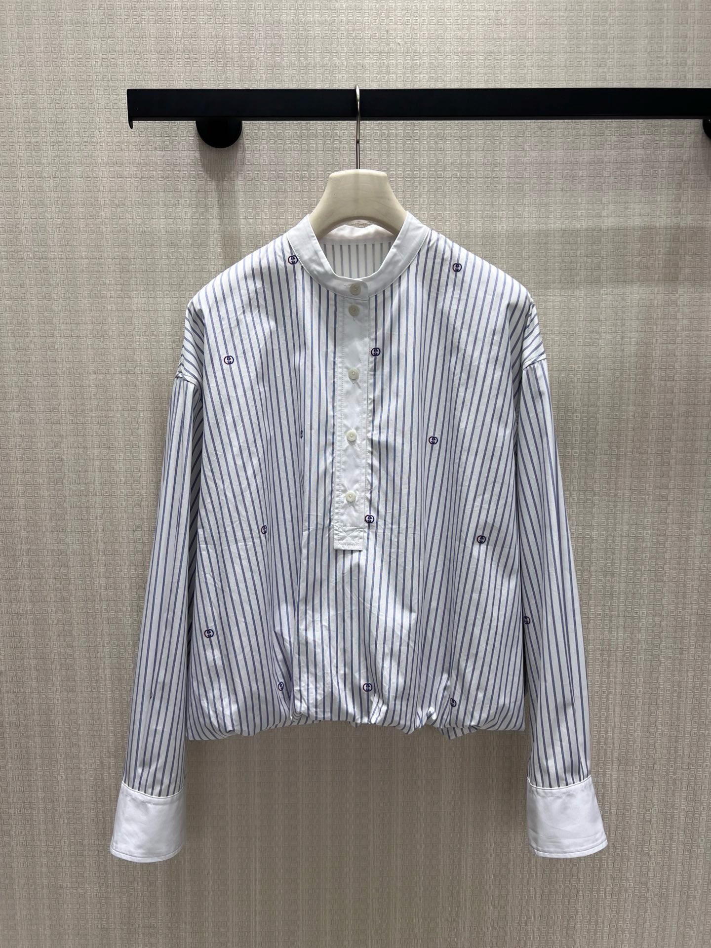 NO:933571,26 new spring and summer shirts. Light blue pinstripes bring a refreshing atmosphere, and scattered double G embroidery low-key reveals the brand's heritage. The stand-up collar and half-open buttons weaken the seriousness of commuting, and the pleated short tailoring at the hem optimizes the proportions. The contrasting wide cuffs hide exquisite ingenuity. The loose off-shoulder version accommodates all body shapes, is simple and not exaggerated, and takes into account daily casualness and light luxury texture. It can be easily adapted to skirts and trousers, showing a timeless retro elegance. In stock 36/38/40  Actual detailed pictures,,skirts,shirts,1986090926春夏新品衬衫 浅蓝细条纹自带清爽氛围感,散落双G刺绣低调释放品牌底蕴.立领半开扣弱化通勤严肃感,下摆收褶短款剪裁优化比例,撞色宽袖口暗藏精致巧思.宽松落肩版型包容各类身形,简约不浮夸,兼顾日常随性与轻奢质感,轻松适配半裙、西裤,演绎永不过时的复古优雅.现货36/38/40 实拍细节图,,skirts,shirts,,Women's clothing