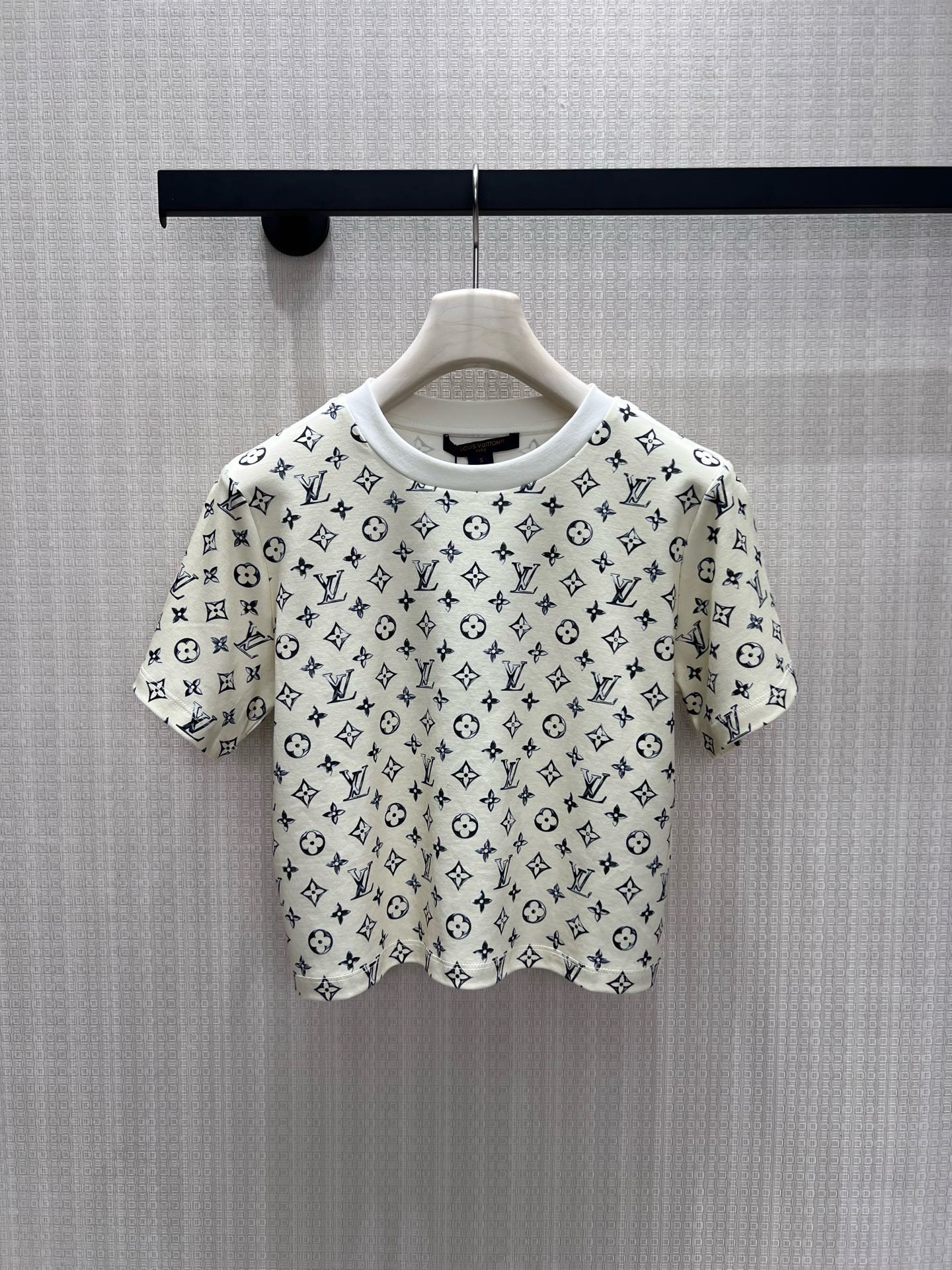 NO:933605,26 spring and summer new arrivals, short sleeves, milky white background with logo printed all over  The low-saturated blue pattern weakens the publicity and reveals the brand's heritage in a restrained manner. The contrasting round neckline outlines the soft shoulder line, and the neat short cut raises the waistline, easily creating a superior head-to-body ratio. The soft and waxy skin-friendly fabric is both breathable and drapey, and the simple version is suitable for all kinds of bottoms without complicated matching. It has a low-key and luxurious texture in a relaxed manner, and can be worn for daily commuting and casual outings to create a high-end atmosphere. Detailed photos of the actual sml, T-shirt,1986090926春夏新品 短袖 奶白底色满印logo 低饱和蓝调纹样弱化张扬,内敛流露品牌底蕴.撞色圆领勾勒柔和肩线,利落短款剪裁抬高腰线,轻松打造优越头身比例.软糯亲肤面料兼顾透气与垂感,简约版型适配各类下装,无需繁杂搭配,松弛间拿捏低调轻奢质感,日常通勤、休闲出街皆能穿出高级氛围感.现货smL实拍细节图,,T-shirt,,Women's clothing