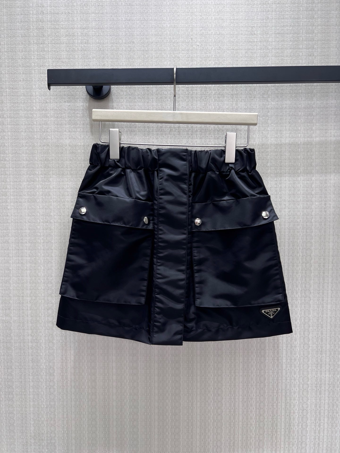 NO:935203,26 spring and summer new skirt Pra** classic nylon skirt, integrating workwear aesthetics and urban neatness. The crisp nylon fabric has a matte texture, the bud waistband is equipped with three-dimensional workwear pockets, and the silver rivets and triangular logo hide the brand genes. The neat short cut optimizes the proportions, has both a cool and high-end feel, and can easily create an effortless high street look. Ready for sale sml real shot details, prada, skirts,1986090926春夏新款半裙 Pra**经典尼龙半裙,将工装美学与都市利落感融为一体.挺括尼龙面料自带哑光质感,花苞腰头搭配立体工装口袋,银色铆钉与三角徽标暗藏品牌基因.利落短款剪裁优化比例,兼具酷飒与高级感,轻松打造不费力的高街造型.现货出售smL 实拍细节图,,prada,skirts,,Women's clothing