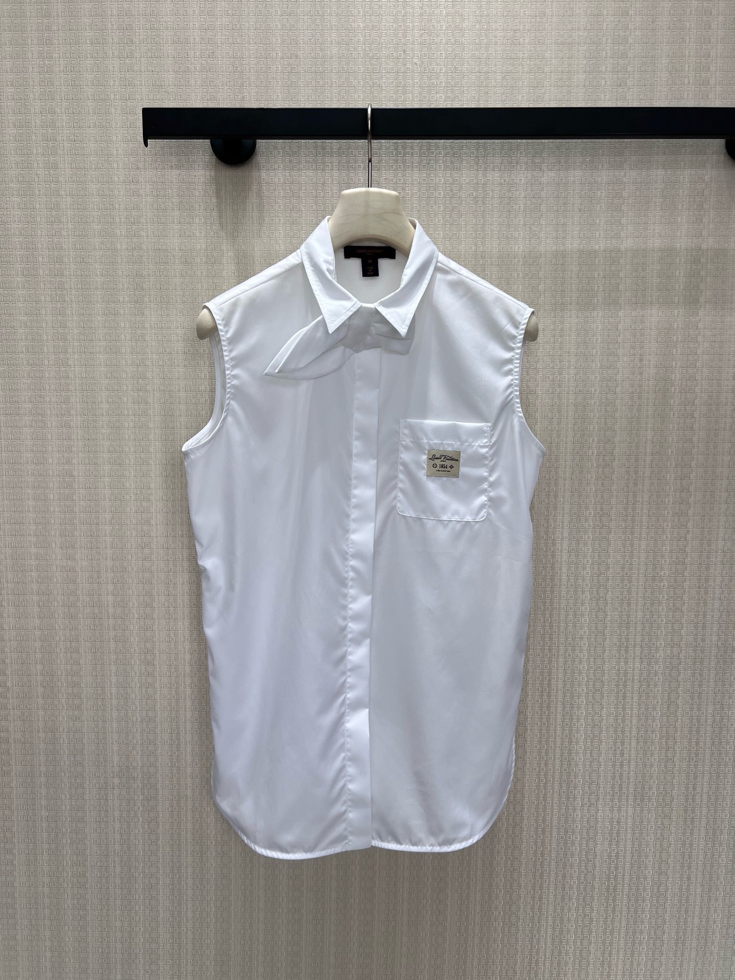 NO:935227,26 new spring and summer shirts. Sleeveless tailoring, crisp and neat, pointed collar with unique bow tie design, blending girlish tenderness and French luxury. The patch label on the chest hides the brand details, the curved hem modifies the body shape, and the loose version accommodates all body types. It is refreshing and elegant to wear alone, with long sleeves underneath for outstanding layering. The simple white shirt breaks away from the monotony of basic styles, is low-key and refined, and can be worn for daily commuting with a calm and high-end atmosphere. In stock 36/38/40  Actual detailed pictures, shirts,1986090926春夏新品 衬衫 无袖剪裁清爽利落,尖领搭配别致领结设计,糅合少女温柔与法式轻奢.胸前贴布标签暗藏品牌细节,弧形下摆修饰身形,宽松版型包容各种身材.单穿清爽雅致,内搭长袖叠穿层次出众,简约白衬衫跳出基础款单调,低调精致,通勤日常都能穿出从容高级氛围感.现货36/38/40 实拍细节图,,shirts,,Women's clothing
