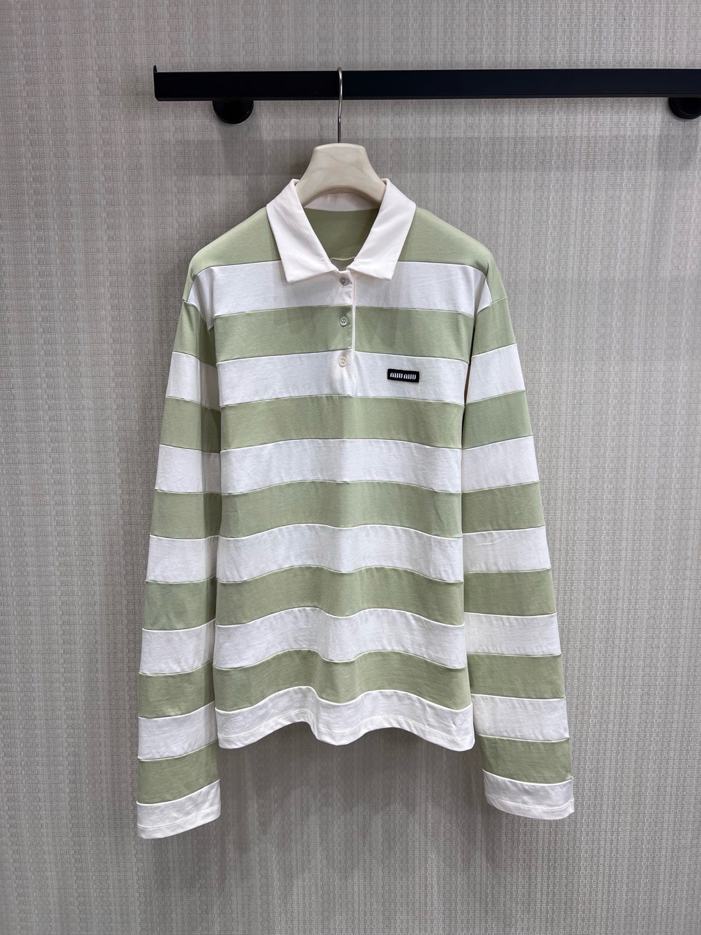NO:944649,Miu** fresh green and white striped Polo shirt reinterprets the classic Polo silhouette with the brand's iconic academic style language.  Soft light green and milky white wide stripes, paired with neat lapels and a three-button placket, weaken the formality of the traditional Polo and inject a relaxed girlish feel. The exquisite brand logo on the chest is low-key yet recognizable, perfectly combining retro college temperament with modern casualness.  Beautiful balance. The skin-friendly cotton fabric is selected, soft and breathable, and the slightly loose version is very tolerant to the body. Whether it is paired with denim trousers to create a lazy daily life, or paired with a pleated skirt to restore the college atmosphere, you can easily achieve a high-end sense of relaxation. Ready for sale sml  Actual detailed pictures,,miumiu,skirts,19860909Miu**清新绿白条纹Polo衫,以品牌标志性的学院风语言,重释经典Polo廓形. 柔和的浅绿与奶白宽条纹,搭配利落翻领与三粒扣门襟,弱化了传统Polo的正式感,注入松弛的少女感.胸前精致的品牌标识,低调却自带辨识度,将复古学院气质与现代休闲感完美平衡.甄选亲肤棉质面料,软糯透气,微宽松的版型对身材包容度极高,无论是搭配牛仔长裤打造慵懒日常,还是搭配百褶裙还原学院氛围,都能轻松拿捏高级松弛感.现货出售smL 实拍细节图,,miumiu,skirts,,Women's clothing