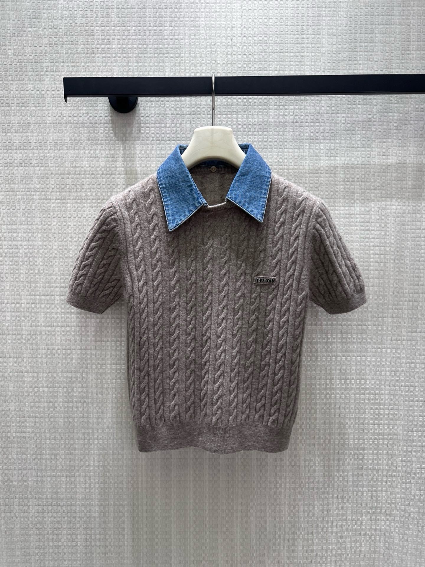 NO:950657,26 early autumn new products  The miu** twist texture is soft and skin-friendly, and the spliced denim lapels collide with the retro college feel, adding a layered atmosphere. The metal round buckle is simple and exquisite, and the mini logo on the chest is a low-key mark of the brand style. The short cut optimizes the proportions and can be easily elongated.  The body shape and long-sleeved version are suitable for multi-season wear. The oatmeal gray color is soft and durable, and it is gentle and age-reducing when worn alone. It is suitable for wearing with a shirt inside or a skirt outside. It has both girlish sweetness and light luxury texture. It is great for daily commuting and dating. In stock 36/38/40  Actual detailed pictures,,miumiu,skirts,shirts,1986090926早秋新品 miu**麻花纹理软糯亲肤,拼接牛仔翻领碰撞复古学院感,层次氛围感拉满.金属圆扣简约精致,胸口迷你logo低调标识品牌格调.短款剪裁优化比例,轻松拉长身形,长袖版型适配多季穿搭.燕麦灰柔和耐看,单穿温柔减龄,内搭衬衫、外搭半裙皆适配,兼具少女清甜与轻奢质感,日常通勤、约会都很出彩.现货36/38/40 实拍细节图,,miumiu,skirts,shirts,,Women's clothing