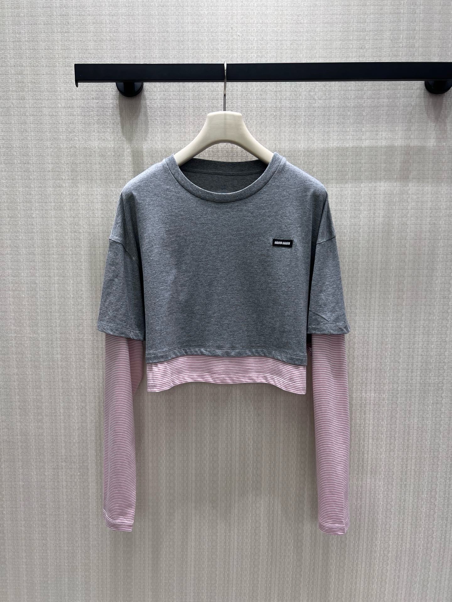 NO:954937,26 spring and summer new products  Miu** fake two-piece long sleeves, heather gray short sleeves layered with pink stripes as a base, the layers are relaxed and proportional. The soft round neck fits the neck, and the mini woven label on the chest low-key logo brand tone. Soft, waxy and skin-friendly cotton fabric, breathable and comfortable. Drop shoulder loose fit bag  It flatters the body shape, the short cut raises the waistline, and the sweet and cool contrasting colors bring a retro college atmosphere. It is great when worn alone and layered. It is gentle and age-reducing, showing the light and luxurious texture of a girl. Ready-made 36/38/40 real shot details, miumiu, T-shirt,1986090926春夏新品 Miu**假两件长袖,麻灰短款短袖叠搭粉条纹打底,层次松弛又显比例.柔和圆领贴合脖颈,胸前迷你织标低调标识品牌调性.软糯亲肤棉质面料,透气舒适.落肩宽松版型包容身形,短款剪裁拉高腰线,甜酷撞色自带复古学院氛围,单穿叠搭都很出彩,温柔减龄尽显少女轻奢质感.现货36/38/40实拍细节图,,miumiu,T-shirt,,Women's clothing