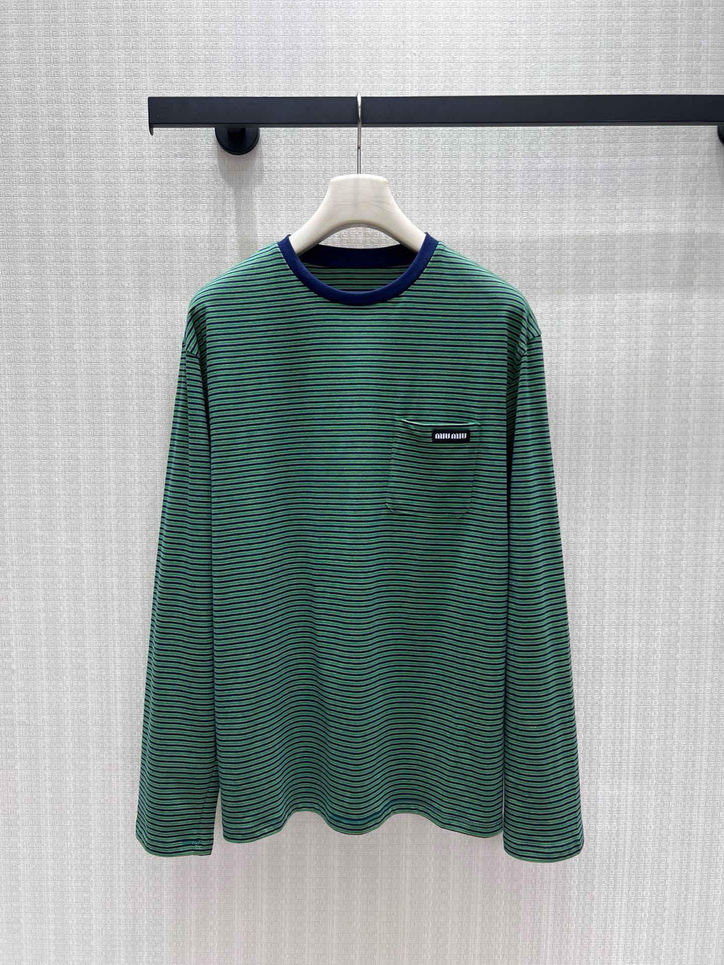 NO:954923,26 spring and summer new product Miu-** retro green striped long sleeves, contrasting navy round neck with soft layers, and fine horizontal stripes with a retro college atmosphere. The soft and skin-friendly cotton material is selected, breathable and comfortable, and the loose shoulder cut accommodates various body shapes. The small chest pocket is embellished with a brand woven label, which is low-key, refined and unobtrusive. Wear it alone to reduce age, and wear it with a suit vest.  Real shots, real shots, details,,miumiu,business suit,1986090926春夏新品 Miu-**复古绿调条纹长袖,撞色藏青圆领层次柔和,细密横条纹自带复古学院氛围.甄选软糯亲肤棉料,透气舒适,宽松落肩剪裁包容各种身形.胸前小口袋缀品牌织标,低调精致不张扬.单穿清爽减龄,外搭西装马甲氛围感十足,轻松拿捏松弛少女轻奢穿搭.现货36/38/40 实拍实拍细节,,miumiu,business suit,,Women's clothing