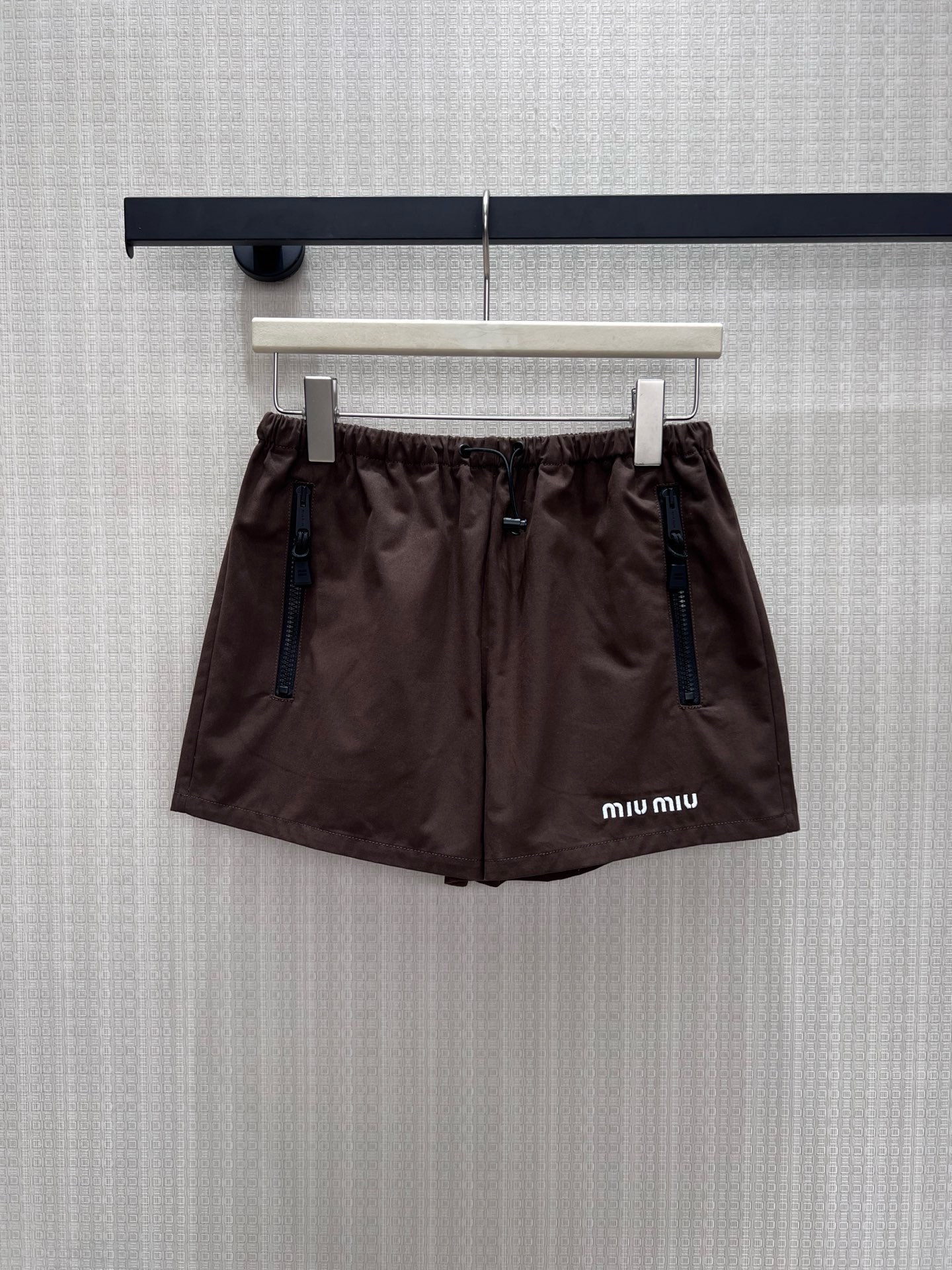 NO:954886,26 spring and summer new products  The dark brown Miu* sports suit has a relaxed silhouette with a lazy college atmosphere. The lapel zipper jacket is embellished with simple brand letters, and the cuffed sleeves are neatly hidden; the drawstring shorts of the same color are elastic and versatile, modifying the leg lines. The fabric is light and breathable, and can be used as a complete upper body set  It has a retro casual rich girl texture. It can also be worn as a separate shirt or knitted for daily travel. It is low-key and durable, showing a soft and luxurious style. In stock 46/38/40 real shot details, miumiu, shorts, jackets  & coats,shirts,1986090926春夏新品 深棕Miu*运动套装,松弛廓形自带慵懒学院氛围.翻领拉链外套点缀简约品牌字母,收口袖型利落藏肉；同色系抽绳短裤松紧百搭,修饰腿部线条.面料轻薄透气,成套上身是复古休闲富家女质感,亦可拆分单搭衬衫、针织,日常出行、低调耐看尽显柔和轻奢格调.现货46/38/40实拍细节图,,miumiu,shorts,jackets & coats,shirts,,Women's clothing
