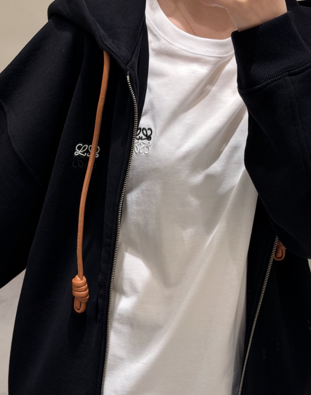 NO:954901,26 early autumn new products  Loe** zipper hooded sweatshirt, classic black, simple and elegant. The contrasting woven drawstring is unique, and the small Anagram embroidery is exquisite and low-key, highlighting the brand recognition. The loose shoulder design is free and unrestricted, and the soft terry fabric is comfortable and skin-friendly. Fully open zipper  The design is flexible to wear, casual and lazy, with both casual atmosphere and light luxury texture. It is suitable for various daily matching and can easily create a relaxed old money style. In stock sml, loewe, hoodie, sweatshirts, hats,1986090926早秋新品 Loe**拉链连帽卫衣,经典黑色简约大气.撞色编织抽绳别具巧思,小巧Anagram刺绣精致低调,彰显品牌辨识度.宽松落肩版型自在无束缚,柔软毛圈面料舒适亲肤.全开拉链设计穿搭灵活,随性慵懒,兼具休闲气息与轻奢质感,适配多元日常搭配,轻松打造松弛感老钱风造型.现货smL,,loewe,hoodie,sweatshirts,hats,,Women's clothing