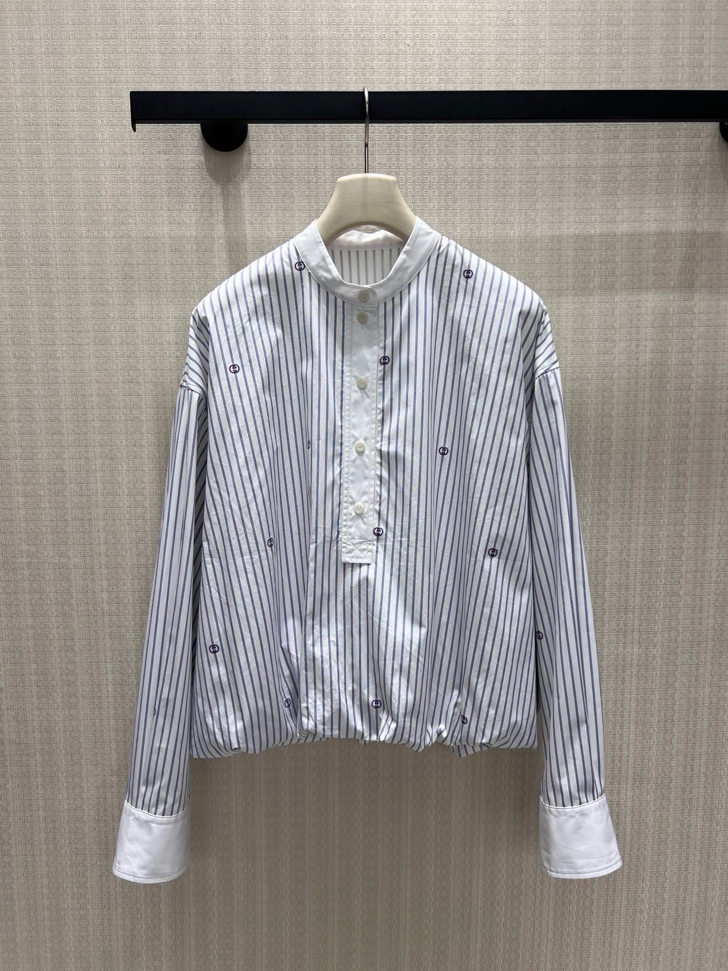 NO:955723,26 new spring and summer shirts. Light blue pinstripes bring a refreshing atmosphere, and scattered double G embroidery low-key reveals the brand heritage. The stand-up collar and half-open buttons weaken the seriousness of commuting, the pleated hem is short and the tailoring optimizes the proportion, and the contrasting wide cuffs hide exquisite ingenuity. The loose off-shoulder version accommodates all body shapes, is simple and not exaggerated, and takes into account daily casualness and light luxury texture. It can be easily adapted to skirts and trousers, showing a timeless retro elegance. In stock 36/38/40  Actual detailed pictures,,skirts,shirts,1986090926春夏新品衬衫 浅蓝细条纹自带清爽氛围感,散落双G刺绣低调释放品牌底蕴.立领半开扣弱化通勤严肃感,下摆收褶短款剪裁优化比例,撞色宽袖口暗藏精致巧思.宽松落肩版型包容各类身形,简约不浮夸,兼顾日常随性与轻奢质感,轻松适配半裙、西裤,演绎永不过时的复古优雅.现货36/38/40 实拍细节图,,skirts,shirts,,Women's clothing