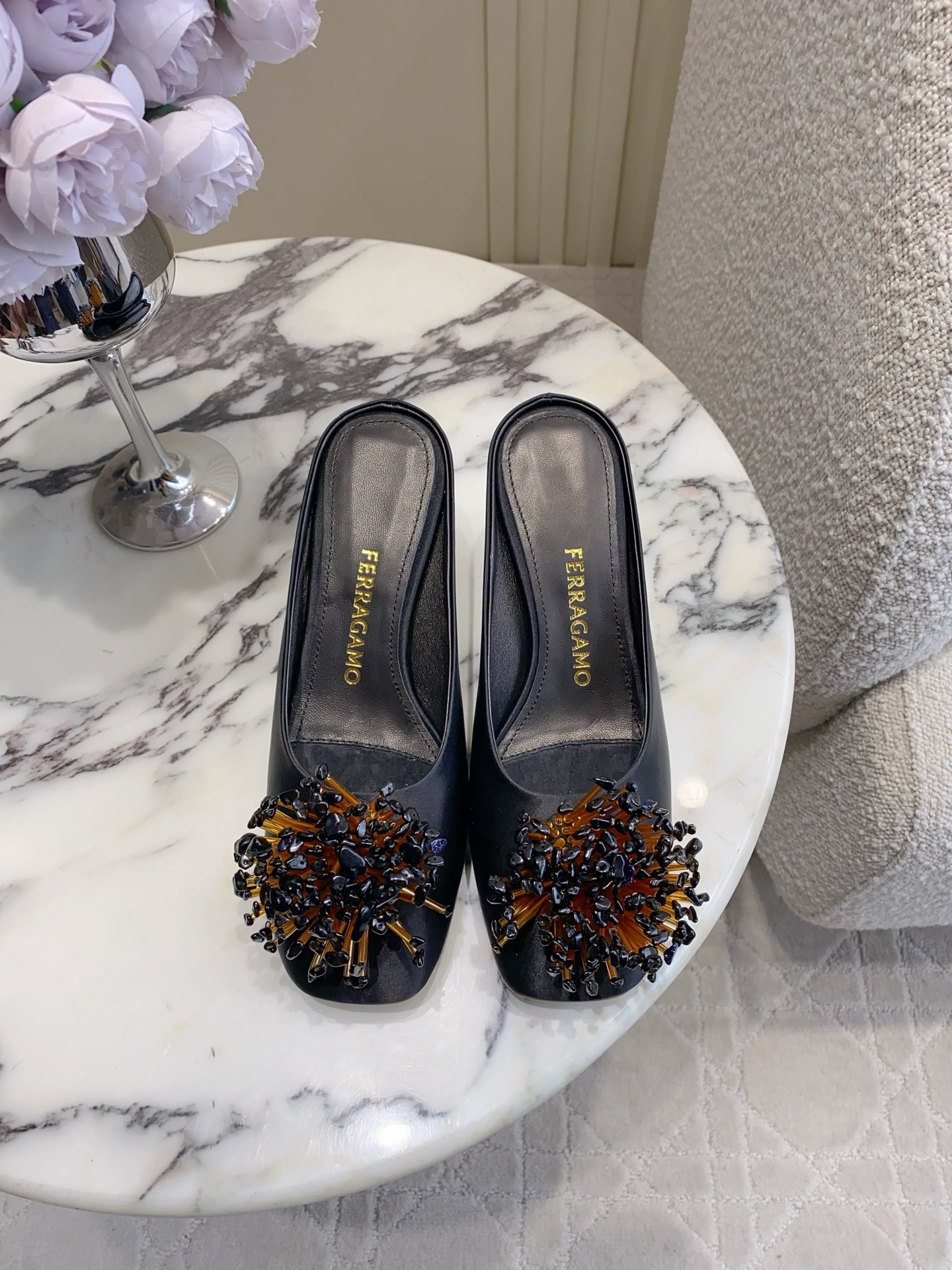 NO:876907,Ferragam's latest square-toe beaded decorative Mule half-trails are designed with a neat square-toe Mule silhouette, with clean and smooth lines. The hand-beaded decoration on the toe is the finishing touch, adding exquisite details to the simple black base. It does not pick out the shape of the foot but can give a low-key and high-end texture.  Paired with it, it can be called a 'versatile artifact' in the wardrobe. Paired with suit pants, it is a neat and elegant commuting style. Paired with a dress, it is an elegant and sophisticated style. Paired with wide-leg pants, it can be worn with a casual and relaxed high-end feel, which can easily adapt to a variety of dressing scenes. Imported silk upper, lambskin lining, sheepskin foot pads, printed Ferragamo leather outsole, size 35-39 (40, 41, 42 sizes are not returnable for customization)  Heel height 6cm, single shoes, ferragamo, ferragamo, skirts, business suit, sheepskin, real silk, Leather soles19860909Ferragam*新款方头串珠装饰穆勒半拖 设计上采用利落的方头穆勒版型,线条干净流畅,鞋头点缀的手工串珠装饰是点睛之笔,在简约的黑色基底上增添了精致的细节感,不挑脚型的同时又能穿出低调又高级的质感. 搭配上堪称衣柜里的“百搭神器”,搭配西装裤是利落贵气的通勤风,搭配连衣裙是优雅精致的轻熟风,搭配阔腿裤又能穿出随性松弛的高级感,轻松适配多种穿搭场景. 鞋面进口真丝 内里小羊皮 垫脚羊皮 大底印刷菲拉格慕纹路真皮大底 size35-39码（40、41、42码定制不退换） 跟高6cm,单鞋,ferragamo,ferragamo,skirts,business suit,sheepskin,real silk,Leather soles,Women's Shoes