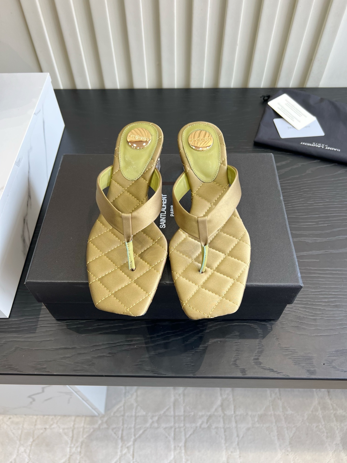 NO:901538,YSL Yang Shulin's satin flip-flops are so beautiful that they are speechless. Who knows how high-end these crystal and flip-flops are?  The smooth satin fabric is paired with classic diamond quilting, the square toe thong design makes your feet slimmer, and the transparent square heel is stable when walking. The four colors are all aesthetically pleasing, and the metal round mark details are full of sophistication. It is suitable for commuting with suits and holiday skirts. It is gentle and a little sexy, and it is an artifact of summer atmosphere~ The light and luxurious texture can be photographed easily, and it is a must-have in fashionable girls' shoe cabinets!  Silk upper, sheepskin lining, Italian leather outsole, heel height 4.5cm, size 35-39 (40 41 42 customized), split-toe shoes, saint laurent, skirts, business suit, sheepskin, real silk, Leather soles19860909YSL杨树林 缎面夹脚凉拖美到失语 谁懂这双水晶跟人字拖的高级感！ 柔滑缎面搭配经典菱格绗缝,方头夹趾设计超显脚瘦,透明方跟走路稳不累脚. 四个配色都戳中审美,金属圆标细节拉满精致度. 通勤配西装、度假搭小裙子都适配,温柔又带点小性感,夏日氛围感神器～ 轻奢质感随手拍都出片,时髦女生鞋柜必入款！ 鞋面真丝 内里羊皮 意大利真皮大底 跟高4.5cm 尺码35-39（40 41 42定做）,分趾鞋,saint laurent,skirts,business suit,sheepskin,real silk,Leather soles,Women's Shoes
