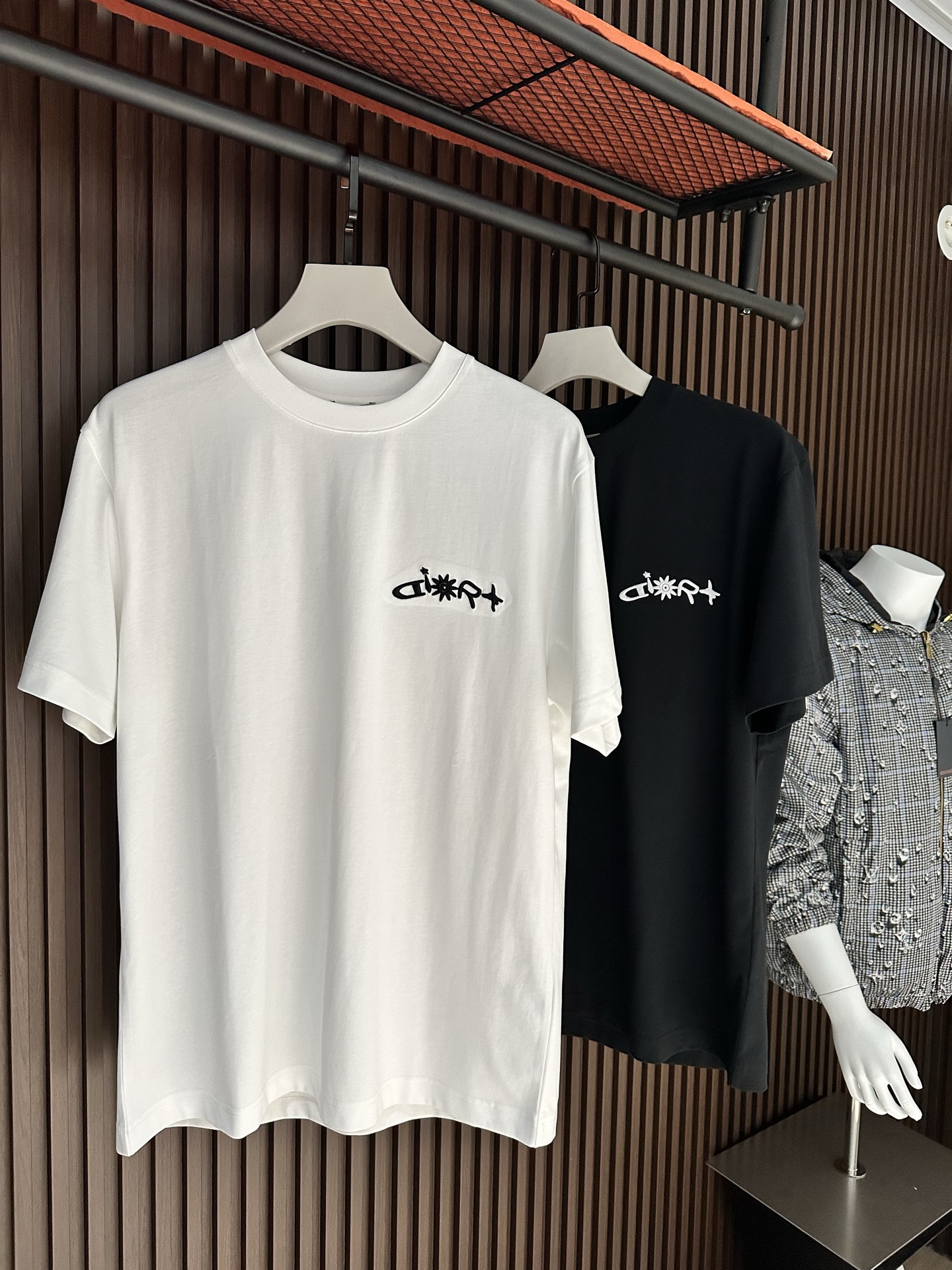 NO:904121,[New Product] Channel boutique creates a contemporary atmosphere. 2026SS new summer product Di*r logo embroidered short-sleeved T-shirt has superb fashion charm and unique artistic atmosphere. The densely spun knitted cotton fabric is supplied by customers. The delicate and orderly knitting process retains the original soft texture, which is refreshing and refreshing. The texture of the fabric is the most powerful proof.  The new exquisite embroidery brand logo expresses the fusion between agility and unique ingenuity. The fine stitching technology, ribbed round neck and V collar top thread create the classic 'Forger' extension of fashion inspiration. Color: Black/White Size S/M/L/XL/2XL S Shoulder Width 44 Bust Length 66 Sleeve Length 22 M Shoulder Width 45 Bust 104 Length 68 Sleeve Length 23  L Shoulder width 46 Bust 108 Clothes length 70 Sleeve length 2419860909【新品】渠道精品缔造当代气息.2026SS夏季新品 Di*r 标识刺绣短袖T恤 高超的时尚魅力风范,特立独行的艺术气息. 客供密纺针织棉面料,细腻有序的针织工艺保留了最初的那份柔软质感,清肤透爽,工艺考究,织面的质感就是最有力的证明. 全新精美刺绣品牌标识表达了灵动之间的融合感,别具匠心.缝合技术精细度,罗纹圆领搭配 V 领缉面线成就经典的“锻造者”延伸时尚灵感. 颜色:黑色/白色 尺码S/M/L/XL/2XL S肩宽44胸围衣长66袖长22 M肩宽45胸围104衣长68袖长23 L肩宽46胸围108衣长70袖长24 XL肩宽47胸围112衣长72袖长25 XXL肩宽48胸围116衣长74袖长26,,T-shirt,tees，t-shirt,,Men's clothing