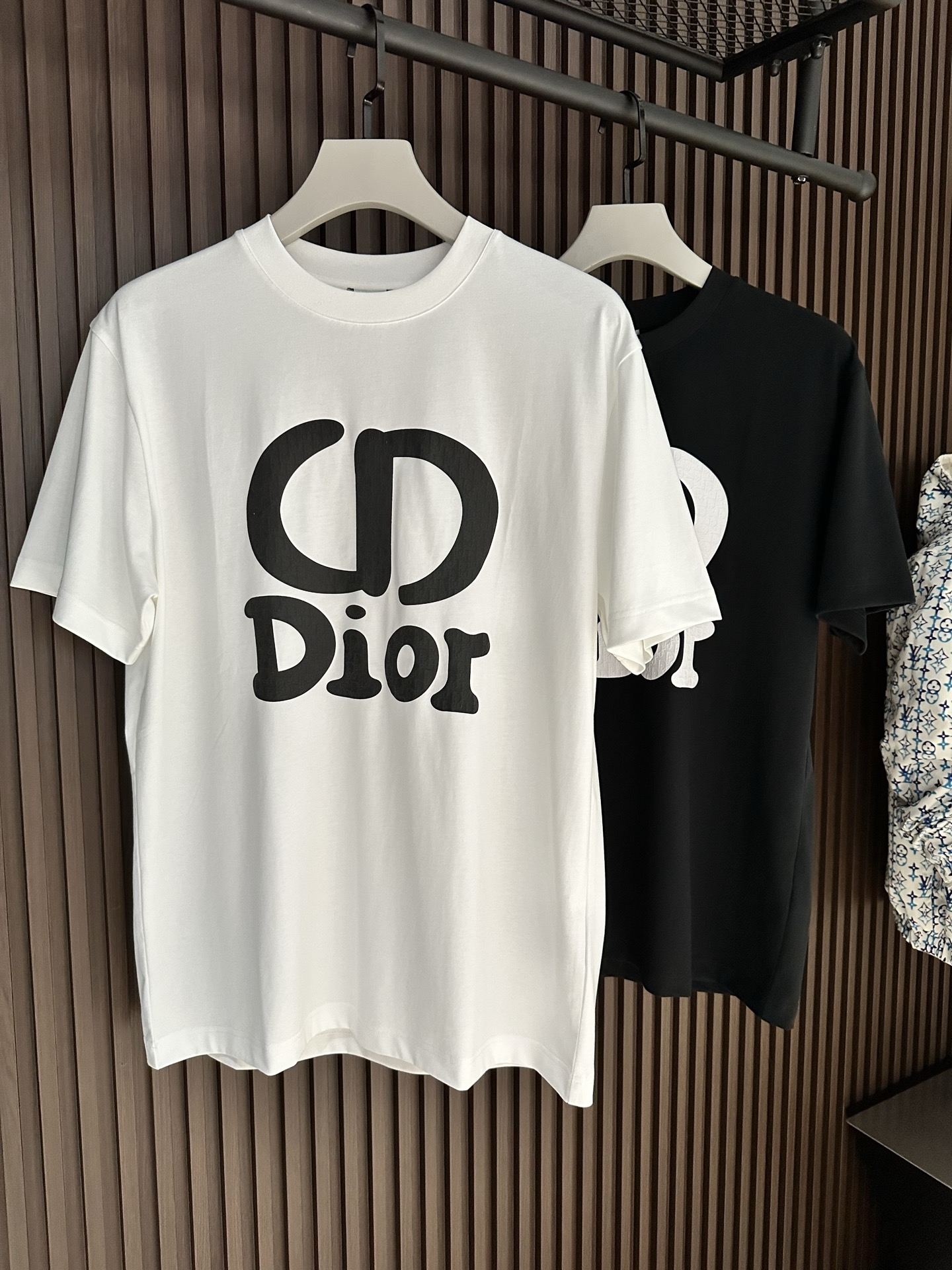 NO:904053,[New Product] 2026SS new summer product Di*r short-sleeved T-shirt with printed letter logo. It has superb fashion charm and unique artistic atmosphere. The densely woven knitted cotton fabric is supplied by customers. The delicate and orderly knitting process retains the original soft texture, which is refreshing and refreshing. The texture of the fabric is the most powerful proof.  The new exquisite brand logo expresses the fusion between agility and unique ingenuity. The fine stitching technology, ribbed round neck and V collar top thread create the classic 'Forger' extension of fashion inspiration. Color: White/Black Size S/M/L/XL/2XL S Shoulder Width 44 Bust Length 66 Sleeve Length 22 M Shoulder Width 45 Bust 104 Length 68 Sleeve Length 23  L Shoulder width 46 Bust 108 Clothes length 70 Sleeve length 2419860909【新品】 2026SS夏季新品 Di*r 印花字母标识短袖T恤 高超的时尚魅力风范,特立独行的艺术气息. 客供密纺针织棉面料,细腻有序的针织工艺保留了最初的那份柔软质感,清肤透爽,工艺考究,织面的质感就是最有力的证明. 全新精美品牌标识表达了灵动之间的融合感,别具匠心.缝合技术精细度,罗纹圆领搭配 V 领缉面线成就经典的“锻造者”延伸时尚灵感. 颜色:白色/黑色 尺码S/M/L/XL/2XL S肩宽44胸围衣长66袖长22 M肩宽45胸围104衣长68袖长23 L肩宽46胸围108衣长70袖长24 XL肩宽47胸围112衣长72袖长25 XXL肩宽48胸围116衣长74袖长26,,T-shirt,tees，t-shirt,,Men's clothing