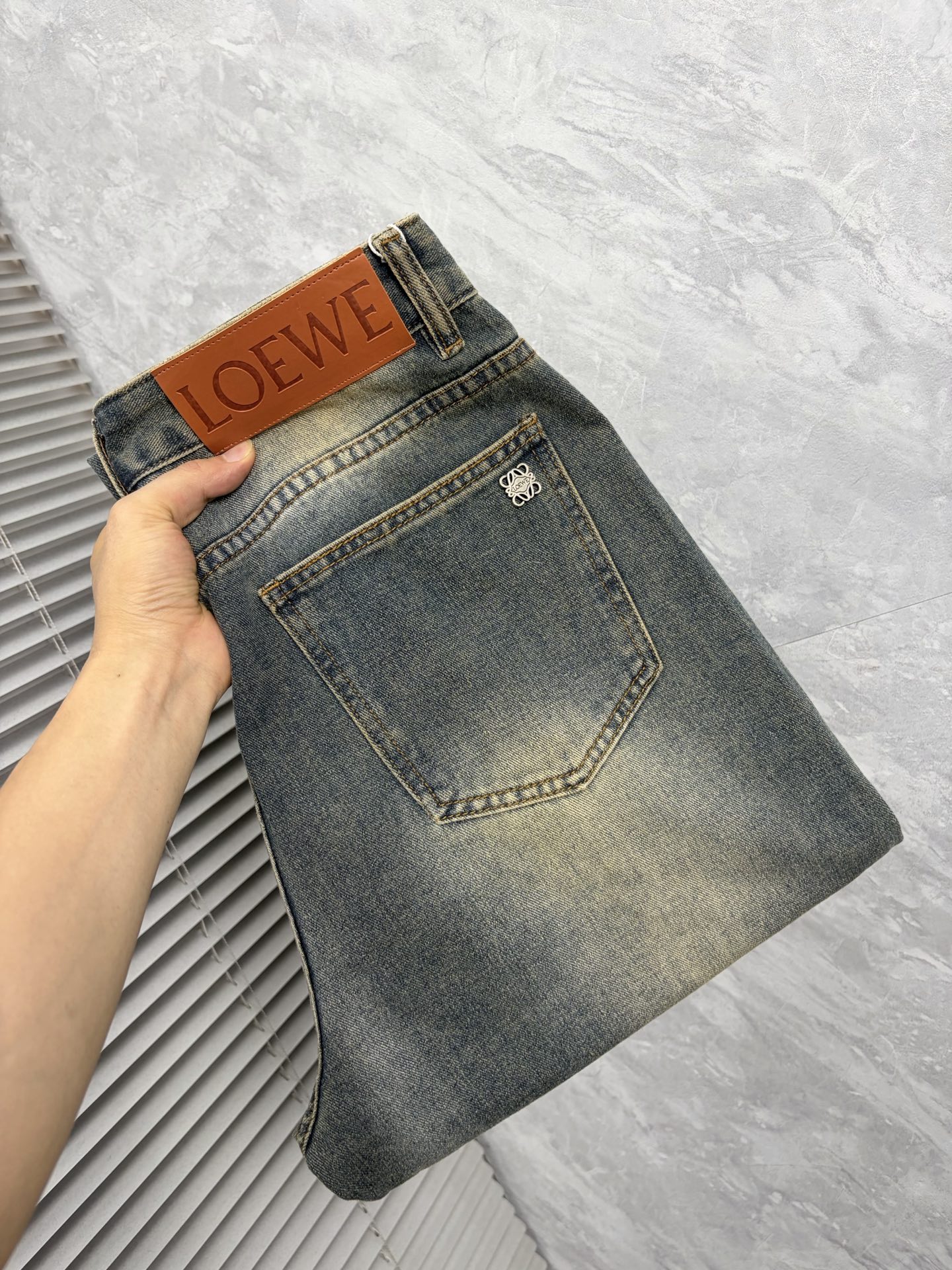NO:876954,Luo Yiwei's 26 autumn and winter men's denim large hem jeans, official album and poster wear style!  High-grade imported denim raw color fabrics are supplied to customers, and the pure 13oz denim fabrics from Okayama, Japan are specially selected. Heavy-duty environmentally friendly plant enzyme washing process is used. The texture has a light retro color, which is quite beautiful and is very suitable for autumn and winter color matching. The fabric is soft and delicate after washing, but has strong bones and a slight stretch, providing an excellent comfortable experience. There is no damage from any technological elements throughout the body, retaining the purest tannin color!  The details throughout the body are perfect, exquisite and sophisticated. The latest leather label on the waist highlights the brand's characteristics. The hardware accessories, leather label and wiring all reflect the craftsmanship!  The silhouette is perfectly tailored and has excellent butt lift and slimming effect. It can be easily matched with any top in the wardrobe. It has wide compatibility and is suitable for various daily wear. The upper body is full of style. It is a must-have trousers for those who are obsessed with quality control and 1V!  Size 29-38 (not 35.37),,loewe,jeans,19860909罗意威 26秋冬男士丹宁大裤脚牛仔裤,官宣画册海报穿搭款！ 客供高级进口的丹宁原色面料,特选日本冈山纯正13oz 盎司牛仔布料,重磅环保植物酵素水洗工艺,肌理有着淡淡的复古色彩,相当漂亮,极符合秋冬的配色,面料经过水洗后柔软细腻,但筋骨感极强,且略带弹力,提供了绝佳的舒适体验,通身无任何工艺元素破坏,保留了最纯粹的丹宁本色！通身细节完美如斯,精湛且考究,最新的腰部皮标彰显了品牌特质,五金配件、皮标、走线无不体现出匠心工艺！版型剪裁完美,提臀修身效果绝佳,可轻松横扫衣橱任何的上装搭配,兼容性广泛,满足于日常各种穿搭,上身型款十足,于品质控及1V迷控者必入型裤装！ 尺码29—38（没35.37）,,loewe,jeans,,Men's clothing