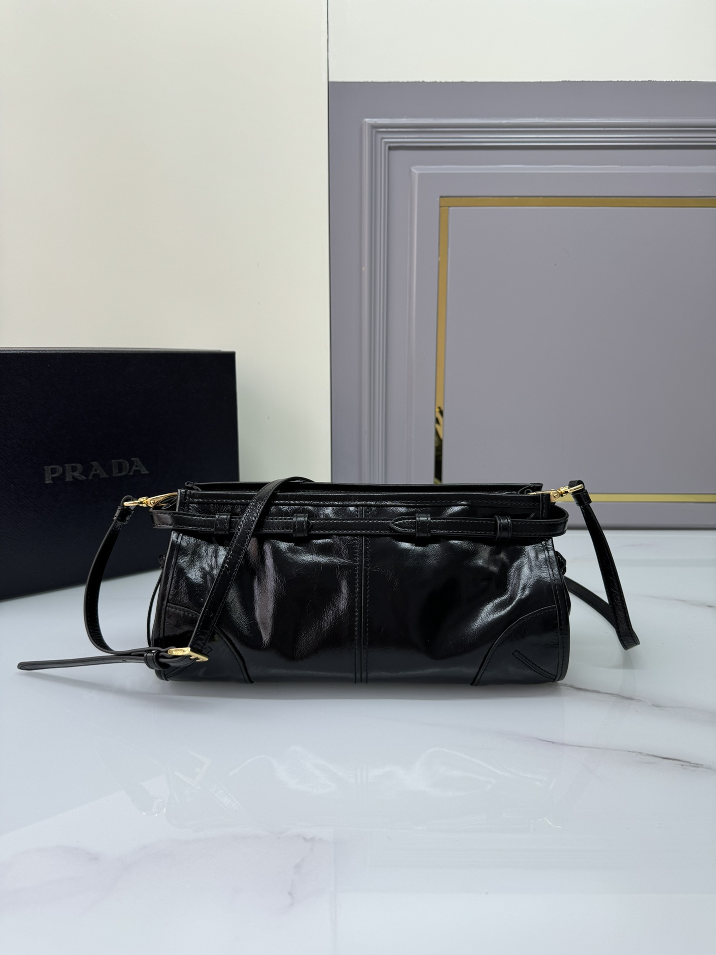Prada 油亮的色泽散发出古典气息 配有一条可拆卸调节的长肩带 方便肩背和斜跨 容量空间非常大