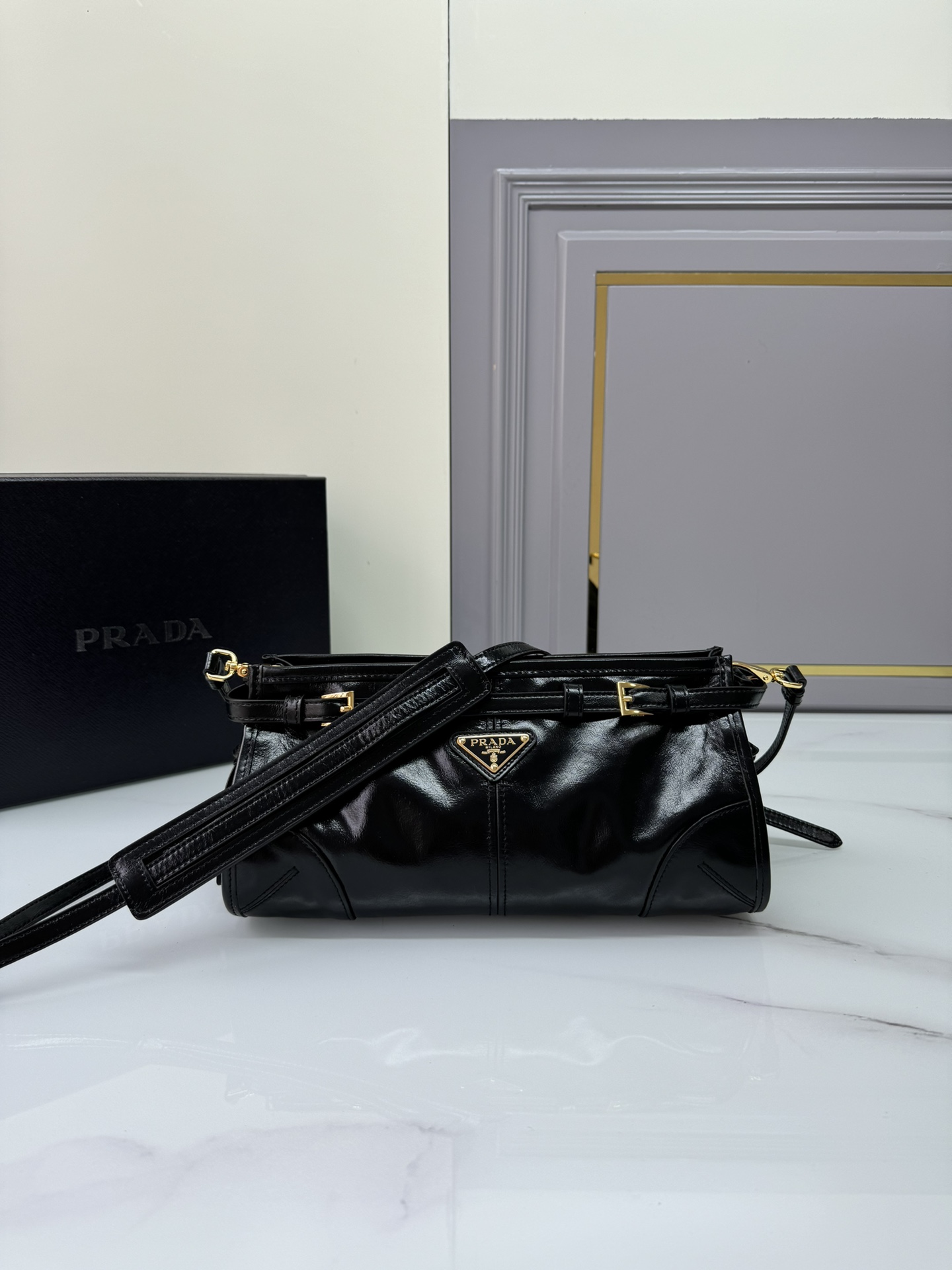 Prada 油亮的色泽散发出古典气息 配有一条可拆卸调节的长肩带 方便肩背和斜跨 容量空间非常大