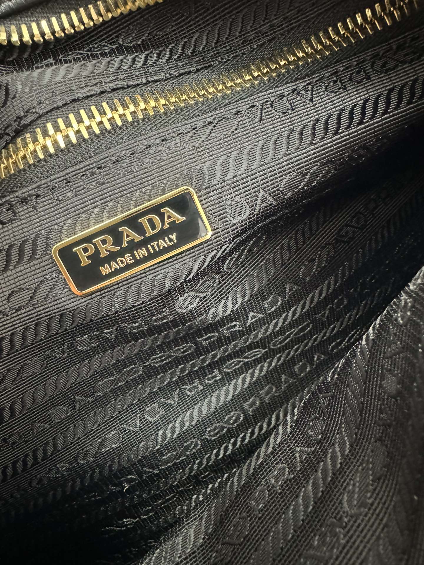 Prada 油亮的色泽散发出古典气息 配有一条可拆卸调节的长肩带 方便肩背和斜跨 容量空间非常大