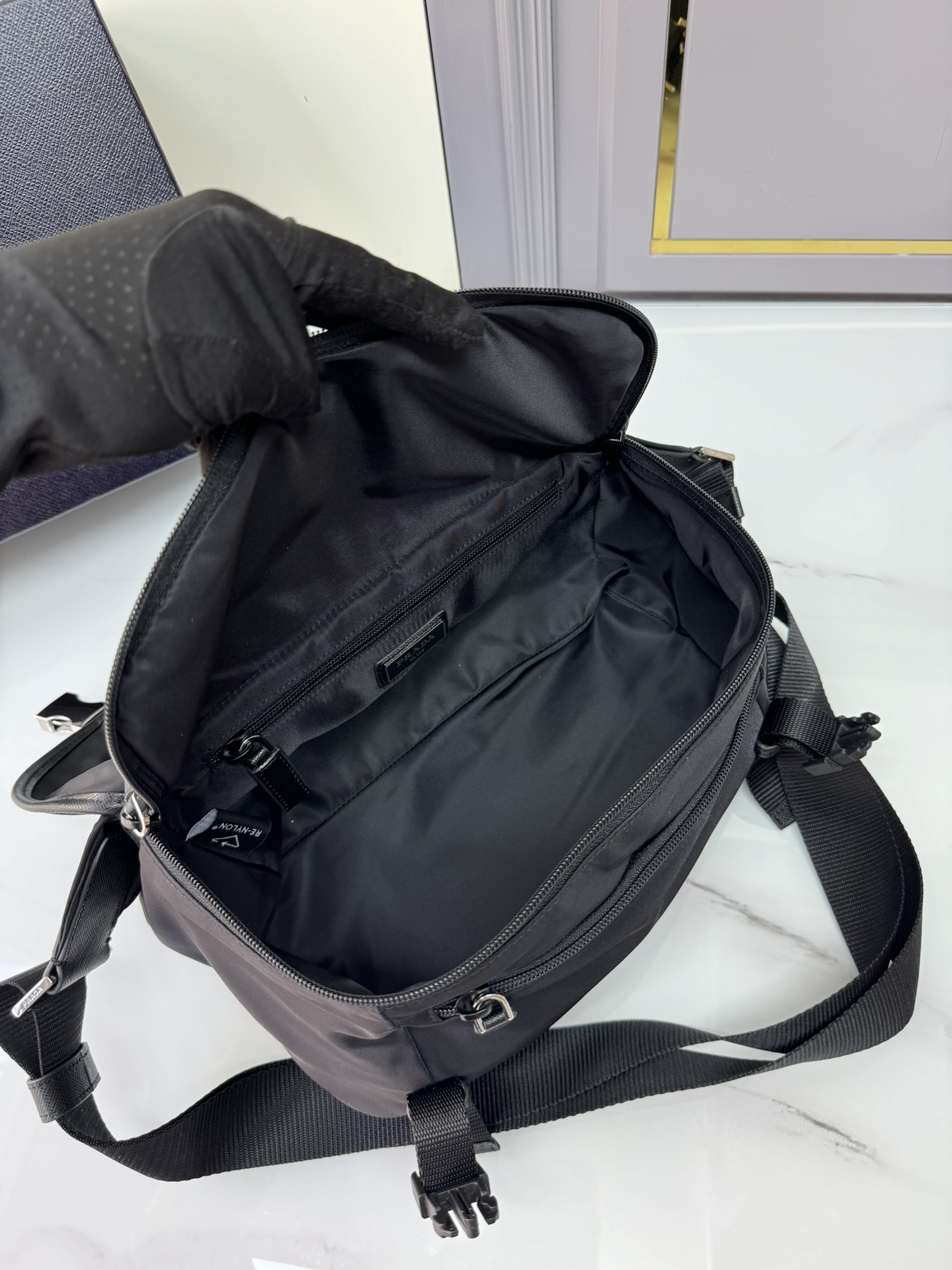 经典邮差包2VH994升级版这款翻盖式单肩包采用尼龙和Saffiano皮革等标志性的P家材质制作单肩包配