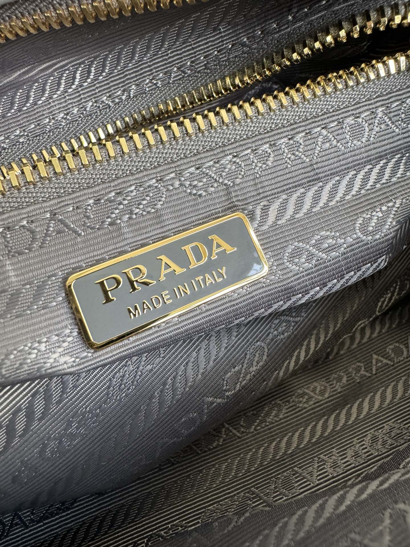Prada 油亮的色泽散发出古典气息 配有一条可拆卸调节的长肩带 方便肩背和斜跨 容量空间非常大