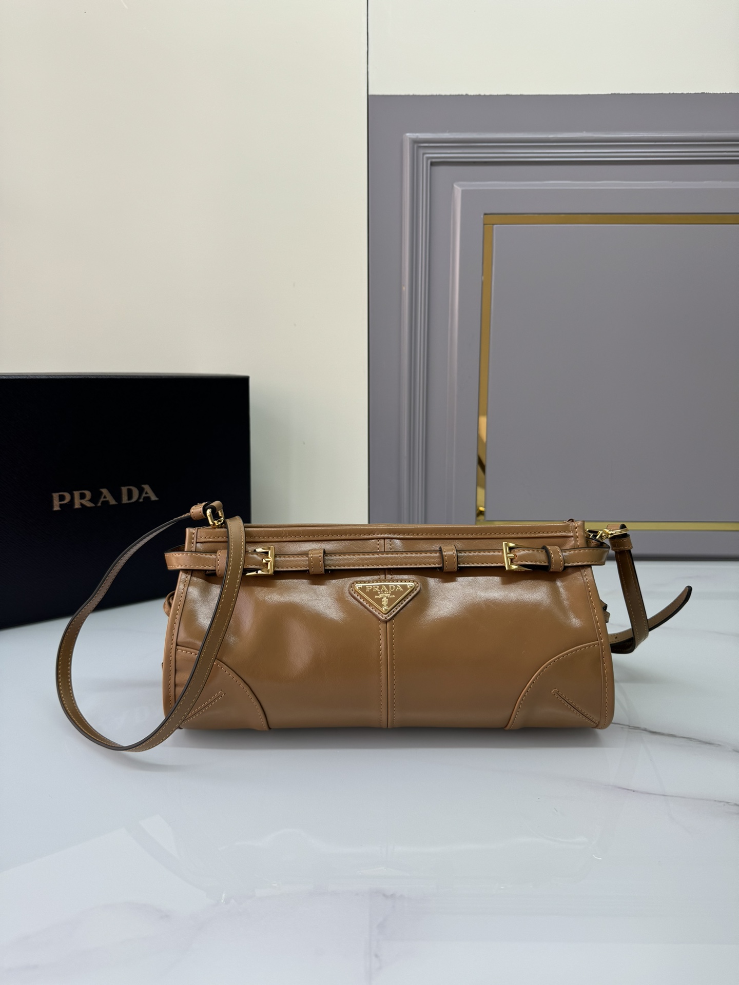 Prada 油亮的色泽散发出古典气息 配有一条可拆卸调节的长肩带 方便肩背和斜跨 容量空间非常大