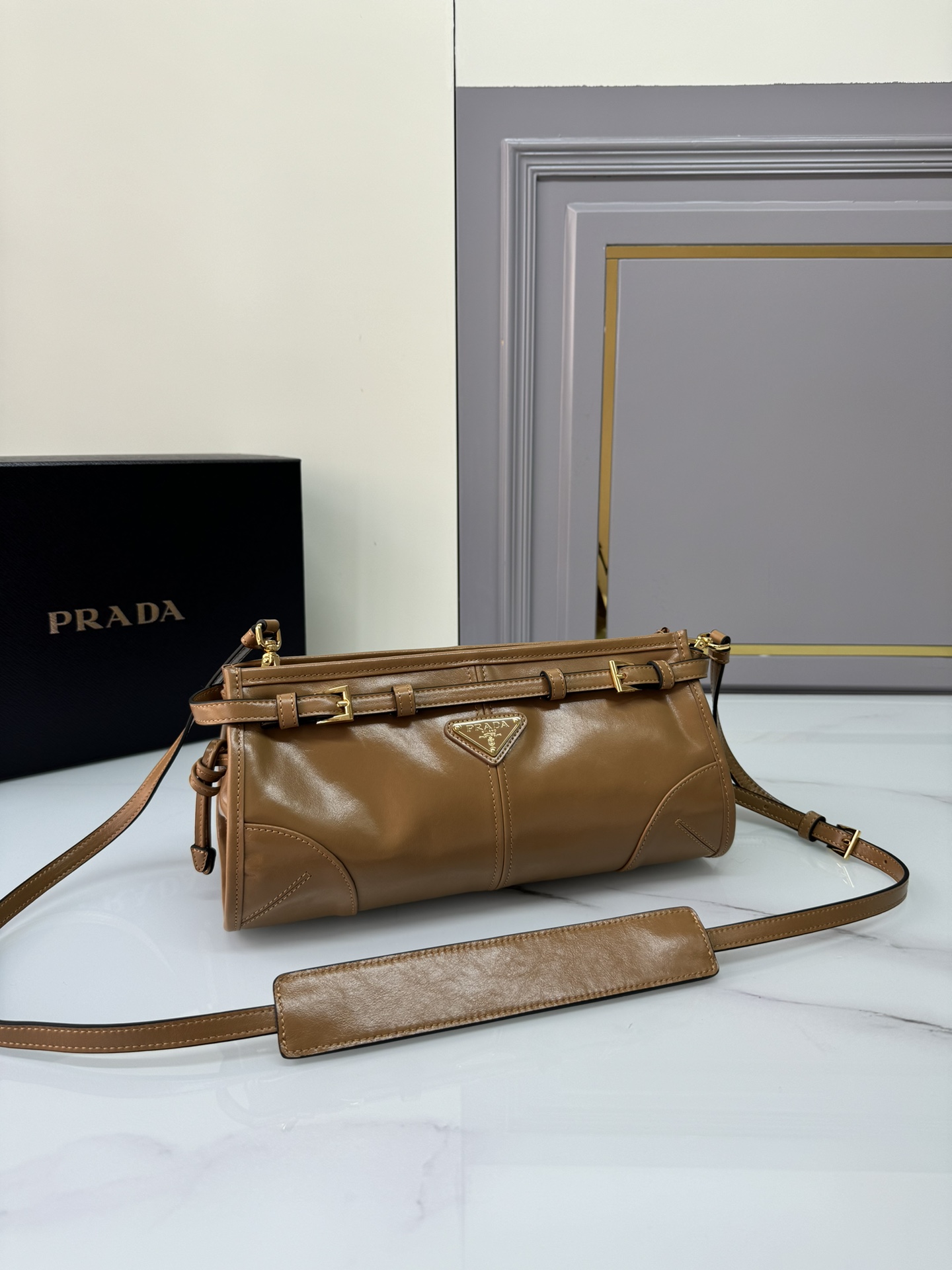 Prada 油亮的色泽散发出古典气息 配有一条可拆卸调节的长肩带 方便肩背和斜跨 容量空间非常大