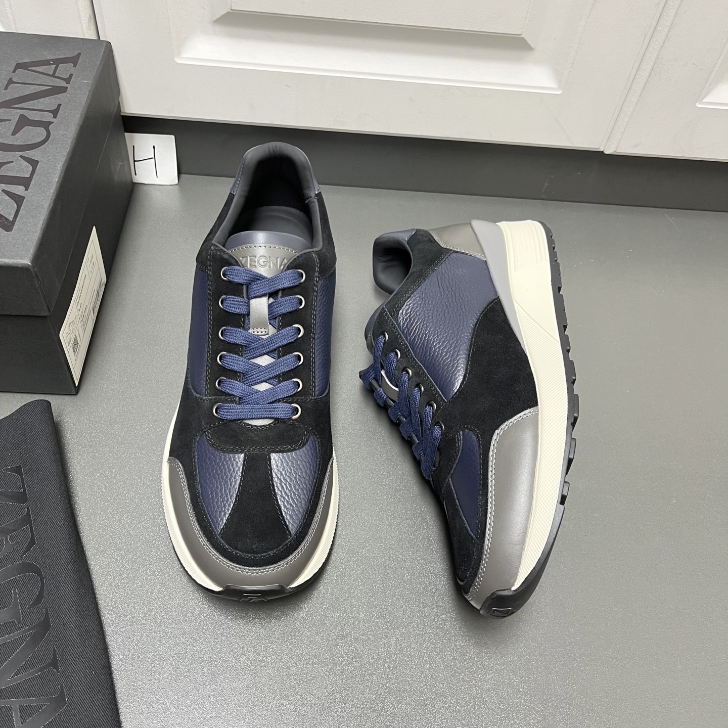 NO:357685,Zegna New men's low-top casual sneakers are shipped. This men's shoes are made of imported calfskin, nylon fabric and suede cowhide leather. The three-dimensional geometric segmentation layering feel, rich craftsmanship details, and the clean and simple design lines are very versatile. The cowhide inner lining is equipped with embossed logo cowhide feet, elegant and personalized, anti-slip, wear-resistant and durable two-color rubber outsole, which is durable and does not fall off the bottom. The tongue is decorated with logo logo. It is a very good trendy item for men's casual sneakers, worth having! H leather shoes size: 39/40/41/42/43/44 Black and blue original box packaging + dust bag C2050053,,zegna,sneakers,cowhide19860909Zegna杰尼亚 新款男士低帮休闲运动鞋出货 这款男鞋由进口小牛皮、尼龙织物及绒面牛皮革拼接打造,立体几何分割层次感,丰富的工艺细节,干净简洁的设计线条非常百搭,牛皮内里标配压纹徽标牛皮脚垫,优雅个性,防滑耐磨又耐用的双色橡胶大底,耐穿不掉底,鞋舌饰有logo标识,非常不错的男士休闲运动鞋潮流单品,值得拥有! H皮鞋码数:39/40/41/42/43/44 黑蓝色 原盒包装+防尘袋 C2050053,,zegna,sneakers,cowhide,Men's shoes