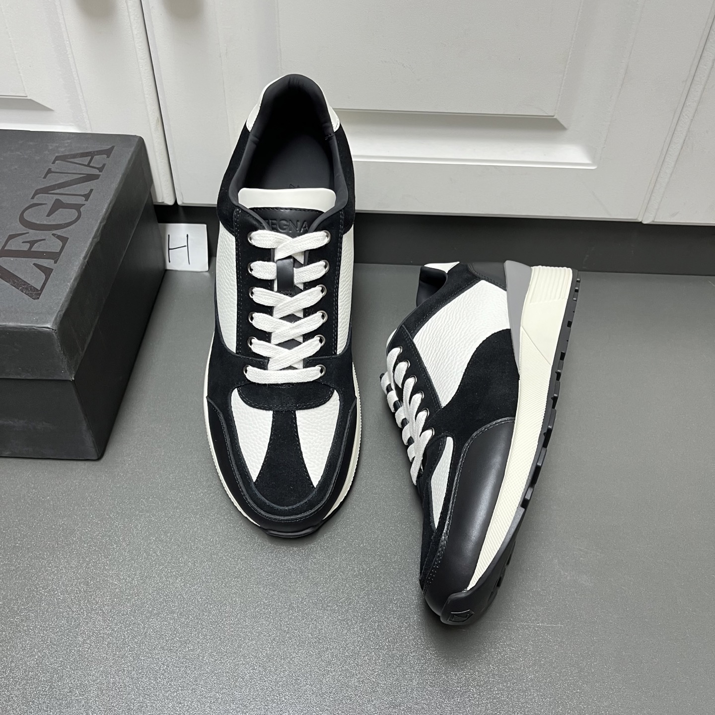 NO:639688,Zegna Zegna's new men's low-top casual sports shoes are shipped. This men's shoe is made of imported calfskin, nylon fabric and suede cow leather. It has a three-dimensional geometric segmentation layering, rich craftsmanship details, and clean and concise design lines. It is very versatile. The cowhide lining comes standard with embossed logo cowhide foot pads. It is elegant and individual. The non-slip, wear-resistant and durable two-color rubber outsole is durable and does not fall off. The tongue is decorated with a logo. It is a very good fashion item for men's casual sports shoes and is worth owning!  H leather shoe size: 39/40/41/42/43/44 white and black, original box packaging + dust bag, zegna, sneakers, cowhide19860909Zegna杰尼亚 新款男士低帮休闲运动鞋出货 这款男鞋由进口小牛皮、尼龙织物及绒面牛皮革拼接打造,立体几何分割层次感,丰富的工艺细节,干净简洁的设计线条非常百搭,牛皮内里标配压纹徽标牛皮脚垫,优雅个性,防滑耐磨又耐用的双色橡胶大底,耐穿不掉底,鞋舌饰有logo标识,非常不错的男士休闲运动鞋潮流单品,值得拥有! H皮鞋码数:39/40/41/42/43/44 白黑拼 原盒包装+防尘袋,,zegna,sneakers,cowhide,Men's shoes