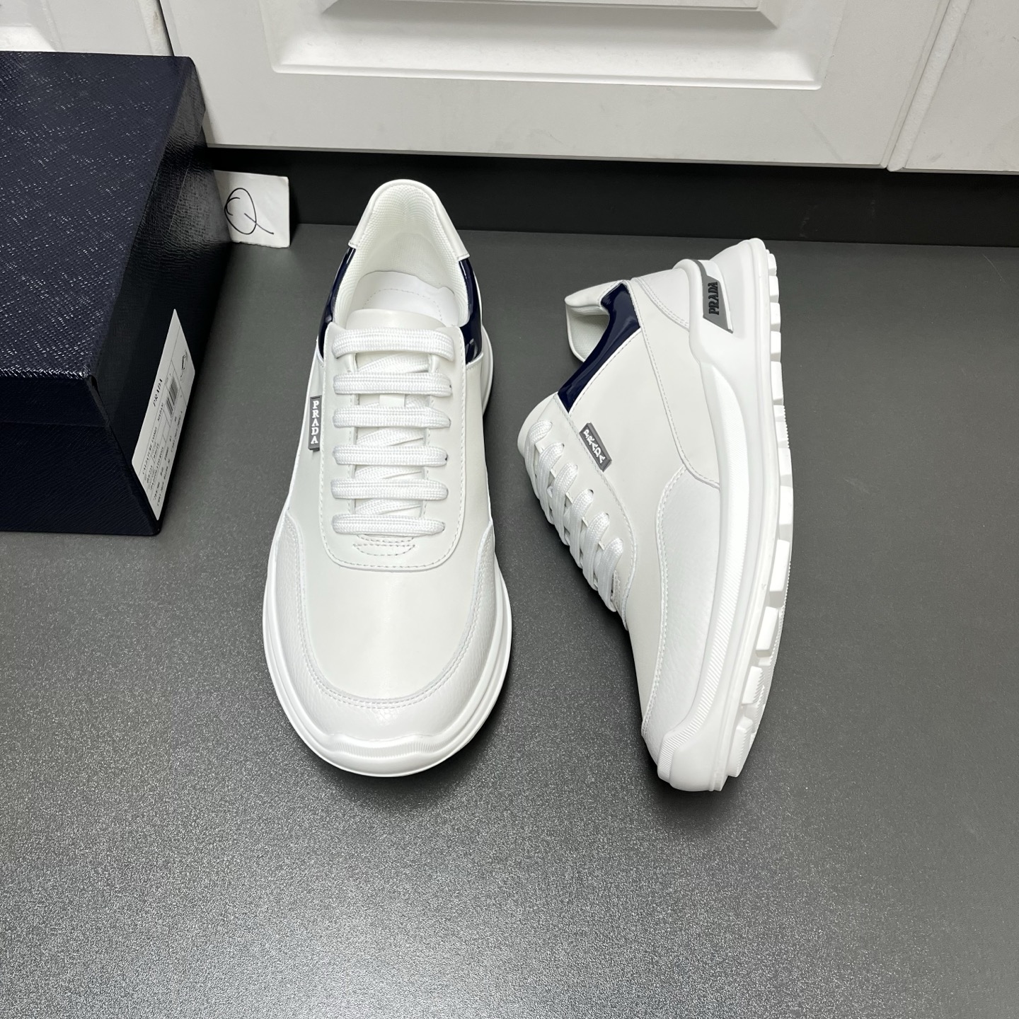 NO:711659,Prada men's new + lace-up leather sneakers are shipped. This model is made of imported calfskin spliced ​​with grained cow leather uppers, bright leather embellishments on the sides, and a rubber label with the brand's logo on the outside. It is inspired by the classic aesthetic concept. The rubber sole is decorated with contrasting details on the heel, fabric lining, cowhide collar embellishment, logo cowhide foot pads, breathable, wear-resistant and non-slip, fashionable and comfortable!  Q leather shoe size: 39/40/41/42/43/44 white original box packaging, prada, prada, sneakers, cowhide19860909Prada普拉达 男士新款+系带皮革运动鞋出货 这款采用进口小牛皮拼接粒面牛皮革鞋面,鞋侧亮面皮革点缀,包裹,外侧饰有品牌字母logo橡胶标签,灵感源自经典美学理念.橡胶鞋底后跟饰有撞色细节,织物内里,牛皮鞋口点缀,徽标牛皮垫脚,透气耐磨防滑,上脚时尚舒适！ Q皮鞋尺码:39/40/41/42/43/44 白色 原盒包装,,prada,prada,sneakers,cowhide,Men's shoes