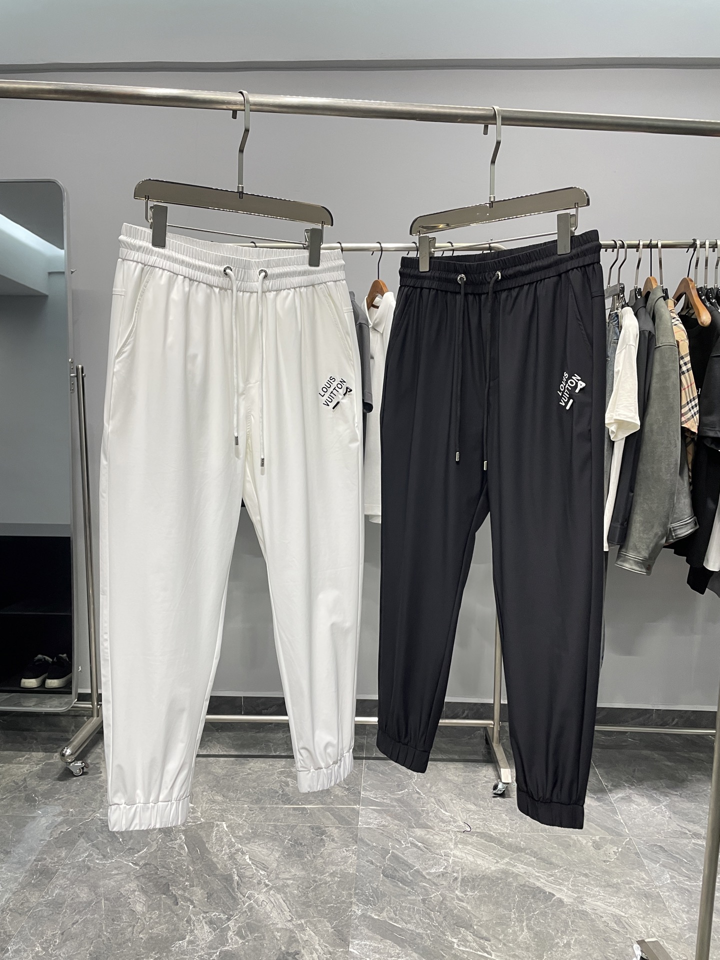 NO:141314,1V25SS spring and summer new thin technology cloth drawstring ties, classic pin letter logo embroidered sports and casual trousers for men!  Trading companies have sparse channels and are on sale on the leading official website!  V Home's new jogging back pants are a choice that combines comfort, fashion and quality!  It is not only a practical item in your wardrobe, but also a way for you to show yourself and pursue your quality of life!  These pants are light and delicate in texture, and the touch is silky and comfortable, allowing you to enjoy comfort while also feeling the excellence of quality!  It feels very touching, as if every touch is a gentle care for the skin!  The classic letter logo embroidery on the front and back pockets is simple but not simple, full of luxury!  This is not only a brand recognition, but also a reflection of a life attitude!  The hardware zipper accessories engraved with the brand logo are exquisite and exquisite in details. Whether it is visual or touch, it makes people feel the brand's attentiveness!  Drawstring elastic waist, ribbed splicing tie design, combined with three-dimensional splicing cutting techniques, makes this sweatpants both have a casual style and a sporty vitality!  Whether it is a leisurely weekend or a busy weekday, you can easily control it. When you wear it, you will be handsome and stylish, showing your personality charm!  Color white, black Size M-3XL Size reference M size waist 72 hip circumference 104 thigh circumference 60 thigh circumference 99 L size waist circumference 76 hip circumference 108 thigh circumference 62 thigh circumference 100 XL size waist circumference 80 hip circumference 112 thigh circumference 64 thigh circumference 101 2XL size waist circumference 84 hip circumference 116 thigh circumference 66 thigh circumference 102 3XL size waist circumference 88 hip circumference 120 thigh circumference 68 thigh circumference 10308,,alexander wang198609091V25SS春夏新款轻薄科技布抽绳束脚卫裤,男士经典别针字母标识刺绣运动休闲长裤！贸易公司渠道稀出,领先官网发售！V家新款慢跑卫裤是一款兼具舒适、时尚和品质的选择！它不仅是你衣橱中的一件实用单品,更是你展现自我、追求生活品质的一种方式！ 这款裤子质地轻薄细腻,触感丝滑舒爽,让你在享受舒适的同时,也能感受到品质的卓越！其触感十足,仿佛每一次触摸都是对肌肤的温柔呵护！前幅与后口袋上的经典字母标识Logo刺绣,简约而不简单,充满了奢华的气息！这不仅是一种品牌的辨识度,更是一种生活态度的体现！刻有品牌Logo的五金拉链辅料,细节精致考究,无论是从视觉还是触感上,都让人感受到品牌的用心之处！抽绳松紧裤腰,罗纹拼接束口设计,结合立体拼接式剪裁手法,让这款卫裤既具有休闲的风格,又不失运动的活力！无论是悠闲的周末,还是忙碌的工作日,都能轻松驾驭,穿上它你将帅气有型,尽显个性魅力！ 颜色白色、黑色 尺码M-3XL 尺寸参考 M码腰围72臀围104大腿围60裤长99 L码腰围76臀围108大腿围62裤长100 XL码腰围80臀围112大腿围64裤长101 2XL码腰围84臀围116大腿围66裤长102 3XL码腰围88臀围120大腿围68裤长10308,,alexander wang,Men's clothing