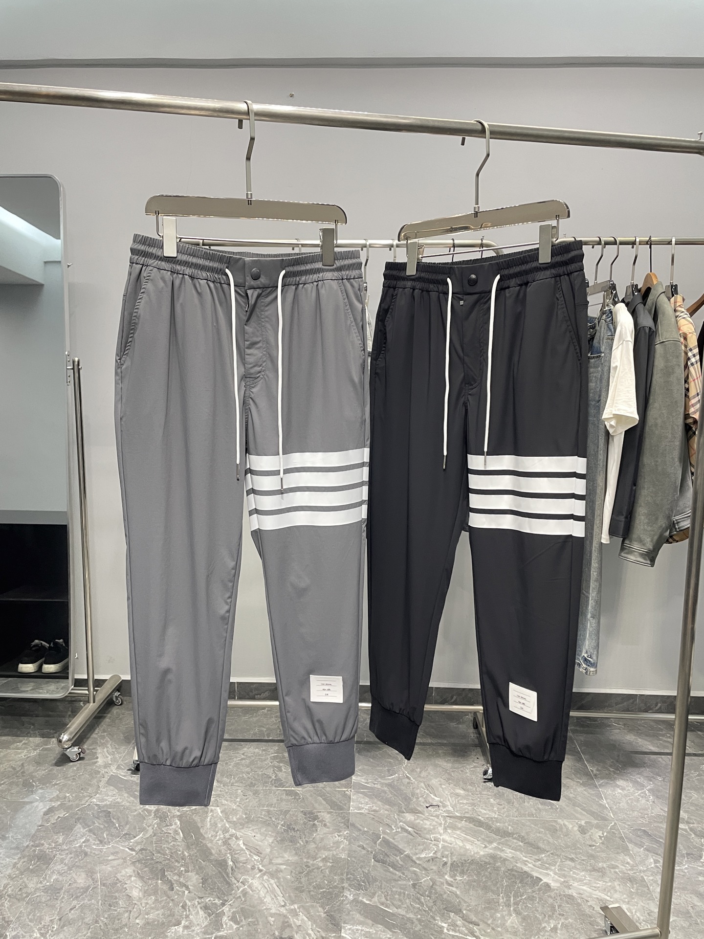 NO:141300,TB25SS spring and summer new lightweight woven fabric drawstring ties, men's classic four-bar logo printed sports and casual trousers five-point pants!  Trading companies have sparse channels and are on sale on the leading official website!  A trendy item that combines fashion and functions is versatile and not picky. Whether it is matched with a simple T-shirt, shirt, or a trendy sweatshirt or jacket, it can be easily controlled, showing different styles and charms!  The fabric is made of customized technology woven materials for customer supply. It not only has a thin, silky and elastic touch, but also fits like a second layer of skin, but also brings unprecedented breathable and comfortable feeling in the hot summer!  Every time I wear it, it feels like I am in the breeze, allowing my skin to breathe freely, enjoying freedom and comfort!  The classic four-bar pattern print on the legs of the trouser is vividly displayed. This iconic design not only demonstrates the unique charm of the brand, but also forms a strong visual impact, making it unforgettable at a glance!  At the same time, the trouser legs are cleverly combined with exquisite labels and three-color woven label decorations. These elements complement each other and form the unique logo of the TB brand, making people stand out easily among the crowd!  The details are also perfect. The zipper opening and closing design not only makes it easy to put on and take off, but also invisibly enhances the overall texture and grade!  The elastic waist design of drawstring fully takes into account the needs of different figures. Whether it is tight or loose, it can be easily adjusted, allowing you to switch between comfort and fashion freely!  The trouser legs are made of ribbed splicing and tie-up design. This design not only cleverly modifys the leg shape, making the legs look longer and straighter, but also visually lengthens the overall proportion, allowing you to instantly have the déjà vu!  Color gray, black Size M-3XL Size reference M size waist 74 hip circumference 100 thigh circumference 56 thigh circumference 94 L size waist 78 hip circumference 104 thigh circumference 58 thigh circumference 95 XL size waist 82 hip circumference 108 thigh circumference 60 thigh circumference 96 2XL size waist 86 hip circumference 112 thigh circumference 62 thigh circumference 97 3XL size waist circumference 90 thigh circumference 116 thigh circumference 64 thigh circumference 9808, hoodie, sweatshirts, jackets & coats,shirts,tees, t-shirt,alexander wang19860909TB25SS春夏新款轻薄梭织面料抽绳束脚卫裤,男士经典四条杠标识印花运动休闲长裤五分裤！贸易公司渠道稀出,领先官网发售！一款集时尚与功能于一身的潮流单品,百搭不挑人.无论是搭配简约的T恤、衬衫,还是潮流的卫衣、外套,都能轻松驾驭,展现出不同的风格与魅力！ 面料采用了客供定制科技梭织材料,不仅触感轻薄丝滑有弹力,如同第二层肌肤般贴合,更在炎炎夏日里带来了前所未有的透气舒适感！每一次穿着都仿佛置身于清风之中,让肌肤自由呼吸,尽享自在与惬意！裤腿处经典四条杠图案印花跃然其上,这一标志性的设计不仅彰显了品牌的独特魅力,更在视觉上形成了强烈的冲击力,让人一眼难忘！与此同时裤腿还巧妙地结合了精致的标签以及三色织唛装饰,这些元素相互映衬,共同构成了TB品牌的独特标识,让人在人群中轻松脱颖而出！ 在细节方面同样做得尽善尽美,拉链开合的门襟设计,不仅穿脱方便,更在无形中提升了整体的质感与档次！而抽绳松紧的裤腰设计,则充分考虑到了不同身材的需求,无论是紧致还是宽松,都能轻松调节,让你在舒适与时尚之间自由切换！裤脚处采用了罗纹拼接束口设计,这一设计不仅巧妙地修饰了腿型,让双腿看起来更加修长笔直,更在视觉上拉长了整体的比例,让你瞬间拥有大长腿的既视感！ 颜色灰色、黑色 尺码M-3XL 尺寸参考 M码腰围74臀围100大腿围56裤长94 L码腰围78臀围104大腿围58裤长95 XL码腰围82臀围108大腿围60裤长96 2XL码腰围86臀围112大腿围62裤长97 3XL码腰围90臀围116大腿围64裤长9808,,hoodie,sweatshirts,jackets & coats,shirts,tees，t-shirt,alexander wang,Men's clothing