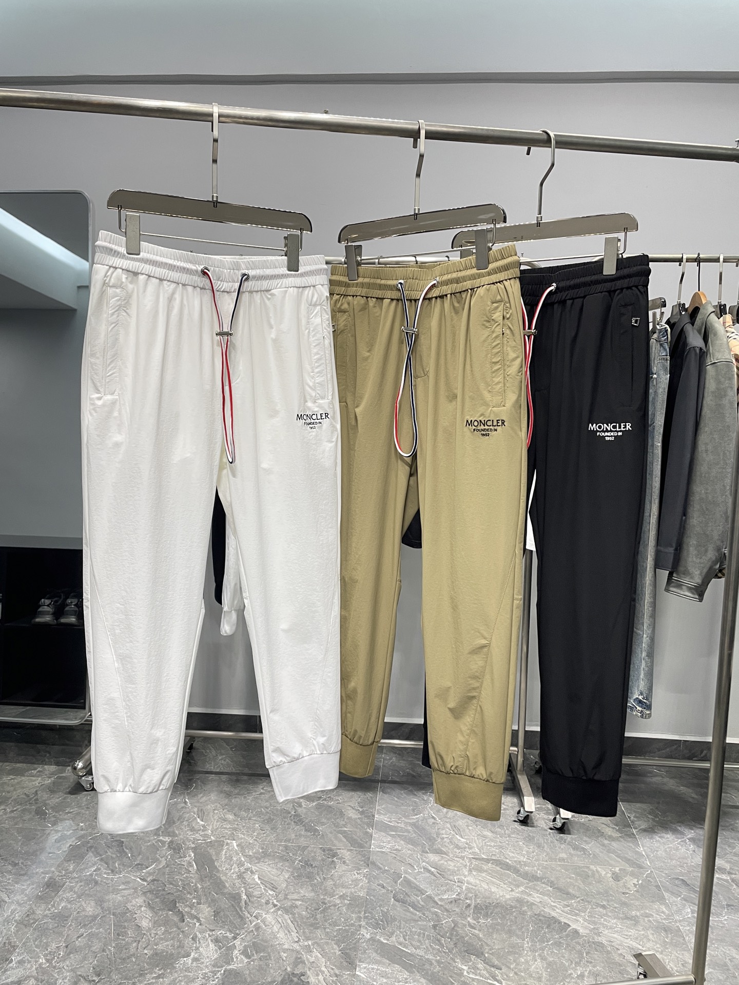 NO:141299,MON25SS spring and summer new lightweight woven fabric drawstring ties, men's classic three-color webbing drawstring sports and casual trousers cropped trousers!  Trading companies have sparse channels and are on sale on the leading official website!  A trendy item that combines fashion and functions is versatile and not picky. Whether it is matched with a simple T-shirt, shirt, or a trendy sweatshirt or jacket, it can be easily controlled, showing different styles and charms!  The fabric is made of customized technology woven materials for customer supply. It not only has a thin, silky and elastic touch, but also fits like a second layer of skin, but also brings unprecedented breathable and comfortable feeling in the hot summer!  Every time I wear it, it feels like I am in the breeze, allowing my skin to breathe freely, enjoying freedom and comfort!  The classic letter logo embroidery on the legs of the trouser is vividly displayed. This iconic design not only demonstrates the unique charm of the brand, but also forms a strong visual impact, making it unforgettable at a glance!  At the same time, the waistband is cleverly combined with exquisite three-color woven label decoration. These elements complement each other and form the unique logo of the brand, making people stand out easily among the crowd!  The details are also perfect. The zipper opening and closing pocket design not only makes it easy to put on and take off, but also invisibly improves the overall texture and grade!  The complete three-color drawstring elastic waist design fully takes into account the needs of different figures. Whether it is tight or loose, it can be easily adjusted, allowing you to switch between comfort and fashion freely!  The trouser legs are made of ribbed splicing and tie-up design. This design not only cleverly modifys the leg shape, making the legs look longer and straighter, but also visually lengthens the overall proportion, allowing you to instantly have the déjà vu!  Color white, khaki, black Size M-3XL Size reference M size waist 74 hip circumference thigh circumference 56 pants length 94 L size waist 78 hip circumference 104 thigh circumference 58 pants length 95 XL size waist 82 hip circumference thigh circumference 60 pants length 96 2XL size waist 86 hip circumference 112 thigh circumference 62 pants length 97 3XL size waist 90 hip circumference 116 thigh circumference 64 pants length 9808, hoodie, sweatshirts, jackets & coats,shirts,tees, t-shirt,alexander wang19860909MON25SS春夏新款轻薄梭织面料抽绳束脚卫裤,男士经典三色织带抽绳运动休闲长裤九分裤！贸易公司渠道稀出,领先官网发售！一款集时尚与功能于一身的潮流单品,百搭不挑人.无论是搭配简约的T恤、衬衫,还是潮流的卫衣、外套,都能轻松驾驭,展现出不同的风格与魅力！ 其面料采用了客供定制科技梭织材料,不仅触感轻薄丝滑有弹力,如同第二层肌肤般贴合,更在炎炎夏日里带来了前所未有的透气舒适感！每一次穿着都仿佛置身于清风之中,让肌肤自由呼吸,尽享自在与惬意！裤腿处经典字母logo刺绣跃然其上,这一标志性的设计不仅彰显了品牌的独特魅力,更在视觉上形成了强烈的冲击力,让人一眼难忘！与此同时裤腰还巧妙地结合了精致的三色织唛装饰,这些元素相互映衬,共同构成了品牌的独特标识,让人在人群中轻松脱颖而出！ 在细节方面同样做得尽善尽美,拉链开合的口袋设计,不仅穿脱方便,更在无形中提升了整体的质感与档次！链接完整的三色抽绳松紧的裤腰设计,则充分考虑到了不同身材的需求,无论是紧致还是宽松,都能轻松调节,让你在舒适与时尚之间自由切换！裤脚处采用了罗纹拼接束口设计,这一设计不仅巧妙地修饰了腿型,让双腿看起来更加修长笔直,更在视觉上拉长了整体的比例,让你瞬间拥有大长腿的既视感！ 颜色白色、卡其色、黑色 尺码M-3XL 尺寸参考 M码腰围74臀围大腿围56裤长94 L码腰围78臀围104大腿围58裤长95 XL码腰围82臀围大腿围60裤长96 2XL码腰围86臀围112大腿围62裤长97 3XL码腰围90臀围116大腿围64裤长9808,,hoodie,sweatshirts,jackets & coats,shirts,tees，t-shirt,alexander wang,Men's clothing