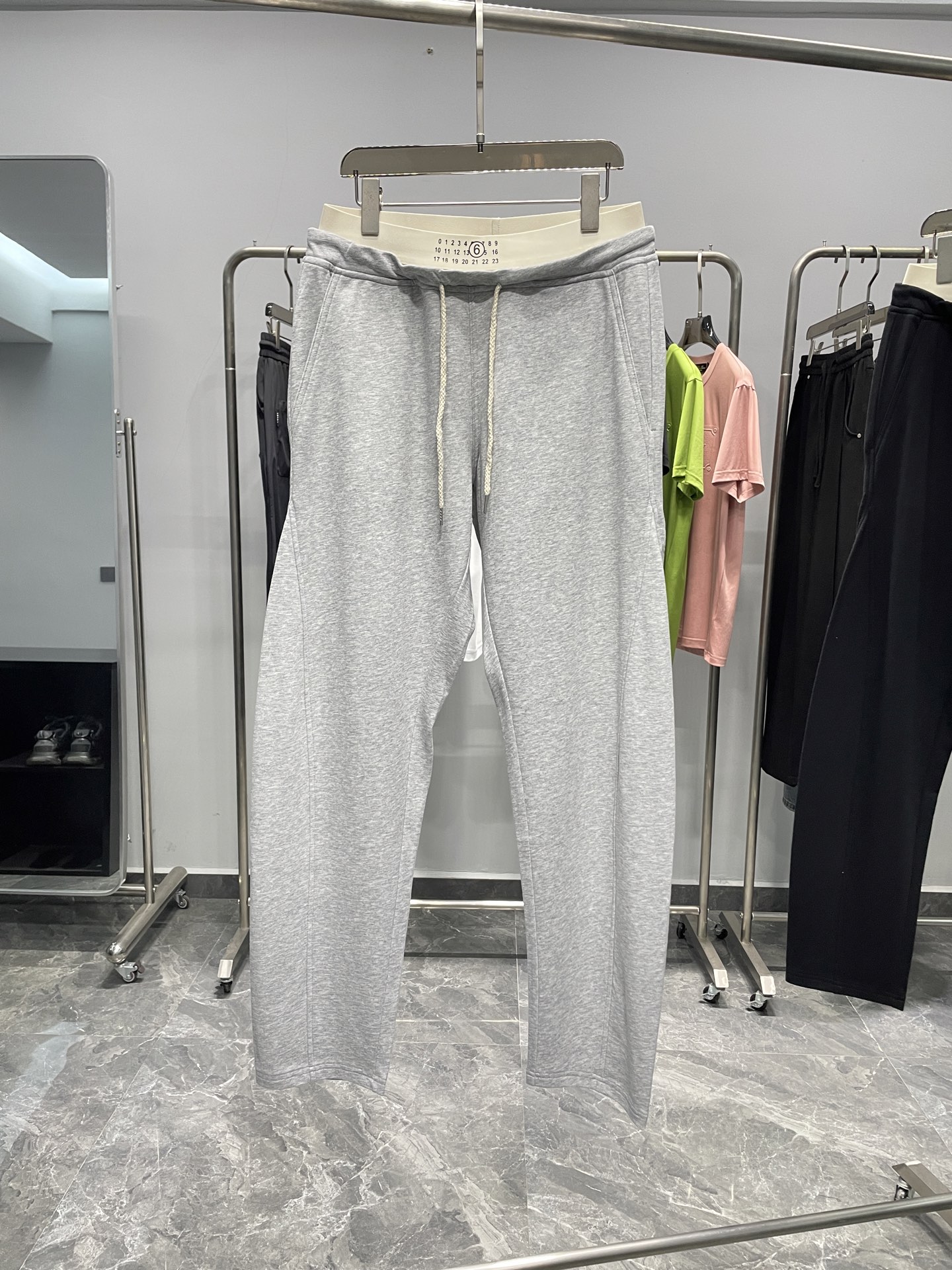 NO:136934,MM6 spring and summer new 25SS double waist contrast color design for men's fashionable casual sweatpants casual pants trousers!  With its excellent quality, unique design and exquisite craftsmanship, MM6 scimitar casual pants have become the only difference between urban people who pursue fashion and comfort. Whether it is daily travel or casual gatherings, you can easily control various occasions and show your unique charm!  This trouser is made of high-quality terry cotton cloth customized by customers. The fabric has been carefully selected and processed to show the clarity and delicateness of the needle-chip texture, bringing an extraordinary comfort experience to the wearer!  The design incorporates the design elements of the fashionable elastic waist splicing fake two pieces, which not only retains the ease and freedom of casual pants, but also adds a sense of layering and fashion!  The three-dimensional offset digital logo in the center of the waist not only shows the unique brand characteristics, but also cleverly demonstrates the wearer's identity and status, making it unforgettable at a glance!  The details show the ingenuity of craftsmanship. The four corner stitching embroidery of the back pocket outlines the indispensable elements of the brand with exquisite craftsmanship and delicate lines, highlighting the wearer's taste and style!  The cutting design of the three-dimensional spliced ​​scimitar pants gives the pants a unique visual effect, and the upper body is fashionable and handsome, making people instantly the focus of the streets and alleys!  Color gray, black Size S-XL Size reference M size waist 76 hip 116 thigh 66 trousers length 108 trousers legs 36,,masion margiela,alexander wang19860909MM6春夏新款25SS双腰头撞色设计男士时尚休闲卫裤休闲裤长裤！MM6弯刀休闲裤以其卓越的品质、独特的设计和精湛的工艺,成为了追求时尚与舒适的都市人的不二无论是日常出行还是休闲聚会,都能让你轻松驾驭各种场合,展现出自己的独特魅力！这款裤装采用客供定制的优质毛圈棉布,面料经过精心挑选与处理,展现出针凿纹理的清晰与细腻,为穿着者带来非凡的舒适体验！设计上融入了时尚松紧腰拼接假两件的设计元素,既保留了休闲裤的轻松自在,又增添了层次感和时尚度！腰头中央的立体胶印数字标识,不仅展现出独特的品牌特色,还巧妙地彰显了穿着者的身份地位,让人一眼难忘！细节之处更是彰显匠心独运,后兜四角缝线刺绣,以精湛的工艺和细腻的线条,勾勒出品牌不可或缺的元素,彰显出穿着者的品味与格调！而立体拼接式弯刀裤型的裁剪设计,则赋予了这款裤子独特的视觉效果,上身时髦帅气,让人瞬间成为街头巷尾的焦点！ 颜色灰色、黑色 尺码S-XL 尺寸参考 M码腰围76臀围116大腿围66裤长108裤脚36,,masion margiela,alexander wang,Men's clothing