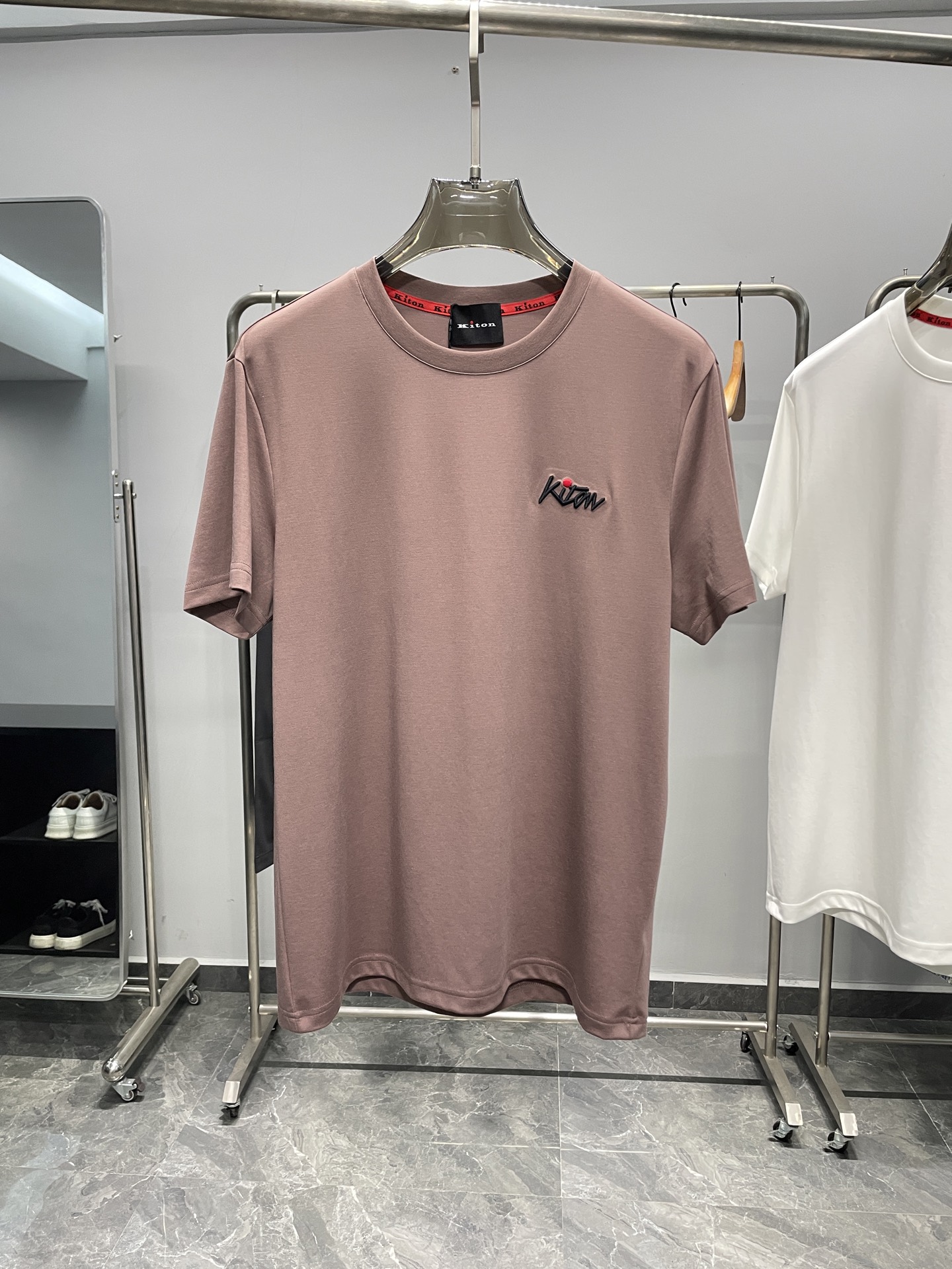 NO:511176,KITON25SS spring and summer new modal cotton blend round neck short Tee, men's three-dimensional embroidered logo basic casual short-sleeved T-shirt!  Trading companies have sparse channels and are on sale on the leading official website!  KITON's new T-shirt, with its unique charm and excellent quality, has become a shining pearl in the fashion industry!  The fabric is made of custom-made modal cotton blend material, and this carefully selected fabric gives the T-shirt an unparalleled touch experience!  Silky and delicate, as if a gentle breeze blows across the skin, bringing endless comfort and pleasantness!  The logo embroidered with letters on the chest not only highlights the brand's unique style, but also inadvertently reveals the extraordinary identity and status of the wearer!  This logo seems to be a work of art, quietly telling KITON's persistent pursuit of quality and its ultimate control over details!  The basic straight-tube style is one of the reasons why it is very popular. It is not limited by age. Whether it is young people or mature and steady middle-aged people, they can easily control this T-shirt and show their unique charm!  Color Pink, White, Navy, Gray Blue, Gray Apricot, Black Size M-3XL Size Reference M Size Shoulder Width 45 Bust 100 Long 66 L Size Shoulder Width 46 Bust 104 Long 67 XL Size Shoulder Width 47 Bust 108 Long 68 XXL Size Shoulder Width 48 Bust 112 Long 69 XXXL Size Shoulder Width 49 Bust 116 Long 70, T-shirt,tees, t-shirt,alexander wang19860909KITON25SS春夏新款莫代尔棉质混纺圆领短Tee,男士立体刺绣标识基础休闲短袖T恤衫！贸易公司渠道稀出,领先官网发售！KITON新款T恤,以其独特的魅力和卓越的品质,成为了时尚界的一颗璀璨明珠！ 其面料采用了客供定制的莫代尔棉质混纺材料,这一精心挑选的面料赋予了T恤无与伦比的触感体验！丝滑细腻,仿佛轻柔的微风拂过肌肤,带来无尽的舒爽与宜人！胸前字母刺绣的logo标识,不仅彰显了品牌的独特风格,更在不经意间透露出穿着者不凡的身份与地位！这标识仿佛是一件艺术品,静静地诉说着KITON对品质的执着追求和对细节的极致把控！基础直筒版型,更是其深受喜爱的原因之一,它不受年龄的限制,无论是青春洋溢的年轻人,还是成熟稳重的中年人士,都能轻松驾驭这款T恤,展现出各自的独特魅力！ 颜色粉咖色、白色、藏青色、灰蓝色、灰杏色、黑色 尺码M-3XL 尺寸参考 M码肩宽45胸围100衣长66 L码肩宽46胸围104衣长67 XL码肩宽47胸围108衣长68 XXL码肩宽48胸围112衣长69 XXXL码肩宽49胸围116衣长70,,T-shirt,tees，t-shirt,alexander wang,Men's clothing