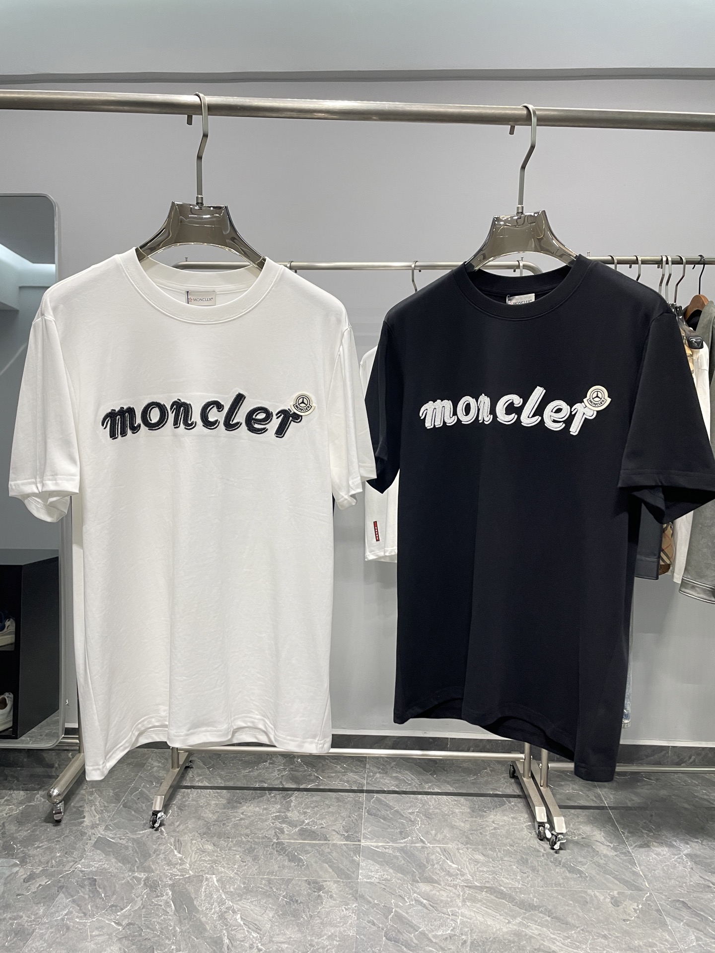 NO:491991,MON X Mercedes heavyweight joint 25SS spring and summer new jersey cotton round neck short Tee, the same style as men and women!  Car logo badge paired with letter logo embroidered casual pullover short-sleeved T-shirt!  Trading companies have sparse channels and are on sale on the leading official website!  Walking in the streets and alleys in your clothes, you may inadvertently attract the attention of passers-by!  They may be attracted by your front badge, or they may be admired by your overall dressing style!  This T-shirt is made of custom-made jersey cotton, which not only feels soft and comfortable, but also performs excellently in breathability and hygroscopicity, ensuring that the wearer can enjoy refreshing and freedom even in the hot summer!  The design is simple but generous, without too much complex decoration, but it can perfectly show the brand's unique tone. The front-facing Mercedes-Benz logo logo and M-home letter embroidery are fusion, both representing the brand's history and glory, as if telling unknown stories!  The basic and versatile casual round neck style design makes daily outfits calm. Whether it is attending friends' gatherings or conducting outdoor leisure activities, this T-shirt can become your best partner and make you stand out from the crowd!  Color white, black Size S-XXL Size reference S size shoulder width 45 bust 100 length 68 M size shoulder width 46 bust 104 length 69 L size shoulder width 47 bust 108 length 70 XL size shoulder width 48 bust 112 length 71 XXL size shoulder width 49 bust 116 length 72, T-shirt,tees,t-shirt,alexander wang19860909MON X 梅赛德斯重磅联名25SS春夏新款平纹针织棉布圆领短Tee,男女同款！车标徽章搭配字母标识刺绣休闲套头短袖T恤衫！贸易公司渠道稀出,领先官网发售！穿着它走在街头巷尾,你或许会不经意间吸引到路人的目光！他们或许会被你前幅徽章所吸引,或许会赞叹你整体的穿搭风格！ 这款T恤衫采用客供定制平纹针织棉布,不仅触感柔软舒适,更在透气性与吸湿性上表现出色,确保了穿着者即使在炎炎夏日也能享受到清爽与自在！设计简约而不失大方,没有过多的繁复装饰,却能完美展现品牌的独特调性,前幅奔驰车标Logo和M家字母刺绣融合,他们都代表着品牌的历史与荣耀,仿佛在诉说着不为人知的故事！基础百搭休闲圆领版型设计,更是让日常穿搭变得从容不迫,无论是出席朋友聚会,还是进行户外休闲活动,这款T恤都能成为你的最佳拍档,让你在人群中脱颖而出！ 颜色白色、黑色 尺码S-XXL 尺寸参考 S码肩宽45胸围100衣长68 M码肩宽46胸围104衣长69 L码肩宽47胸围108衣长70 XL码肩宽48胸围112衣长71 XXL码肩宽49胸围116衣长72,,T-shirt,tees，t-shirt,alexander wang,Men's clothing