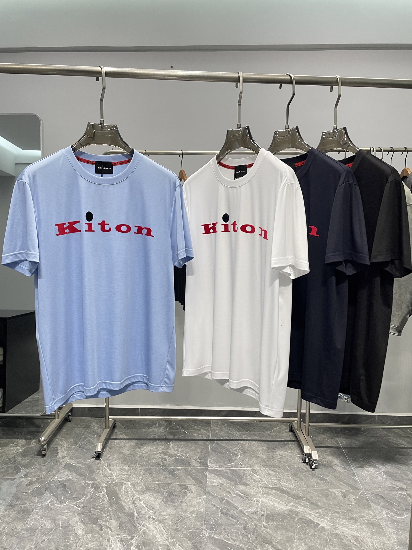 NO:460295,KITON25SS spring and summer new high-quality mercerized cotton basic round neck short Tee, men and women same red flocking letter logo casual pullover short-sleeved T-shirt! Trading companies have sparse channels and are released on the official website at the same time! Seeing the true details, KITON's new T-shirt has become the first choice for many fashion experts and quality life pursuers with its excellent quality quality, fashionable design and versatile style! The fabric is made of high-quality cotton customized by customers. This unique choice makes it more silky and skin-friendly than ordinary mercerized cotton. It not only has excellent touch, but also has excellent breathability and moisture absorption, and can keep the wearer dry and comfortable even in the hot summer! A striking red letter logo pattern on the front of the T-shirt is embellished, like the finishing touch, instantly enhancing the fashion sense and recognition of the entire T-shirt! This is not an ordinary printing or embroidery pattern, but is carefully crafted using high-end hot-press flocking technology! This craftsmanship not only makes the pattern bright and three-dimensional, but also shows the brand's ingenuity and excellent quality in the details! The casual straight round neck design is not only simple and elegant, but also visually lengthens the neck lines, making the wearer more energetic and capable! At the same time, the straight-tube style design makes the upper body of the T-shirt versatile and not picky, and can be easily controlled by both height, shortness, fatness and thinness! Color sky blue, white, navy blue, black Size M-3XL Size reference M Size shoulder width 45 bust length 66 L Size shoulder width 46 bust 104 bust length 67 XL Size shoulder width 47 bust length 68 XXL Size shoulder width 48 bust 112 bust length 69 XXXL Size shoulder width 49 bust 116 bust length 70, T-shirt,tees, t-shirt,alexander wang19860909KITON25SS春夏新款优质丝光全棉基础圆领短Tee,男女同款红色植绒字母标识休闲套头短袖T恤衫！贸易公司渠道稀出,同步官网发售！在细节之处见真章,KITON新款T恤以其卓越的品质、时尚的设计以及百搭的版型,成为了众多时尚达人与品质生活追求者的首选之选！ 其面料采用的是客供定制的优质全棉材质,这一独特选择使得它在触感上相较于普通的丝光棉有着更为显著的丝滑与亲肤感受,不仅触感卓越,更拥有着优异的透气吸湿性,即便在炎炎夏日也能保持穿着者的干爽与舒适！T恤正面一抹醒目的红色字母标识图案点缀其上,犹如点睛之笔,瞬间提升了整件T恤的时尚感与辨识度！这并非普通的印刷或刺绣图案,而是采用了高端的热压植绒工艺精心打造而成！这种工艺使得图案不仅色泽鲜艳、立体感强,更在细节之处彰显出品牌的匠心独运与卓越品质！休闲直筒的圆领设计,不仅简约大方,更在视觉上拉长了颈部线条,使得穿着者更显精神与干练！同时直筒的版型设计,使得T恤上身效果百搭不挑人,无论是高矮胖瘦,都能轻松驾驭！ 颜色天蓝色、白色、藏青色、黑色 尺码M-3XL 尺寸参考 M码肩宽45胸围衣长66 L码肩宽46胸围104衣长67 XL码肩宽47胸围衣长68 XXL码肩宽48胸围112衣长69 XXXL码肩宽49胸围116衣长70,,T-shirt,tees，t-shirt,alexander wang,Men's clothing