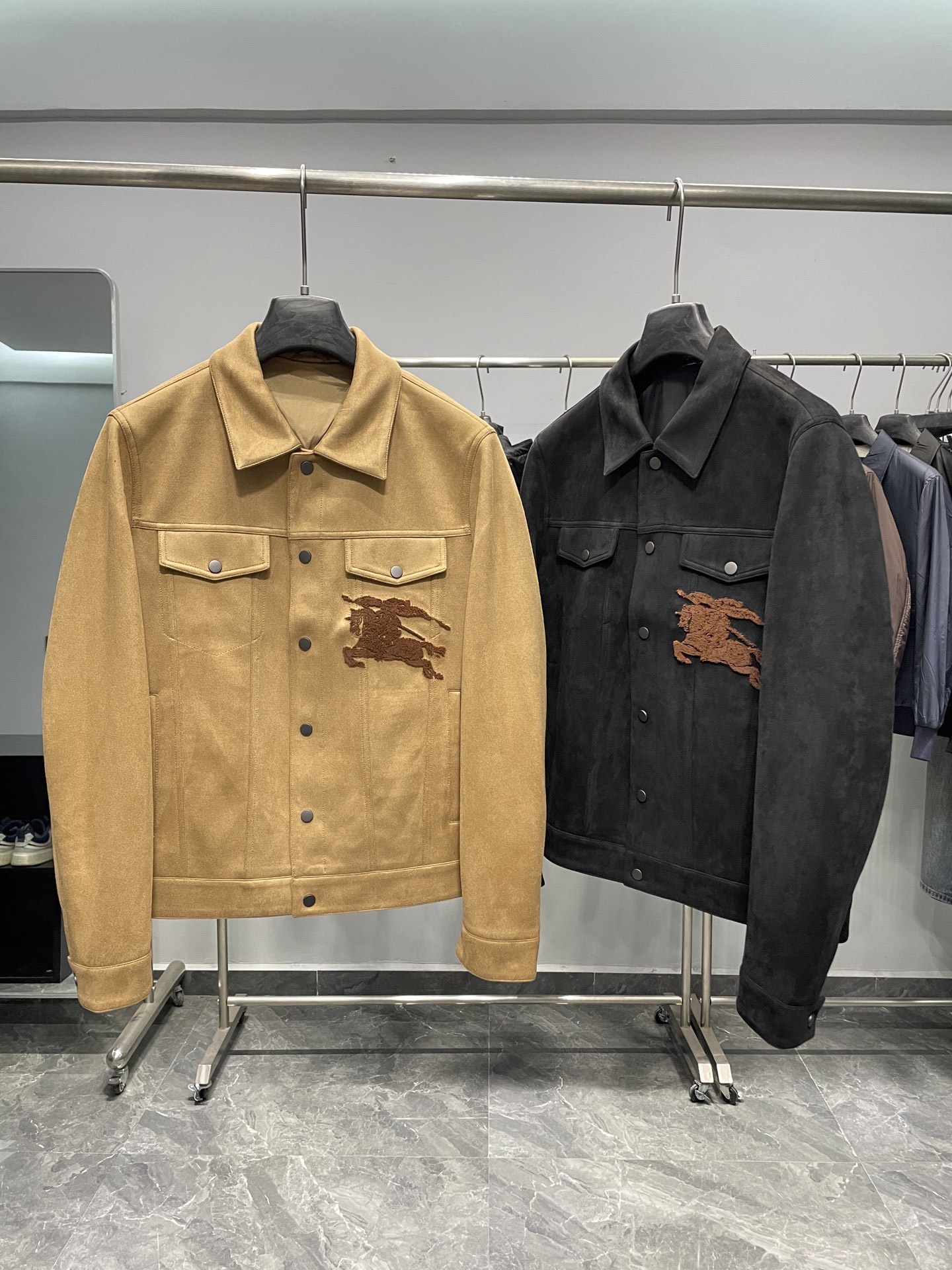 NO:522731,~BUR2025FW new men's suede texture lapel jacket!  The overall design belongs to the classic denim jacket style, with a crisp style and a casual and fashionable feeling. There are two color choices, namely khaki and black, to meet different dressing needs and preferences. The classic lapel design is simple and elegant, and can well modify the neck lines. It is suitable for metal button matching. The buttons on the khaki jacket are dark gray, and the buttons on the black jacket are silver, which increases the overall texture and durability. There are two symmetrical flip pockets on the chest, which are not only practical, but also enhance the layering and decorativeness of the jacket!  Near the chest pocket, there is the brand's iconic horse riding knight embroidery pattern, made of brown thread embroidered with fine craftsmanship, which is the brand's highly recognizable element. The cuffs are buttons that can adjust the tightness of the cuffs, which is convenient for wearing and can withstand a certain amount of wind and cold. The back design is simple, with brown fabric patch decoration on both sides of the bottom, which increases the sense of detail and design. The jacket is lined inside, and the khaki jacket is in the same color. The material looks smooth and comfortable, which improves the comfort during wear and makes the jacket more stylish. The fabric has a suede texture, soft touch and a certain thickness, which can adapt to wearing in many occasions. The blend of polyester fiber and spandex makes the fabric both crisp and elastic, making it more flexible and more comfortable to wear. The lining is made of polyester fiber, which is smooth and breathable, which helps to improve the overall wear comfort. Color khaki and black  Size M-3XL Size reference M size shoulder width 44 bust 108 sleeve length 64 clothes length 64 L size shoulder width 45 bust 112 sleeve length 65 clothes length 65 XL size shoulder width 46 bust 116 sleeve length 66 clothes length 66 2XL size shoulder width 47 bust 120 sleeve length 67 clothes length 67 clothes length 3XL size shoulder width 48 bust 124 sleeve length 68 clothes length 68, burberry, jackets & coats, jackets & coats, chamois leather, alexander wang19860909～BUR2025FW新款男士麂皮质感翻领夹克外套！整体设计属于经典的牛仔夹克款式,版型挺括 ,具有休闲时尚感.提供两种颜色选择,分别是卡其色和黑色 ,满足不同的穿搭需求和喜好. 采用经典的翻领设计,简洁大方,能很好地修饰颈部线条.适用金属纽扣搭配,卡其色夹克上的纽扣为深灰色,黑色夹克上的纽扣为银色,增加了整体的质感和耐用性.胸前设有两个对称的翻盖口袋,不仅具有实用性,可以放置小物件,还增强了夹克的层次感和装饰性！胸前口袋附近,有品牌标志性的骑马骑士刺绣图案,采用棕色线绣制,工艺精细,是该品牌辨识度极高的元素.袖口处设有纽扣,可以调节袖口的松紧度,方便穿着且能抵御一定的风寒.背部设计简洁,在底部两侧有棕色的布质贴片装饰,增加了细节感和设计感. 夹克内部配有衬里,卡其色夹克的内衬为同色系,材质看起来光滑舒适,提升了穿着时的舒适度,也使得夹克更有型.面料具有麂皮质感,触感柔软且有一定的厚度,能适应多种场合穿着.聚酯纤维和氨纶的混纺使得面料既有一定的挺括性,又具备一定的弹性,穿着活动更自如.里料采用聚酯纤维,顺滑透气,有助于提升整体穿着的舒适度. 颜色卡其色、黑色 尺码M-3XL 尺寸参考 M码肩宽44胸围108袖长64衣长64 L码肩宽45胸围112袖长65衣长65 XL码肩宽46胸围116袖长66衣长66 2XL码肩宽47胸围120袖长67衣长67 3XL码肩宽48胸围124袖长68衣长68,,burberry,jackets & coats,jackets & coats,chamois leather,alexander wang,Men's clothing