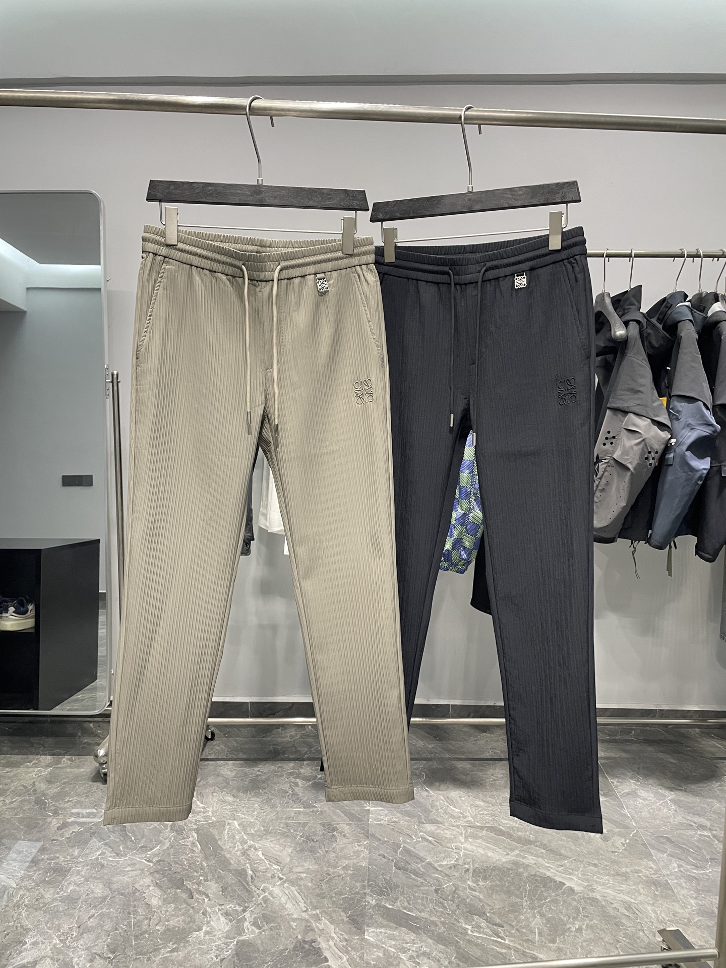 NO:525506,LOE25FW early autumn new three-dimensional vertical striped drawstring casual pants, men's metal logo pendant fashionable and versatile straight casual pants!  Trading companies have sparse channels and are on sale on the leading official website!  There are always some items that stand out with their unique design and excellent quality, and LW vertical striped casual pants are one of them!  When you first turn your eyes to it, you will be attracted by the unique charm it exudes!  This casual pants are made of customized three-dimensional vertical striped textures. The texture is so thin that it seems to have no weight, but it really fits your skin, bringing an unparalleled comfort experience!  The three-dimensional vertical striped texture is like a lively note, jumping on the pants, adding a unique fashionable rhythm to the overall shape!  The front and back are embroidered with classic letter logos. The exquisite embroidery craftsmanship seems to be carefully outlined by the artist with delicate brushstrokes. Each stitch and thread are closely connected, the lines are smooth and natural, the outlines of the letters are clearly visible, full of recognition!  The metal logo embellishment at the waist is the finishing touch of these pants!  It is small and exquisite, shining with charming light under the sunlight, adding a sense of luxury and texture to the originally simple pants!  The drawstring elastic waist design fully takes into account the needs of people with different figures. Whether you are a slim fashion expert or a slightly plump personality, you can find the elasticity that suits you best by adjusting the drawstring, so that the pants fit perfectly on your waist, and will not be too tight or too loose!  The straight-tube style is a classic among the classics. It can well modify the leg shape and make your legs look straight, slender, capable and neat!  Color khaki, black Size M-3XL Size reference M size waist 78/84cm-Hip circumference 98cm-front 28cm-thigh circumference 58cm-thigh length 100cm-trouser legs 34cm L size waist 82/88cm-thigh circumference 102cm-front 29cm-thigh circumference 60cm-trouser length 101cm-trouser legs 35cm XL size waist 86/92cm-thigh circumference 106cm-front 30cm-thigh circumference 62cm-trouser length 102cm-trouser legs 36cm XXL size waist 90/96cm-thigh circumference 110cm-front 30cm-thigh circumference 64cm-trouser legs 103cm-trouser legs 37cm  3XL size waist 94/100cm - hip circumference 114cm - front gear 31cm - thigh circumference 66cm - trouser length 104cm - trouser legs 38cm recommended size (standard version) Height 174-140 catties, try on size L appropriately!  A boy can choose M code within 133 catties, a L code for 133-146 catties, a XL code for 146-160 catties, a XXL code for 160-174 catties, and a 3XL code for 174-188 catties!  ,loewe,alexander wang19860909LOE25FW早秋新款立体竖条纹抽绳休闲裤,男士金属徽标吊坠时尚百搭直筒休闲长裤！贸易公司渠道稀出,领先官网发售！总有一些单品能凭借独特的设计与卓越的品质脱颖而出,LW竖条纹休闲裤便是其中之一！当你第一次将目光投向它,便会被其散发出的独特魅力所吸引！ 这款休闲裤采用客供定制立体竖条纹肌理面料,质地轻薄得仿佛没有重量,却又实实在在地贴合着你的肌肤,带来一种无与伦比的舒适体验！立体竖条纹肌理,犹如灵动的音符,在裤子上跳跃,为整体造型增添了一份独特的时尚韵律！前后幅都绣有经典的字母徽标,那精湛的刺绣工艺,仿佛是艺术家用细腻的笔触精心勾勒而成,每一针每一线都紧密相连,线条流畅而自然,字母的轮廓清晰可见,充满了辨识度！ 而腰部的金属徽标点缀,更是这款裤子的点睛之笔！它小巧而精致,在阳光的照耀下闪烁着迷人的光芒,为原本简约的裤子增添了一份奢华与质感！抽绳松紧裤腰设计,充分考虑了不同身材人群的需求,无论你是身材苗条的时尚达人,还是体型稍显丰满的个性人士,都能通过调节抽绳找到最适合自己的松紧度,让裤子完美贴合你的腰部,既不会过于紧绷,也不会过于松垮！直筒的版型更是经典中的经典,它能够很好地修饰腿型,让你的双腿看起来更加笔直修长、干练利落！ 颜色卡其色、黑色 尺码M-3XL 尺寸参考 M码腰围78/84cm-臀围98cm-前档28cm-大腿围58cm-裤长100cm-裤脚34cm  L码腰围82/88cm-臀围102cm-前档29cm-大腿围60cm-裤长101cm-裤脚35cm  XL码腰围86/92cm-臀围106cm-前档30cm-大腿围62cm-裤长102cm-裤脚36cm  XXL码腰围90/96cm-臀围110cm-前档30cm-大腿围64cm-裤长103cm-裤脚37cm  3XL码腰围94/100cm-臀围114cm-前档31cm-大腿围66cm-裤长104cm-裤脚38cm 尺码推荐（标准版型） 身高174-140斤,试穿L码合适！ 男生体重133斤以内选择M码,133-146斤选择L码,146-160斤选择XL码,160-174斤选择XXL码,174-188斤选择3XL码！,,loewe,alexander wang,Men's clothing