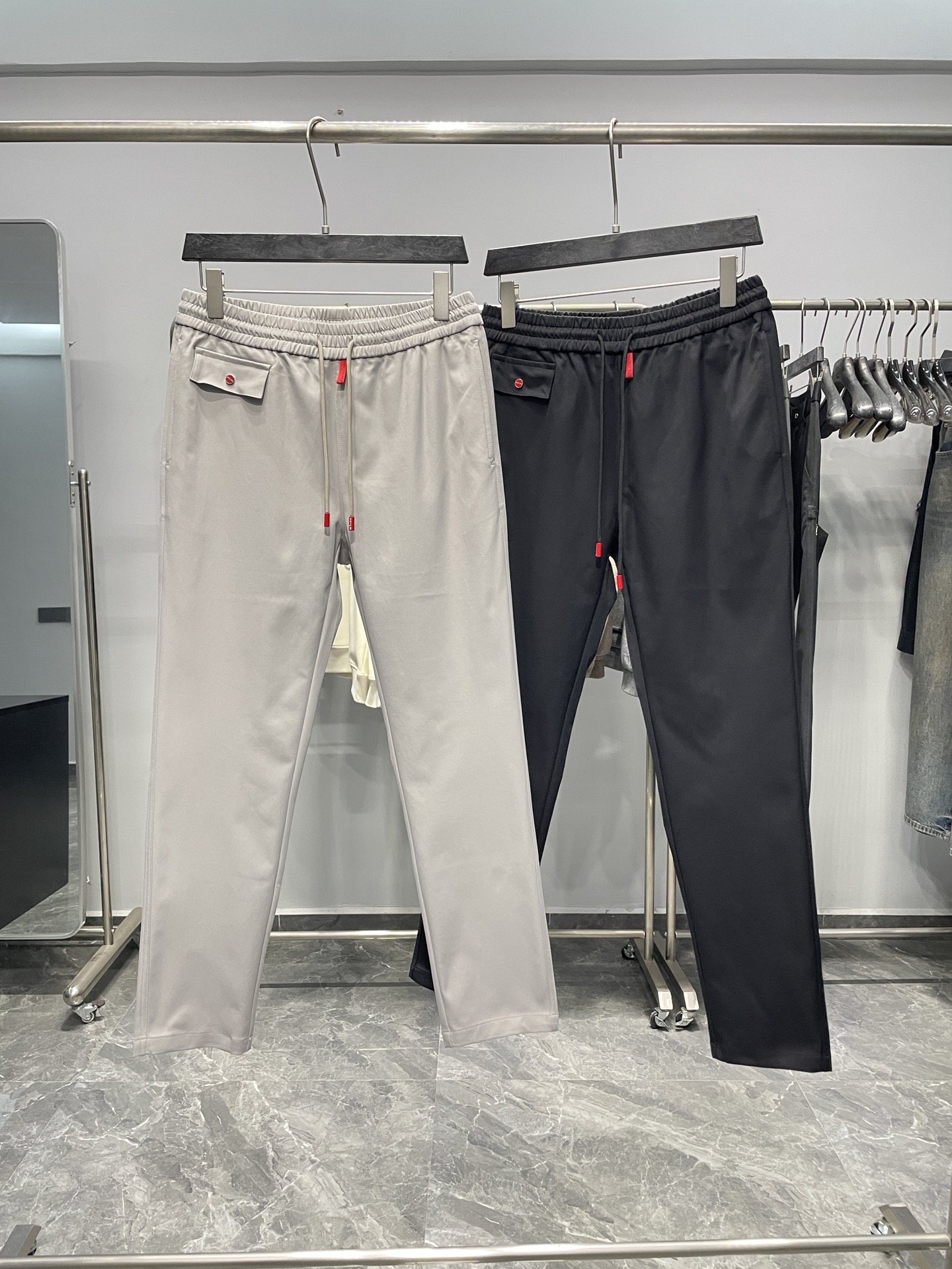 NO:525515,KITON25FW early autumn new tightly woven cotton drawstring casual pants, men's placket red label straight versatile casual pants!  Trading companies have sparse channels and are on sale on the leading official website!  Kiton's early autumn casual pants have become the first choice for urban men to pursue fashion and comfort with their exquisite craftsmanship and unique design!  This pants are made of customized dense twill cotton fabric for customer supply. The texture is delicate and the feel is smooth. The fabric is clearly visible and the lines are smooth. The overall appearance presents a crisp and stylish beauty!  The cleverly eye-catching red label on the placket of the pants not only adds a bright color to the overall design, but also demonstrates the brand's ingenuity in the details!  At the same time, the waist rope pendant of the trouser waist rope also uses the same red tone, forming a perfect echo with the placket label, making the whole trouser more visually harmonious and unified!  The red buttons on the pocket are also a clever design. They not only echo the color of the placket label and the waist rope pendant, but also cleverly improve their practicality. They are not only firm and durable, but also easy to buckle, allowing the wearer to easily deal with various occasions in daily life!  The style adopts a classic straight-tube design. This style can not only modify the leg shape, but also give the wearer enough comfort!  Color gray, black Size M-3XL Size reference M size waist 76 hip circumference 100 thigh circumference 60 thigh circumference 103 trousers 34 L size waist 80 hip circumference 104 thigh circumference 62 trousers 104 trousers 35 XL size waist 84 hip circumference 108 thigh circumference 64 trousers 105 trousers 36 XXL size waist 88 hip circumference 112 thigh circumference 66 trousers 106 trousers 37 3XL size waist 92 hip circumference 116 thigh circumference 68 trousers 107 trousers 38 Size recommendation (standard version) Height 174-140 catties, try on size L appropriately!  A boy can choose M code within 133 catties, a L code for 133-146 catties, a XL code for 146-160 catties, a XXL code for 160-174 catties, and a 3XL code for 174-188 catties!  ,alexander wang19860909KITON25FW早秋新款密织斜纹棉布抽绳休闲裤,男士门襟红色标签直筒百搭休闲长裤！贸易公司渠道稀出,领先官网发售！Kiton早秋新款休闲裤以其精湛的工艺和独特的设计,成为了当下都市男性追求时尚与舒适的首选！ 这款裤子采用客供定制密织斜纹棉布,质地细腻,手感柔滑,面料织纹清晰可见,线条流畅,整体呈现出一种挺括有型的美感！裤子门襟处巧妙地醒目的红色标签,这不仅为整体设计增添了一抹亮色,更在细节处彰显了品牌的匠心独运！与此同时裤腰绳头吊坠也采用了相同的红色调,与门襟标签形成了完美的呼应,使得整个裤子在视觉上更加和谐统一！口袋上的红色纽扣也是一处巧妙的设计,它不仅在色彩上与门襟标签和裤腰绳头吊坠相呼应,更在实用性上进行了巧妙的提升,不仅牢固耐用,而且易于扣合,使得穿着者在日常生活中能够轻松应对各种场合！版型采用了经典的直筒设计,这种版型既能够修饰腿型,又能够给予穿着者足够的舒适度！ 颜色灰色、黑色 尺码M-3XL 尺寸参考 M码腰围76臀围100大腿围60裤长103裤脚34 L码腰围80臀围104大腿围62裤长104裤脚35 XL码腰围84臀围108大腿围64裤长105裤脚36 XXL码腰围88臀围112大腿围66裤长106裤脚37 3XL码腰围92臀围116大腿围68裤长107裤脚38 尺码推荐（标准版型） 身高174-140斤,试穿L码合适！ 男生体重133斤以内选择M码,133-146斤选择L码,146-160斤选择XL码,160-174斤选择XXL码,174-188斤选择3XL码！,,alexander wang,Men's clothing