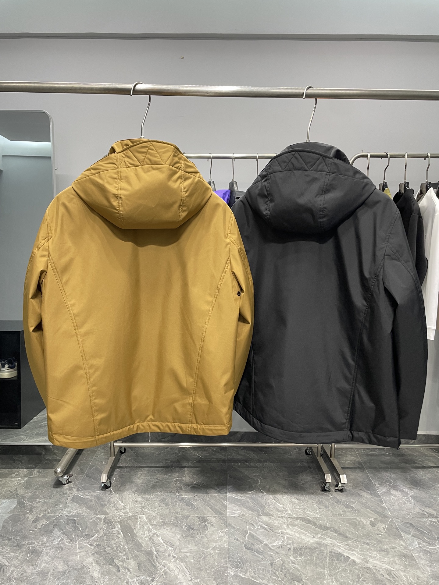 DBU6606P490～BUR25FW秋冬新品男女同款户外防风连帽软壳棉衣外套冲锋衣!整体版型较为宽松 ，穿着起来舒适自在，同时方便内搭不同厚度的衣物，适应多种场合和温度环境。
连帽设计，增添实用性和时尚感，能够在风雨天气为头部提供防护。
在胸前位置，有明显BUR品牌标识，黑色外套上是白色字体，黄色外套上是深色字体，增强了品牌辨识度！拉开拉链后，可以看到经典的格纹内衬，彰显品牌特色与高端质感。
外套正面采用品牌定制拉链，拉链头上刻有logo钢印，顺滑耐用，保证开合顺畅，同时拉链顶端设有防护装置，防止夹到皮肤或衣物 。两侧设有拉链口袋，可以安全存放随身物品，防止物品掉落，拉链设计也能在一定程度上防水。帽子带有调节装置，抽绳和调节扣的设计，可以根据需求调整帽子的松紧，更好地贴合头部，增强防风效果 。袖口处配备魔术贴调节装置，可以自由调整袖口的松紧度，既能防止冷风灌入，又能适应不同手腕粗细 。
外套外部主要面料为100%聚酯纤维，这种材质具有良好的防风、防水和耐磨性，适合户外穿着。内层为100%棉，亲肤舒适，能够提升穿着时的体感舒适度，避免皮肤与外层聚酯纤维直接接触可能产生的不适！

颜色：黄色、黑色
尺码：48-56
尺寸参考：
48码:肩宽48胸围112袖长60衣长70
50码:肩宽49胸围116袖长61衣长71
52码:肩宽50胸围120袖长62衣长72
54码:肩宽51胸围124袖长63衣长73
56码:肩宽52胸围128袖长64衣长74