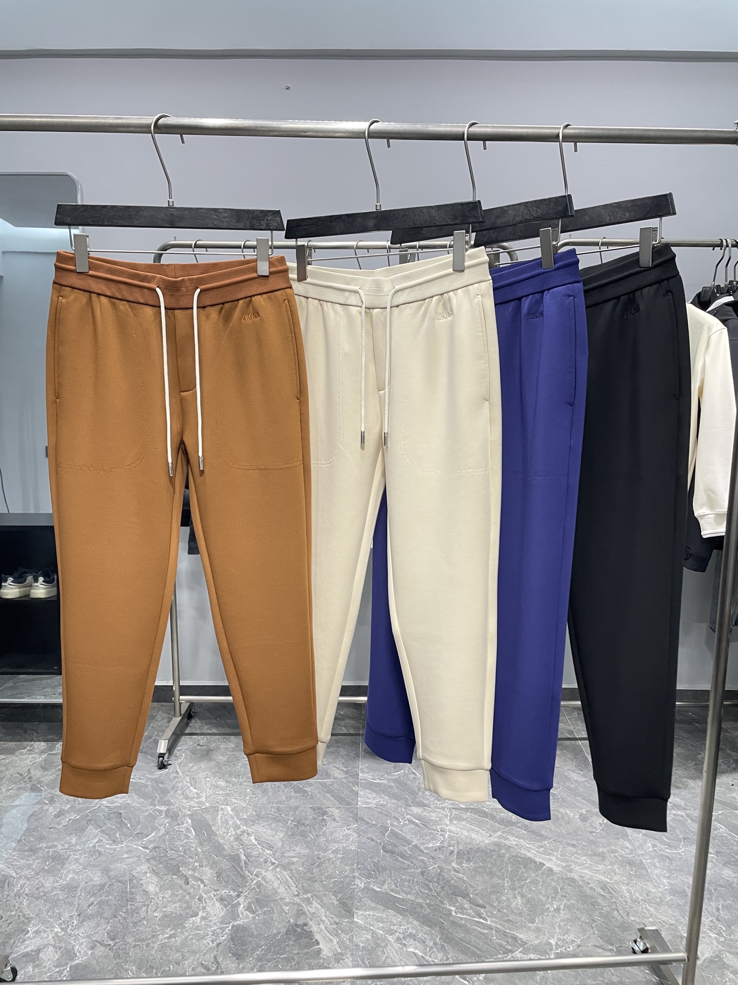 NO:653813,EZ25FW new autumn and winter air layer cotton drawstring leggings sweatpants, men's classic embroidered logo fashion sports casual trousers and nine-minute pants!  Trading company channels are rare, leading official website sales!  Z family’s new sweatpants are recommended. They are outstanding in terms of fabric, design and pattern cutting. They are a very recommended fashion item!  The sweatpants are made of custom-made air-layer cotton. This fabric feels silky and skin-friendly, providing an excellent wearing experience!  The fabric is wrinkle-resistant and drapey, making the pants less likely to deform during wearing and maintaining a crisp fit!  The front panel is embellished with the classic brand embroidery logo, which is simple yet high-end, highlighting the brand characteristics!  The elastic waistband design with high elastic drawstring can freely adjust the tightness according to personal waist circumference to meet the wearing needs of different body types!  The drawstring design on the trouser legs is not only fashionable, but also effectively prevents cold wind from invading and improves warmth retention performance!  Cut with classic sweatpants, the perfect trousers shape can well modify the shape of the legs, lengthen the leg lines, and make the wearer look slimmer and taller!  Color: coffee, apricot, blue, black Size 48-56 Size reference: Size 48 waist 70/76cm - hip 102cm - front 29cm - thigh 60cm - trouser length 94cm - trouser leg 26cm Size 50 waist 74/80cm - hip 106cm - front 29cm - thigh 62cm - trouser length 95cm - trouser leg 27cm  Size 52 waist 78/84cm - hip 110cm - front 30cm - thigh 64cm - trouser length 96cm - trouser leg 28cm Size 54 waist 82/88cm - hip 114cm - front 30cm - thigh 66cm - trouser length 97cm - trouser leg 29cm  Size 56, waist circumference 86/92cm - hip circumference 118cm - front part 30cm - thigh circumference 68cm - trouser length 98cm - trouser leg 30cm Recommended size (standard version) Height 174-140 catties, try on size 50!  Boys weighing less than 130 pounds should choose size 48, 130-142 pounds should choose size 50, 142-155 pounds should choose size 52, 155-168 pounds should choose size 54, and 168-183 pounds should choose size 56!  ,,alexander wang19860909EZ25FW秋冬新款空气层棉质抽绳束脚卫裤,男士经典刺绣标识时尚运动休闲长裤九分裤！贸易公司渠道稀出,领先官网发售！Z家新款卫裤推荐,无论是从面料、设计还是版型裁剪方面都表现出色,是一款非常值得推荐的时尚单品！ 该卫裤采用客供定制的空气层棉布,这种面料触感丝滑亲肤,能够带来极佳的穿着体验！面料抗皱有垂感,使得裤子在穿着过程中不易变形,保持挺括的版型！前幅经典品牌刺绣Logo点缀,简约而不失高级感,彰显品牌特色！高弹力抽绳松紧裤腰设计,可以根据个人腰围自由调节松紧度,满足不同身材的穿着需求！裤脚束口设计,不仅时尚潮流,还能有效防止冷风侵入,提升保暖性能！采用经典卫裤版型裁剪,裤型完美能够很好地修饰腿型,拉长腿部线条,让穿着者更加显瘦显高！ 颜色咖色、杏色、蓝色、黑色 尺码48-56 尺寸参考 48码腰围70/76cm-臀围102cm-前档29cm-大腿围60cm-裤长94cm-裤脚26cm 50码腰围74/80cm-臀围106cm-前档29cm-大腿围62cm-裤长95cm-裤脚27cm 52码腰围78/84cm-臀围110cm-前档30cm-大腿围64cm-裤长96cm-裤脚28cm 54码腰围82/88cm-臀围114cm-前档30cm-大腿围66cm-裤长97cm-裤脚29cm 56码腰围86/92cm-臀围118cm-前档30cm-大腿围68cm-裤长98cm-裤脚30cm 尺码推荐（标准版型） 身高174-140斤,试穿50码合适！ 男生体重130斤以内选择48码,130-142斤选择50码,142-155斤选择52码,155-168斤选择54码,168-183斤选择56码！,,alexander wang,Men's clothing