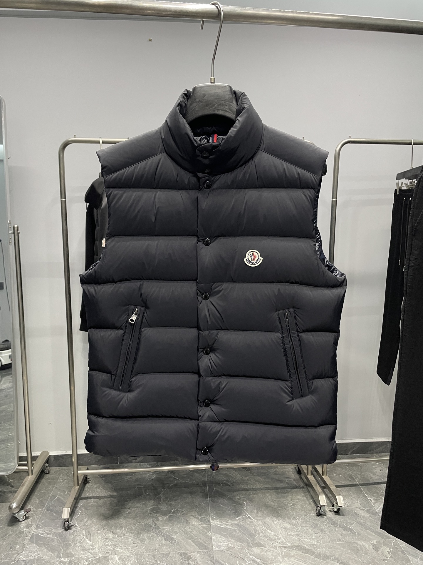 NO:610697,MOC25RFW new autumn and winter black matte nylon stand collar down vest, the same classic felt badge fashion warm down vest jacket for men and women!  The trading company channel is rarely available, and it is available for sale on the official website simultaneously for 10610RMB!  Fameng's new down vest uses high-end materials, exquisite craftsmanship and thoughtful design to bring you a dual experience of warmth and fashion!  In this cold season, wear it to make yourself the most dazzling presence on the street!   This vest is made of imported black matte nylon material. Compared with ordinary nylon fabrics, it is a little less ostentatious and shiny, but has a little more low-key and luxurious charm!  The contrasting paint nylon lining is ingeniously designed and has good breathability. Even in cold winters, the heat and moisture generated by the body can be quickly discharged, keeping the body dry and comfortable!  At the same time, it can also effectively prevent down from drilling out, avoiding the embarrassing situation that traditional down jackets tend to have, greatly improving the comfort of wearing it!  The interior is filled with high-quality 90% white duck down, and every feather is light and fluffy, as if it contains endless warm energy!  The designer cleverly used horizontal quilting technology to evenly fill the inside of the vest with white duck down. This grid filling method not only makes the vest look fuller and more stylish, but also effectively fixes the down to prevent it from accumulating or shifting during wearing!  The classic felt badge on the chest is beautifully designed and crafted with exquisite craftsmanship, and every detail is handled just right!  It not only adds a unique personality and sense of fashion to the vest, but also acts as a status symbol, highlighting the wearer's pursuit of quality and taste!  The placket adopts a four-button zipper double opening and closing method. This design not only ensures the firmness and sealing of the placket, but also makes it easier for the wearer to put on and take off!  When you zip up the zipper and fasten the snap button, the entire fly is like a solid line of defense, keeping the cold out!  All accessories are engraved with the brand logo, which not only reflects the brand's strict control of quality, but also highlights the brand's unique charm and cultural connotation!  The small stand-up collar design is simple yet elegant. It can not only protect the neck from the cold wind, but also show a capable and neat temperament!  The fitted version follows the curves of the body and is neither too loose and bulky nor too tight to restrict movement!  Color black Size 1-5 Size reference Size 1 should have a shoulder width of 44cm - bust 114cm - dress length 68cm Size 2 should have a shoulder width 45cm - chest 118cm - dress length 69cm Size 3 should have a shoulder width 46cm - chest 122cm - dress length 70cm Size 4 should have a shoulder width 47cm - chest 126cm - dress length 72cm Size 5 should have a shoulder width 48cm - chest 122cm - dress length 74cm  Size recommendation (standard version) Height 174-jin, try on size 2 which is suitable!  For boys, choose size 1 if you weigh less than 143 pounds, choose size 2 if you weigh -143 pounds, choose size 3 if you weigh 143-156 pounds, choose size 4 if you weigh 156-172 pounds, and choose size 5 if you weigh 172-188 pounds!  All girls can choose size 1!  ,,jackets & coats,down jacket,alexander wang19860909MOC25RFW秋冬新款黑色哑光尼龙立领羽绒马甲,男女同款经典毛毡徽章时尚保暖羽绒马甲外套！贸易公司渠道稀出,同步官网发售10610RMB！法蒙家新款羽绒马甲奉献,采用高级的材质、精湛的工艺和贴心的设计,为你带来温暖与时尚的双重体验！在这个寒冷的季节里,穿上它让自己成为街头最耀眼的存在！  该马甲采用客供进口黑色哑光尼龙材质,与普通的尼龙面料相比,它少了几分张扬的光泽,却多了几分低调而奢华的韵味！撞色漆面尼龙内衬,设计堪称巧妙,具有良好的透气性,即使在寒冷的冬日里,身体产生的热气和湿气也能迅速排出,保持身体的干爽舒适！同时它还能有效防止羽绒钻出,避免了传统羽绒服容易出现钻绒的尴尬情况,大大提升了穿着的舒适性！内里选用了优质的90白鸭绒作为填充物,每一根羽毛都轻盈蓬松,仿佛蕴含着无尽的温暖能量！设计师巧妙地采用了横向绗缝技术,将白鸭绒均匀地分格填充在马甲内部,这种分格填充的方式不仅让马甲看起来更加饱满有型,还能有效地固定羽绒,防止其在穿着过程中出现堆积或移位的情况！ 胸前经典毛毡徽章,设计精美工艺精湛,每一个细节都处理得恰到好处！它不仅为马甲增添了一份独特的个性和时尚感,更像是一种身份的象征,彰显着穿着者对品质和品味的追求！门襟采用了四合扣拉链双重开合的方式,这种设计既保证了门襟的牢固性和密封性,又方便了穿着者的穿脱！当你拉上拉链,再扣上四合扣,整个门襟就像一道坚固的防线,将寒冷隔绝在外！所有的辅料均刻有品牌 Logo,这不仅体现了品牌对品质的严格把控,更彰显了品牌的独特魅力和文化内涵！小立领设计简约而不失优雅,既能很好地保护颈部免受寒风的侵袭,又能展现出一种干练利落的气质！合体的版型则贴合身体曲线,既不会过于宽松显得臃肿,也不会过于紧身限制活动！ 颜色黑色 尺码1-5 尺寸参考 1码肩宽44cm-胸围114cm-衣长68cm 2码肩宽45cm-胸围118cm-衣长69cm 3码肩宽46cm-胸围122cm-衣长70cm 4码肩宽47cm-胸围126cm-衣长72cm 5码肩宽48cm-胸围cm-衣长74cm 尺码推荐（标准版型） 身高174-斤,试穿2码合适！ 男生体重斤以内选择1码,-143斤选择2码,143-156斤选择3码,156-172斤选择4码,172-188斤选择5码！ 女生全部选择1码即可！,,jackets & coats,down jacket,alexander wang,Men's clothing