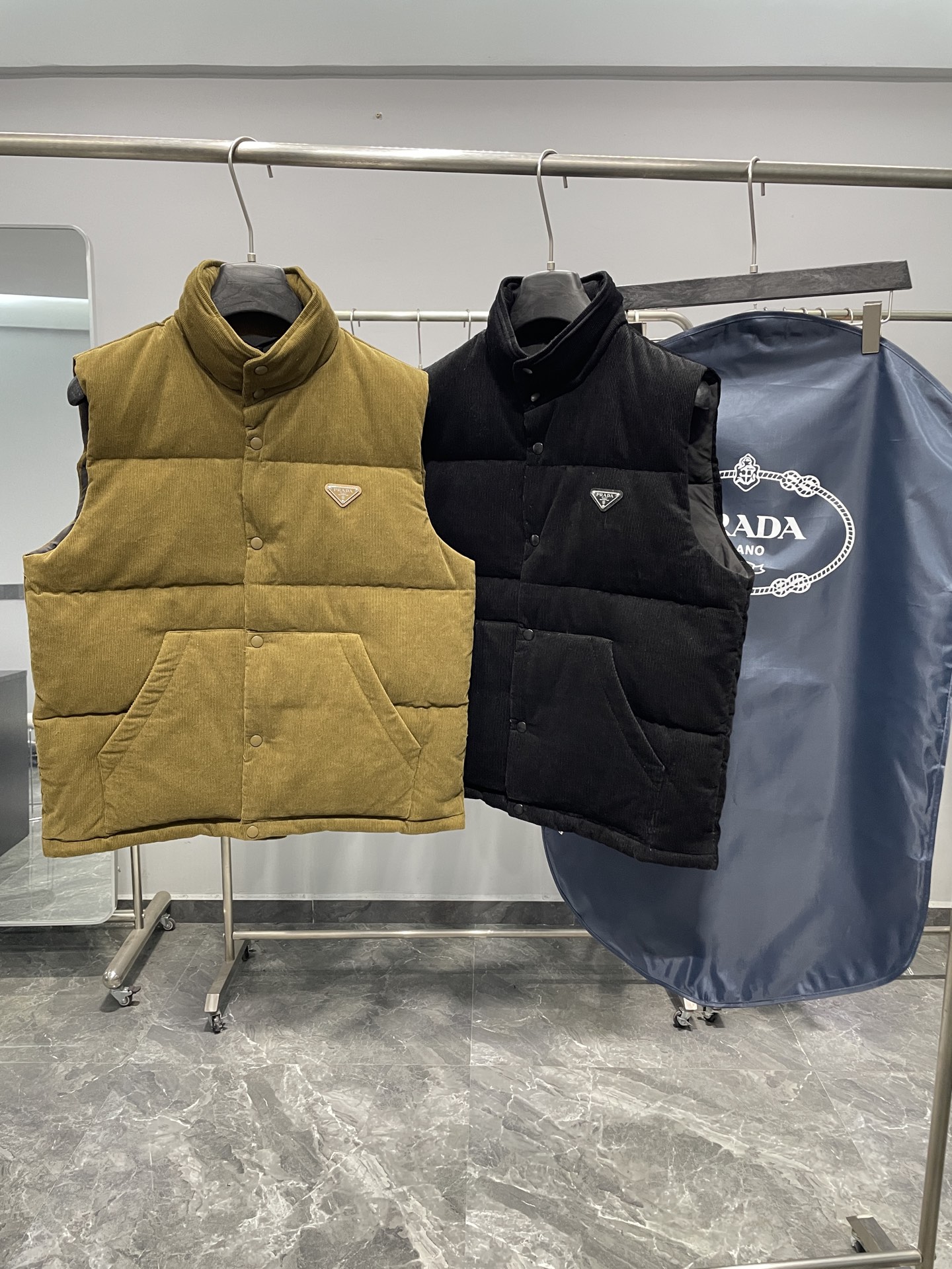 NO:646010,Prada 25FW This triangular logo is made of genuine leather, and the triangular logo hardware logo Prada letters are polished by hand to have no uneven feeling, just like ZP. There are three pockets inside. There is an invisible hat behind the collar, all the details are the same as ZP. It comes with an exclusive dust bag. Please pay attention to the details for the higher version. New autumn and winter corduroy stand-up collar warm down vest!  The classic triangular logo vest is the same for both men and women. The corduroy fabric is really soft. It is definitely a highlight of autumn and winter wear. It is a fashionable tool for autumn and winter that can be worn by both men and women. For this kind of classic that is not easy to go out of style, fashionable men and women can buy it with confidence. It is definitely the best choice as a daily commuting item!  This down vest is made of custom-woven corduroy material supplied by customers. The surface of the fabric has three-dimensional and warm groove details, which visually brings a retro and nostalgic tone. It has a bit of 70s feel mixed in, giving people a lazy and relaxing feeling!  The delicate and smooth fiber lining inside is filled with 90% white goose down. It has sufficient down filling and is free of stems and clumps. It has a full and soft down texture. It rebounds instantly when pressed. It can effectively lock in and gather body temperature, bringing you the warmest and most comfortable wearing experience!  The basic and conventional stand-up collar vest style cutting, simple and neat design, can easily create a fashionable and elegant casual look!  Size S-XL,,prada,down jacket,hats,alexander wang19860909Prada 25FW 此款三角标采用真皮、三角标五金logo Prada字母采用磨平工艺用手抚摸无凹凸感和ZP一样.内里设有三个口袋. 领口后方设有隐形帽子、所有细节和ZP一样. 配专属防尘袋.高版本请认准细节.秋冬新款灯芯绒立领保暖羽绒马甲！男女同款经典三角标马甲,灯芯绒面料真的好温柔哦,绝对是秋冬穿搭的一大亮点～ 男女通穿的秋冬时尚着装利器,对于这种不易过时的经典之作,各位潮男潮女们可以放心入手,作为日常通勤单品搭配绝对是最佳的选择！ 此款羽绒背心甄选客供定织灯芯绒材质制作而成,面料表面立体温润的坑条细节,视觉上自带复古怀旧腔调,骨子里混了些许70年代的feel,给人慵懒放松的感觉！内里细腻爽滑的纤维内衬,搭配90白鹅绒填充,充绒量足且无梗不结块,饱满柔软的羽绒质感,按压下去瞬间回弹,着身可以有效的锁温聚温,带来最保暖舒适的着穿体验！基础常规的立领马甲版型裁剪,简洁利落的设计,可轻松打造时尚大气的休闲造型！ 尺码S-XL,,prada,down jacket,hats,alexander wang,Men's clothing