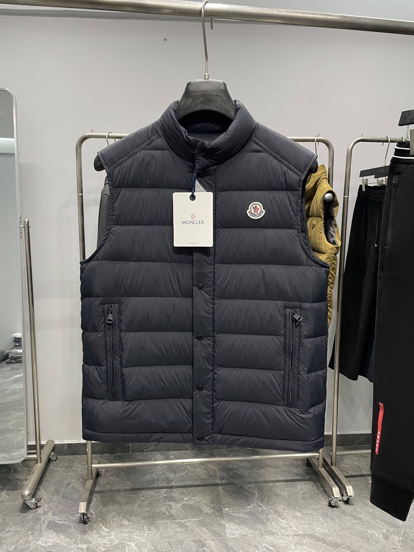 NO:645977,MOC25FW new autumn and winter navy blue thin nylon stand collar down vest, the same classic felt badge thin down jacket vest jacket for men and women!  Trading company channels are rare and available on the official website simultaneously!  Farmon's new lightweight down vest, with its excellent fabrics, high-quality filling, exquisite decoration, unique design and fitted version, has become the perfect combination of fashion and warmth!  Wearing it can not only protect you from the cold, but also show your unique taste and fashion attitude!  This vest is made of custom-made densely woven nylon fabric. Its densely woven structure makes the fabric tight and strong, which can effectively block the intrusion of cold air from the outside and build a solid line of defense for the body to keep warm!  At the same time, it has good breathability and will not make the body feel stuffy or uncomfortable during wearing. It is like installing an intelligent temperature control system on the body to always maintain a comfortable state!  The interior is filled with national standard 90 white duck down, which has strong thermal insulation properties and tightly locks in body heat, allowing you to feel as warm as spring in cold weather!  And paired with exquisite quilting technology, these white duck down quilts are cleverly fixed in corresponding positions and distributed very evenly, without being too thick or too thin locally. The overall upper body effect is extremely light, as if the body is covered with a layer of soft clouds, without any sense of burden, but extremely warm!  The iconic felt badge embroidery on the chest is made of exquisite felt material. It has been carefully hand-embroidered by craftsmen, and every detail is handled just right!  This badge is not just a simple decoration, but also a status symbol. It represents unique taste and the pursuit of quality life!  The placket adopts a buttoned zipper opening and closing design. This unique design perfectly combines the classic buttoning with the convenience of a zipper!  The hardware has excellent texture, and every part has been carefully polished and exudes the unique luster of metal, demonstrating high-quality craftsmanship!  The fashionable small stand-up collar design is simple and capable. It can fit the neck well and keep warm without looking too bulky!  The fitting style is the finishing touch of this vest. It can perfectly fit the curves of the body and show off your beautiful figure!  Color Navy Blue Size 1-5 Size Reference Size 1: Shoulder Width 43 Bust 104 Clothing Length 62 Size 2: Shoulder Width 44 Bust Length 63 Size 3: Shoulder Width 45 Bust 112 Clothing Length 64 Size 4: Shoulder Width 46 Bust 116 Clothing Length 65 Size 5: Shoulder Width 47 Bust Length 66,, jackets & coats, down jacket, alexander wang19860909MOC25FW秋冬新款藏蓝色轻薄尼龙立领羽绒马甲,男女同款经典毛毡徽章轻薄款羽绒服马甲外套！贸易公司渠道稀出,同步官网发售！法蒙家全新轻薄款羽绒马甲,以其卓越的面料、优质的填充、精致的装饰、独特的设计和合身的版型,成为了时尚与温暖的完美结合体！穿上它你不仅能抵御寒冷,更能展现出自己的独特品味和时尚态度！ 这款马甲采用客供定制密织尼龙面料,其密织结构使得面料紧密而结实,能够有效阻挡外界冷空气的侵入,为身体构筑起一道坚实的保暖防线！同时它又具有良好的透气性,不会让身体在穿着过程中感到闷热和不适,就像给身体安装了一个智能的温控系统,始终保持舒适的状态！内里采用国标90白鸭绒进行填充,具有极强的保暖性能,紧紧锁住身体的热量,让你在寒冷的天气里也能感受到如春日般的温暖！并且搭配上精湛的绗缝工艺,这些白鸭绒被巧妙地固定在相应的位置,分布得十分均匀,不会出现局部过厚或过薄的情况,整体上身效果轻盈无比,仿佛身上披着一层轻柔的云朵,毫无负担感,却又温暖至极！ 胸前标志性毛毡徽章刺绣,采用了精致的毛毡材质,经过工匠们细致的手工刺绣,每一个细节都处理得恰到好处！这枚徽章不仅仅是一个简单的装饰,更是一种身份的象征,它代表着独特的品味和对品质生活的追求！门襟采用了排扣拉链开合设计,这种独特的设计将排扣的经典与拉链的便捷完美结合！五金质感极佳,每一个零件都经过精心打磨,散发着金属特有的光泽,彰显出高品质的工艺水准！时尚的小立领设计,造型简洁而干练,既能够很好地贴合颈部,起到保暖的作用,又不会显得过于臃肿！合身的版型更是这款马甲的点睛之笔,它能够完美地贴合身体曲线,展现出你的优美身姿！ 颜色藏蓝色 尺码1-5 尺寸参考 1码:肩宽43胸围104衣长62 2码:肩宽44胸围衣长63 3码:肩宽45胸围112衣长64 4码:肩宽46胸围116衣长65 5码:肩宽47胸围衣长66,,jackets & coats,down jacket,alexander wang,Men's clothing