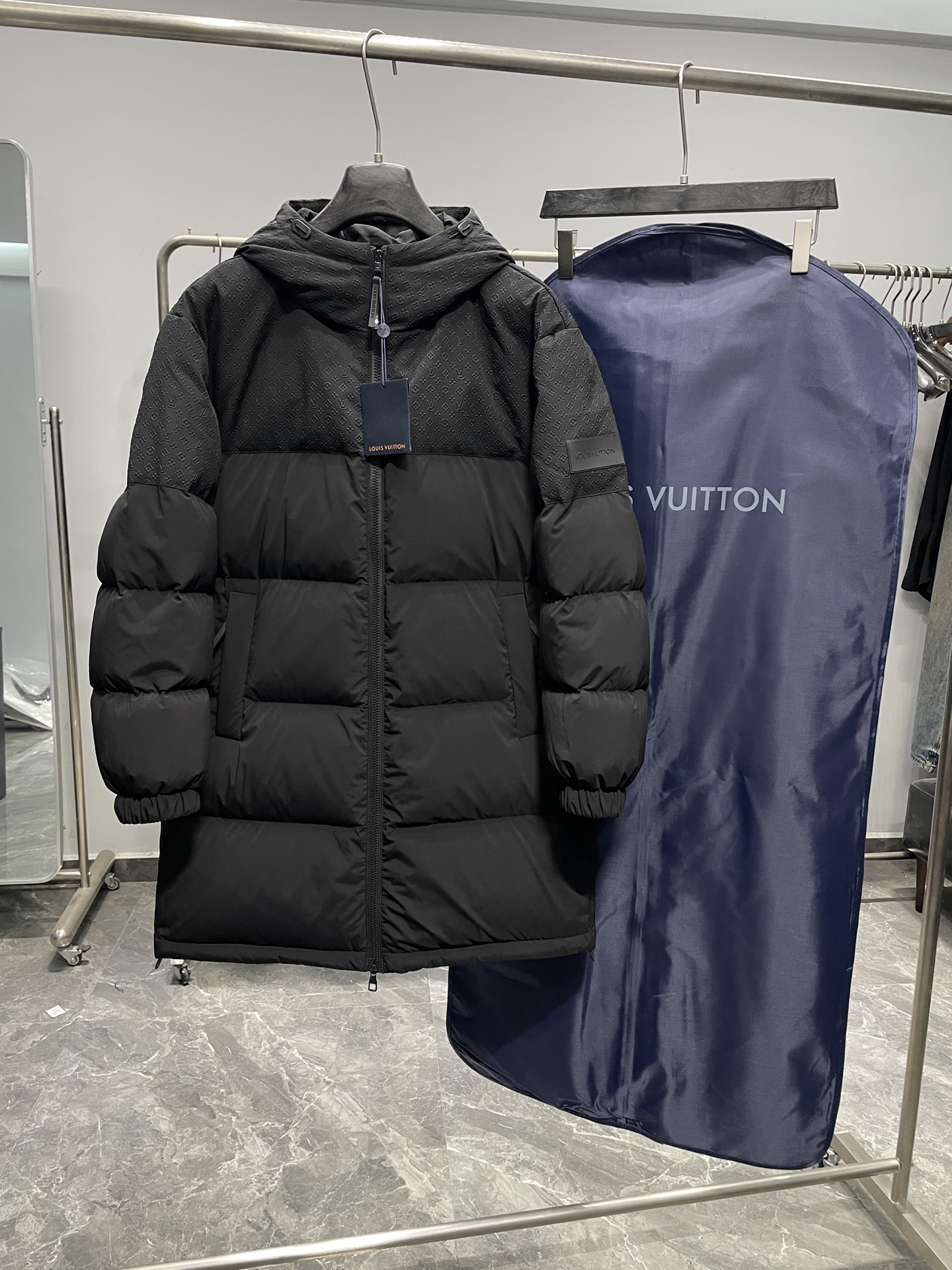 NO:691160,1V25FW new winter embossed embossed stitching mid-length down jacket!  Made of mixed fabrics. The spliced fabric combination not only ensures the softness, comfort and durability of the garment, but also gives it a unique texture and appearance. Jacquard relief printing is done on the technical fabric. The jacquard process uses a controllable shuttle during the weaving process to realize the weaving of the pattern.  The embossing process uses heat pressing to process the patterns in the fabric into a three-dimensional effect, giving the fabric surface a concave and convex effect. The embossing process mainly heats the fabric through a mold, so that the patterns in the fabric are raised to form a contour. The use of yoke design can well shape the body shape and show the elegant lines of the wearer. The detachable hood design integrated into the collar is both practical and fashionable. The hood is embellished with Mini Monogram embossing and complements the overall style.  Brand elements: Donkey brand silicone patch on the left sleeve with a classic logo leather label. This detailed design highlights the brand's unique charm and exquisite craftsmanship. Color black Size 48-54 Size reference Size 48: shoulder width 54 bust 120 sleeve length 61 length 92 Size 50: shoulder width 53 bust 124 sleeve length 62 length 93 Size 52: shoulder width 54 bust 128 sleeve length 63 length 94  Size 54: shoulder width 55, bust 132, sleeve length 64, dress length 95,,louis vuitton,down jacket,hats,198609091V25FW冬季新款浮雕压花拼接中长款羽绒服！ 采用混合面料制成 拼接面料组合不仅保证了服装的柔软舒适和耐用度 还赋予了独特的质感和外观 科技面料上做了提花浮雕印花工艺  提花工艺通过在织造过程中,使用可控制的梭子来实现图案的织造. 浮雕工艺通过热压工艺将面料中的花纹处理成具有立体感的效果,使面料表面呈现出一种凹凸有致的效果.浮雕主要是通过模具对面料进行热压,从而使面料中的花纹凸起形成轮廓感. 采用育克设计 能够很好地塑造身形 展现穿着者的优雅线条. 可拆卸风帽融入衣领的可拆卸风帽设计 既实用又时尚.风帽上点缀着Mini Monogram压纹 与整体风格相得益彰. 品牌元素 驴牌硅酮贴饰左袖上车上了经典标识的皮标.这一细节设计彰显了品牌的独特魅力和精湛工艺. 颜色黑色 尺码48-54 尺寸参考 48码:肩宽54胸围120袖长61衣长92 50码:肩宽53胸围124袖长62衣长93 52码:肩宽54胸围128袖长63衣长94 54码:肩宽55胸围132袖长64衣长95,,louis vuitton,down jacket,hats,,Men's clothing