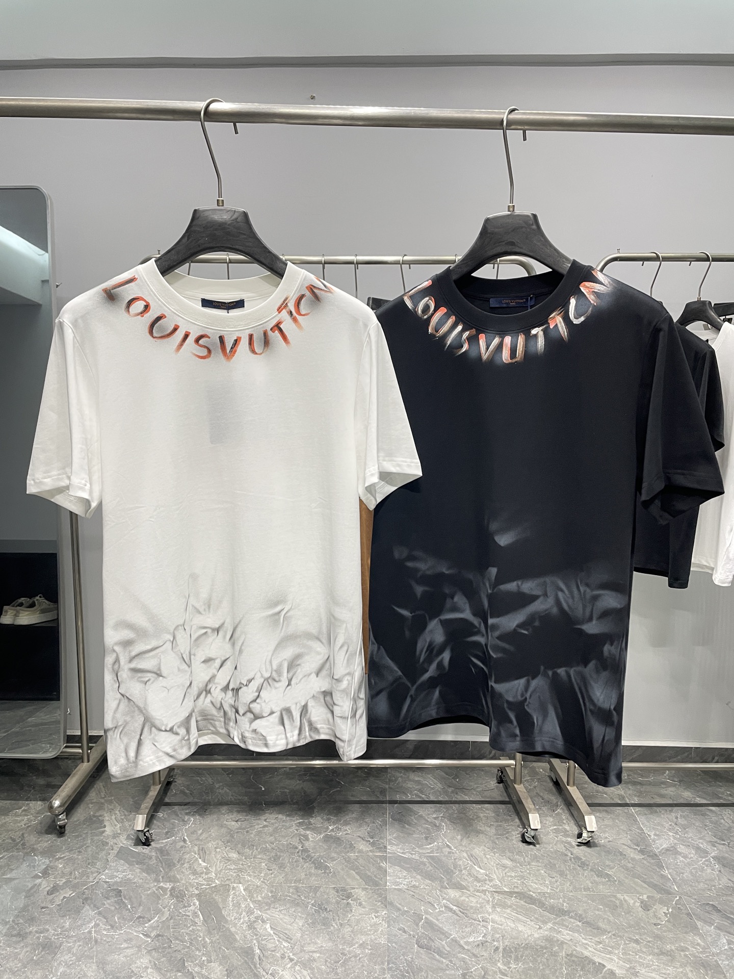 NO:857849,1V26SS new spring and summer art graffiti pure cotton round neck short-sleeved T-shirt!  The collision of urban avant-garde and French luxury fashion perfectly integrates the brand's classic elements with the sense of street art. It is an iconic item for modern luxury fashion.  The luxury brand originated from Paris, with the gradient orange and black graffiti letters on the neckline as the visual focus, paired with pleated smudged texture on the hem, and hand-painted four-leaf flowers and handwritten brand logo on the back, breaking the stereotype of traditional luxury products and injecting casual and uninhibited artistic tension into the simple silhouette. The back collar  The reverse label and the brand mark on the neckline show French ingenuity in every detail. The high-count pure cotton fabric is selected, which is soft and skin-friendly, breathable and sweat-wicking, and has both comfort and stiffness. The gradient dyeing process and graffiti printing are strong and durable, and will not easily deform and fade after being washed for a long time, making it suitable for daily wear in many seasons.  The black and white two-color base is suitable for a variety of styles. When worn alone, it can highlight the avant-garde sense of graffiti and pleat design. When worn alone, a suit or a denim jacket can balance elegance and casualness. The bottoms can be paired with overalls and wide-leg jeans to create a cool street style. Paired with trousers, it can unlock a light luxury business style. It is a versatile luxury product that shows individual taste. This T-shirt is not only a piece of clothing, but also a new interpretation of street art and French luxury, allowing you to easily control multiple scenes in daily life and release a unique trend attitude.  Color White, Black Size S-XXL Size Reference S Size Shoulder Width 43 Bust 100 Length 69 M Size Shoulder Width 44 Bust 104 Length 70 L Size Shoulder Width 45 Bust 108 Length 71 XL Size Shoulder Width 46 Bust 112 Length 72 2  suit,198609091V26SS春夏新款艺术涂鸦纯棉圆领短袖T恤！ 都市先锋与法式奢潮的碰撞,将品牌经典元素与街头艺术感完美融合,是现代奢潮穿搭的标志性单品. 源自巴黎的奢侈品牌,以领口渐变橙黑涂鸦字母为视觉焦点,搭配下摆褶皱晕染肌理,背面手绘四叶花卉与手写体品牌标识,打破传统奢品的刻板印象,在简约廓形中注入随性不羁的艺术张力.后领的反向标签与领口的品牌标,细节处彰显法式匠心.甄选高支纯棉面料,触感柔软亲肤,透气排汗,兼具舒适感与挺括度.渐变晕染工艺与涂鸦印花牢固耐穿,久洗不易变形褪色,适配多季节日常穿着. 黑白双色基底适配多元风格,单穿时可凸显涂鸦与褶皱设计的先锋感,叠穿西装、牛仔外套则能平衡奢雅与随性.下装搭配工装裤、阔腿牛仔裤可打造街头潮酷感,搭配西裤则能解锁轻奢商务风,是彰显个性品味的百搭奢品.这件T恤不止是一件衣物,更是对街头艺术与法式奢华的全新诠释,让你在日常中轻松驾驭多元场景,释放独特潮流态度. 颜色白色、黑色 尺码S-XXL 尺寸参考 S码肩宽43胸围100衣长69 M码肩宽44胸围104衣长70 L码肩宽45胸围108衣长71 XL码肩宽46胸围112衣长72 2XL码肩宽47胸围116衣长73,,jeans,jackets & coats,T-shirt,tees，t-shirt,business suit,,Men's clothing