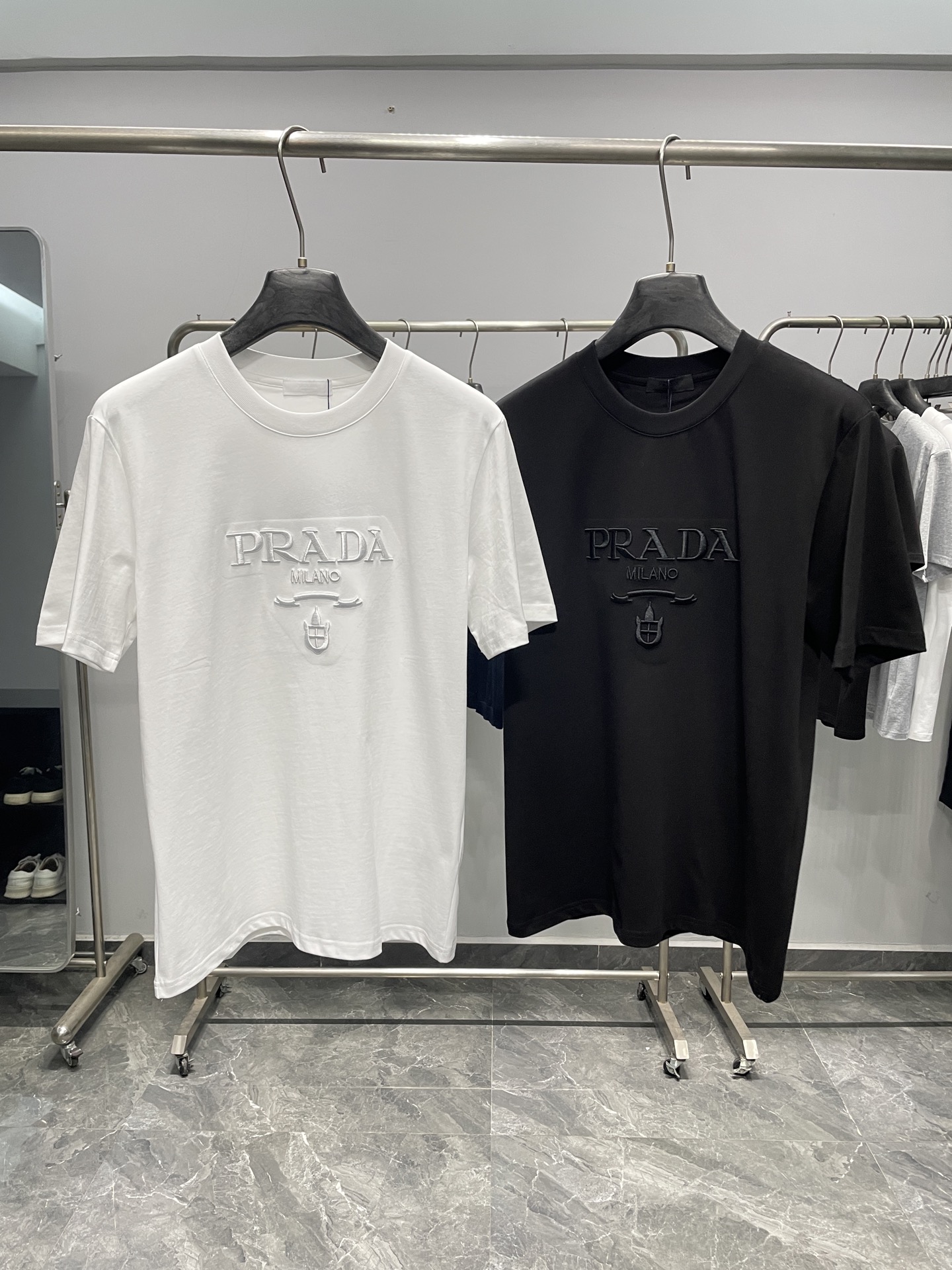 NO:777731,PRA26SS new spring and summer new plain knitted cotton basic round neck short T-shirt, the same style for men and women with three-dimensional letter logo embroidery casual short-sleeved T-shirt!  Trading company channels are rare and available on the official website simultaneously!  P's new early spring T-shirt is online. It is not just an ordinary piece of clothing, but a perfect combination of fashion attitude and exquisite craftsmanship, carrying the brand's profound cultural heritage and persistent pursuit of quality!  This T-shirt is made of custom-made plain knitted cotton fabric. Its texture is fine and soft, and the touch is as gentle as a cloud. When worn close to the body, it feels like being gently wrapped by a layer of soft clouds, without any sense of restraint!  At the same time, the fabric also has good breathability and moisture absorption, which can keep the skin dry and comfortable even in the hot summer, effectively avoiding stuffiness and stickiness, and bringing the wearer the ultimate comfortable experience!  The classic letter logo embroidery on the front is undoubtedly the soul of the entire piece of clothing. It carries the history and glory of the brand and is a symbol of the brand's identity!  The designer put countless efforts into designing these letters, and every stroke was carefully carved, striving to achieve the most perfect shape!  The font is full and stylish, and the lines are smooth and full of tension. It not only shows the stability and grandeur of the brand, but also retains the agility and vitality of fashion!  Fitted version design, this version does not blindly pursue tightness or looseness, but is designed based on ergonomic principles after careful measurement and repeated testing. It can perfectly fit the body curves, showing the wearer's figure advantages without restricting the body's activities too much!  Color White, Black Size S-XXL Size Reference S Size Shoulder Width 45 Bust Length 67 M Size Shoulder Width 46 Bust 104 Length 68 L Size Shoulder Width 47 Bust 108 Length 69 XL Shoulder Width 48 Bust 112 Length 70 219860909PRA26SS春夏新款平纹针织棉布基础圆领短Tee,男女同款立体字母徽标刺绣休闲短袖T恤衫！贸易公司渠道稀出,同步官网发售！P家早春新款T恤上线,它不仅仅是一件普通的衣物,更是时尚态度与精湛工艺的完美结合,承载着品牌深厚的文化底蕴与对品质的执着追求！ 这款T恤采用客供定制平纹针织棉布,其质地细腻柔软,触感如同云朵般轻柔,贴身穿在身上,仿佛被一层轻柔的云朵温柔包裹,毫无束缚感！同时面料还具有良好的透气性和吸湿性,即使在炎炎夏日,也能让肌肤保持干爽舒适,有效避免了闷热和黏腻感,为穿着者带来极致的舒适体验！前幅经典字母徽标刺绣无疑是整件衣服的灵魂所在,承载着品牌的历史与荣耀,是品牌身份的象征！设计师在设计这些字母时,倾注了无数的心血,每一个笔画都经过精心雕琢,力求达到最完美的形态！字体饱满有型,线条流畅而富有张力,既展现了品牌的稳重与大气,又不失时尚的灵动与活力！合身版型设计,这种版型并非一味地追求紧身或宽松,而是经过精心测量和反复试验,根据人体工程学原理设计而成,它能够完美地贴合身体曲线,既展现出穿着者的身材优势,又不会过于束缚身体的活动！ 颜色白色、黑色 尺码S-XXL 尺寸参考 S码肩宽45胸围衣长67 M码肩宽46胸围104衣长68 L码肩宽47胸围108衣长69 XL码肩宽48胸围112衣长70 2XL码肩宽49胸围116衣长71,,prada,T-shirt,tees，t-shirt,,Men's clothing